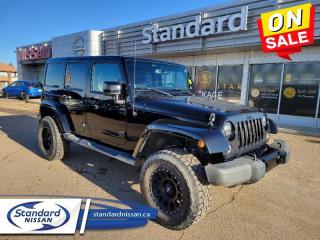 <b>Premium Audio System,  A/C,  Remote Keyless Entry,  Cruise Control!</b><br> <br>  Compare at $27499 - Our Price is just $25925! <br> <br>     This  2014 Jeep Wrangler Unlimited is for sale today in Swift Current. <br> <br>The 2014 Jeep Wrangler Unlimited takes the off-road capability and style of the standard Wrangler and adds on two extra doors for extra convenience. The Wrangler Unlimited is a rugged 4X4 vehicle, offering a high ground clearance, huge wheel-arches, and a square stance that were all part of the original Jeep design that made it world famous. The Wrangler Unlimited also holds onto Jeeps classic seven-slot front grill and round headlights adding to its appeal. Although the Wrangler has grown over time from the original Jeep, the family resemblance is unmistakable. This  SUV has 168,227 kms. Its  black in colour  . It has a 6 speed automatic transmission and is powered by a  285HP 3.6L V6 Cylinder Engine.  <br> <br> Our Wrangler Unlimiteds trim level is SAHARA. Rugged and refined, the 2014 Jeep Wrangler Sahara features a heavy-duty suspension and shock absorbers, aluminum wheels, remote power doors, side steps, an Infinity 7 speaker audio system and an auxiliary input jack, air conditioning, auto-dimming rearview mirror, a leather steering wheel and tinted rear windows. This vehicle has been upgraded with the following features: Premium Audio System,  A/c,  Remote Keyless Entry,  Cruise Control. <br> To view the original window sticker for this vehicle view this <a href=http://www.chrysler.com/hostd/windowsticker/getWindowStickerPdf.do?vin=1C4BJWEG7EL268483 target=_blank>http://www.chrysler.com/hostd/windowsticker/getWindowStickerPdf.do?vin=1C4BJWEG7EL268483</a>. <br/><br> <br>To apply right now for financing use this link : <a href=https://www.standardnissan.ca/finance/apply-for-financing/ target=_blank>https://www.standardnissan.ca/finance/apply-for-financing/</a><br><br> <br/><br>Why buy from Standard Nissan in Swift Current, SK? Our dealership is owned & operated by a local family that has been serving the automotive needs of local clients for over 110 years! We rely on a reputation of fair deals with good service and top products. With your support, we are able to give back to the community. <br><br>Every retail vehicle new or used purchased from us receives our 5-star package:<br><ul><li>*Platinum Tire & Rim Road Hazzard Coverage</li><li>**Platinum Security Theft Prevention & Insurance</li><li>***Key Fob & Remote Replacement</li><li>****$20 Oil Change Discount For As Long As You Own Your Car</li><li>*****Nitrogen Filled Tires</li></ul><br>Buyers from all over have also discovered our customer service and deals as we deliver all over the prairies & beyond!#BetterTogether<br> Come by and check out our fleet of 40+ used cars and trucks and 40+ new cars and trucks for sale in Swift Current.  o~o
