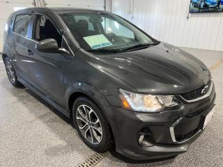 <div>This 2018 Chevrolet Sonic LT Hatchback, finished in an alluring Nightfall Grey Metallic, is a compact and sporty vehicle that offers a blend of efficiency and style. As a used model, the Sonic showcases a well-maintained appearance, with a sleek exterior that is complemented by a Jet Black Deluxe Cloth interior, creating a sophisticated and comfortable cabin ambiance.</div><br /><div><br></div><br /><div>Under the hood, this Sonic is equipped with a peppy 1.8L 4-cylinder engine paired with an Automatic Transmission, delivering a balance of power and fuel efficiency.</div><br /><div><br></div><br /><div>This particular trim, the LT, comes with the RS Package which includes:</div><br /><div>- A sport body kit for an aggressive and aerodynamic appearance</div><br /><div>- Fog lamps that enhance visibility in challenging weather conditions</div><br /><div>- Sporty rocker moldings that add to the cars dynamic profile</div><br /><div>- Black Chevrolet bowtie emblems that provide a modern and sleek look</div><br /><div>- RS lettering that signifies the vehicles sport-tuned heritage</div><br /><div>- Piano Black-accented instrument panel which adds a touch of elegance to the interior</div><br /><div>- A 3-spoke leather-wrapped flat-bottom sport steering wheel with contrasting stitching, which not only looks great but provides a comfortable grip</div><br /><div>- Deluxe carpeted front and rear floor mats for added interior protection and style</div><br /><div><br></div><br /><div>In terms of features, the Sonic LT does not disappoint. Some of the key features include:</div><br /><div>- Alloy / Aluminum Wheels that are both lightweight and stylish</div><br /><div>- Telescopic Steering Wheel for adjustable comfort and control</div><br /><div>- Cruise Control for easy long-distance driving</div><br /><div>- Passenger Front Airbag Off/On for customizable safety</div><br /><div>- Driver Side Airbag for added protection</div><br /><div>- Anti-lock Brakes / ABS for improved safety and stopping power</div><br /><div>- Theft Deterrent/Alarm to keep your vehicle secure</div><br /><div>- Child Safety Locks for peace of mind when traveling with young passengers</div><br /><div><br></div><br /><div>For tech-savvy drivers, the Sonic LT offers a 7-inch color touch screen infotainment center that is Apple CarPlay and Android Auto compatible. This means you can easily access your favorite apps, navigation, and media on the go. </div><br /><div><br></div><br /><div>Comfort is a priority with heated front seats to keep you warm during colder months.  Moreover, the vehicle includes Bluetooth connectivity for phone and audio streaming, allowing for hands-free calls and music playback. A rear vision camera aids in parking and reversing, while the rear spoiler not only adds a sporty flair but also improves aerodynamics. For added convenience, the Sonic comes with a remote start system, perfect for those chilly mornings or hot days when you want to pre-condition the cars interior.</div><br /><div><br></div><br /><div>At Sisson Auto, they emphasize customer satisfaction and transparency. The Sonic comes with a range of customer-focused benefits, such as a 3-day/600 km No-Hassle Return Policy, a 30-day exchange privilege, Sisson Auto Certified 3 month or 6000km Powertrain Warranty with 24-hour roadside assistance, a check for safety recalls, and a complimentary CarFax history report. Additionally, they offer free home delivery within 200 km.</div><br /><div><br></div><br /><div>Overall, this 2018 Chevrolet Sonic LT Hatchback is an ideal vehicle for those looking for a combination of sporty performance, advanced features, and practicality in a compact hatchback form.</div><br /><div>** This description was written by AI based on information provided about the vehicle. AI can sometimes produce incorrect information. Please confirm all details with the dealership. </div>