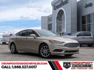 <b>Bluetooth,  Rear View Camera,  SiriusXM,  SYNC,  Aluminum Wheels!</b><br> <br> Welcome to Crowfoot Dodge, Calgarys New and Pre-owned Superstore proudly serving Albertans for 44 years!<br> <br> Compare at $19995 - Our Price is just $17995! <br> <br>   The newly designed 2017 Fusion is more stunning than ever. This  2017 Ford Fusion is fresh on our lot in Calgary. <br> <br>Driving a new 2017 Ford Fusion allows you to express your own unique self, wherever life might take you. The Fusion offers an exhilirating drive with precision handling and a comfortable ride. The Fusion also offers a wide range of technologies to help keep you aware of your surroundings and ever-changing road conditions. This  sedan has 168,924 kms. Stock number 239384A is gold in colour  . It has a 6 speed automatic transmission and is powered by a  175HP 2.5L 4 Cylinder Engine.   <br> <br> Our Fusions trim level is SE. The most popular car in the Ford Fusion lineup is the SE model which comes with some very impressive features. These features include power front seats, stylish aluminum wheels, an upgraded 6 speaker sound system with SiriusXM radio, SYNC infotainment system with Bluetooth wireless streaming, a backup camera, LED signature lighting and push button start.  This vehicle has been upgraded with the following features: Bluetooth,  Rear View Camera,  Siriusxm,  Sync,  Aluminum Wheels. <br> <br/><br>At Crowfoot Dodge, we offer:<br>
<ul>
<li>Over 500 New vehicles available and 100 Pre-Owned vehicles in stock...PLUS fresh trades arriving daily!</li>
<li>Financing and leasing arrangements with rates from prime +0%</li>
<li>Same day delivery.</li>
<li>Experienced sales staff with great customer service.</li>
</ul><br><br>
Come VISIT us today!<br><br> Come by and check out our fleet of 90+ used cars and trucks and 130+ new cars and trucks for sale in Calgary.  o~o