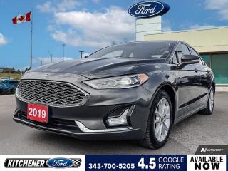 Magnetic Metallic 2019 Ford Fusion Energi Titanium 4D Sedan 2.0L I4 Atkinson-Cycle Hybrid Electric E-CVT Automatic FWD 2.0L I4 Atkinson-Cycle Hybrid Electric, 12 Speakers, 4-Wheel Disc Brakes, ABS brakes, Air Conditioning, Alloy wheels, AM/FM radio: SiriusXM, Auto High-beam Headlights, Auto-dimming door mirrors, Auto-dimming Rear-View mirror, Automatic temperature control, Brake assist, Bumpers: body-colour, CD player, Compass, Delay-off headlights, Driver door bin, Driver vanity mirror, Dual front impact airbags, Dual front side impact airbags, Electronic Stability Control, Emergency communication system: SYNC 3 911 Assist, Equipment Group 850A, Exterior Parking Camera Rear, Four wheel independent suspension, Front anti-roll bar, Front Bucket Seats, Front dual zone A/C, Front fog lights, Front reading lights, Fully automatic headlights, Garage door transmitter, Heated door mirrors, Heated front seats, Heated steering wheel, Heated/Cooled Leather Bucket Seats, Illuminated entry, Knee airbag, Low tire pressure warning, Memory seat, Navigation System, Occupant sensing airbag, Outside temperature display, Overhead airbag, Overhead console, Panic alarm, Passenger door bin, Passenger vanity mirror, Power door mirrors, Power driver seat, Power moonroof, Power passenger seat, Power steering, Power windows, Radio data system, Radio: Sony Premium Sound w/12 Speakers, Rain sensing wipers, Rear anti-roll bar, Rear reading lights, Rear window defroster, Remote keyless entry, Security system, Speed control, Speed-sensing steering, Speed-Sensitive Wipers, Split folding rear seat, Spoiler, Steering wheel mounted audio controls, SYNC 3 Communications & Entertainment System, Tachometer, Telescoping steering wheel, Tilt steering wheel, Traction control, Trip computer, Turn signal indicator mirrors, Variably intermittent wipers, Ventilated front seats, Wheels: 17 Sparkle Silver-Painted Aluminum.