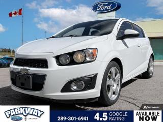 Summit White 2015 Chevrolet Sonic LT 4D Hatchback ECOTEC 1.8L I4 DOHC VVT 6-Speed Automatic FWD Air Conditioning, Alloy wheels, Compass, Delay-off headlights, Deluxe Cloth Seat Trim, Driver door bin, Driver vanity mirror, Fully automatic headlights, Outside temperature display, Passenger door bin, Passenger vanity mirror, Power steering, Power windows, Rear window defroster, Rear window wiper, Remote keyless entry, Steering wheel mounted audio controls, Trip computer, Variably intermittent wipers.