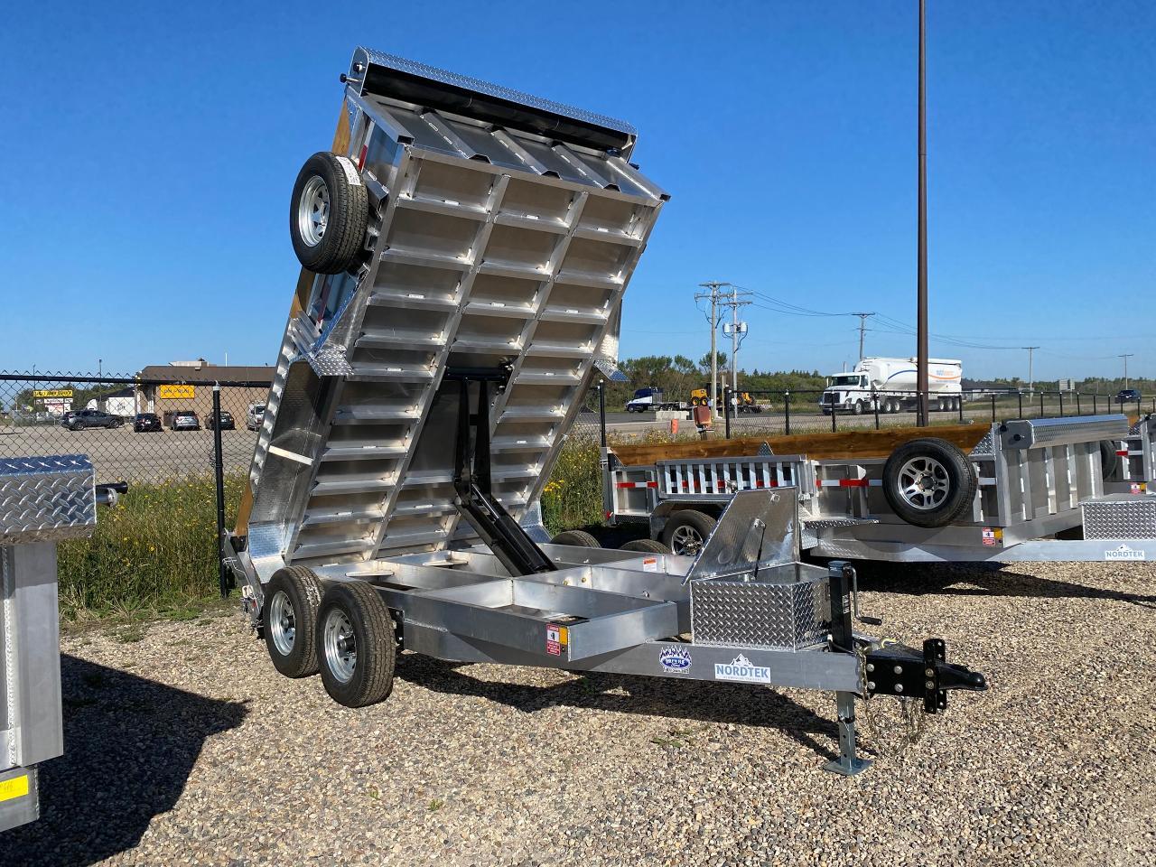 <p>82” x 12’ Dump<br />- 6’ side-mount ramps, 4,000lbs each <br />- 6 bolt wheels on 10k/6 bolt, 8 ply, 5K axle<br />- galvanized rims<br />- 6” channel on the tongue <br />- 6” tubing on main frame <br />- 3” tubing on box frame, 12” on center <br />- 4 tie-down D-rings inside box <br />- Spare tire mount <br />- Easy lube hubs <br />- Spare tire mount <br />- 7,000lb jack - LED lighting<br />- Braided wiring harness for extra durability <br />- 2-5/16” adjustable coupler <br />- Brown, all weather pressure treated boards on top of 18” side walls <br />- Deep toolbox - Drop stands included in rear corners <br />- Deep cycle battery <br />- Hydraulic up and hydraulic down <br />- 3/16” thick sheeting floor <br />- Cover tarp and tarp protector <br />- 5,000lb cylinder lifting capacity<br />- Batter charger & tester 8 amp panel mount</p>