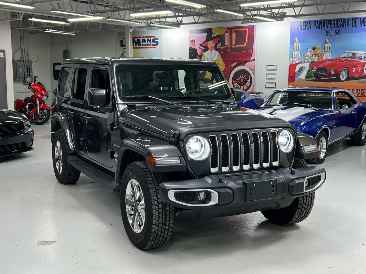 <p>Get ready to conquer any terrain in style with this stunning 2020 Jeep Wrangler Sahara Unlimited, now available at Lee Munros Garage. This Granite Crystal Metallic beauty boasts a luxurious black leather interior, ready to elevate your everyday adventures. The 3.6L 6-cylinder engine provides ample power for both city streets and off-road trails, while the automatic transmission ensures smooth transitions. With its 4-wheel drive system, youll have the confidence to tackle any weather condition.</p><p>This Wrangler Sahara Unlimited is loaded with features designed to enhance both comfort and safety. Enjoy the convenience of push-button start, heated seats and a heated steering wheel on those chilly mornings. Stay connected with Apple CarPlay and Android Auto integration. Stay informed with the GPS navigation system, and rest assured with advanced safety features like blind spot monitoring and rear cross-traffic alert.</p><p>This pre-owned Wrangler has only 30,142 km on the odometer, making it a perfect combination of pristine condition and well-loved adventures. Experience the thrill of open-air driving with the removable roof and doors, while the leather seats offer a luxurious touch. Come visit Lee Munros Garage today and discover your next off-road escape with this exceptional Jeep Wrangler Sahara Unlimited.</p><p><strong>Here are 5 of the Wranglers most exciting features:</strong></p><ul><li><strong>Sunroof/Moonroof:</strong> Experience the thrill of open-air driving with the freedom of a removable roof and doors.</li><li><strong>Leather Seats:</strong> Enjoy a luxurious and comfortable ride with plush, heated leather seats.</li><li><strong>Heated Steering Wheel:</strong> Stay warm and comfortable on even the coldest days with a heated steering wheel.</li><li><strong>GPS Navigation:</strong> Never get lost again with the built-in GPS navigation system.</li><li><strong>Apple CarPlay & Android Auto:</strong> Stay connected and entertained with seamless smartphone integration.</li></ul><p><em>Powered by AutoIntelligence™ AI</em></p>