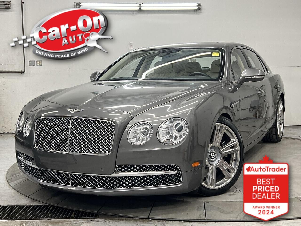 Flying Spur W12 IN STUNNING GRANITE OVER LINEN & BELUGA HIDES! ONLY 38,000KMS!!! Exhilarating 616HP/ 0-60mph in 4.3s while sitting in one of the world&rsquo;s most luxurious sedans. Upgrades include premium Mulliner 21-inch wheels, contrast stitching, embroidered seat emblems, veneered rear picnic tables, High gloss Piano black wood accents, Bright Chrome lower matrix grille as well as front and rear massage seats. This Elegant Spur is not your usual Black or White V8 model. It is VERY well appointed and definitely oozes opulence and sophistication. Unless you&rsquo;ve driven a W12 New Gen Bentley you cannot appreciate this unique automobile. We would love to show you this gem! Please call to set-up your preview visit.