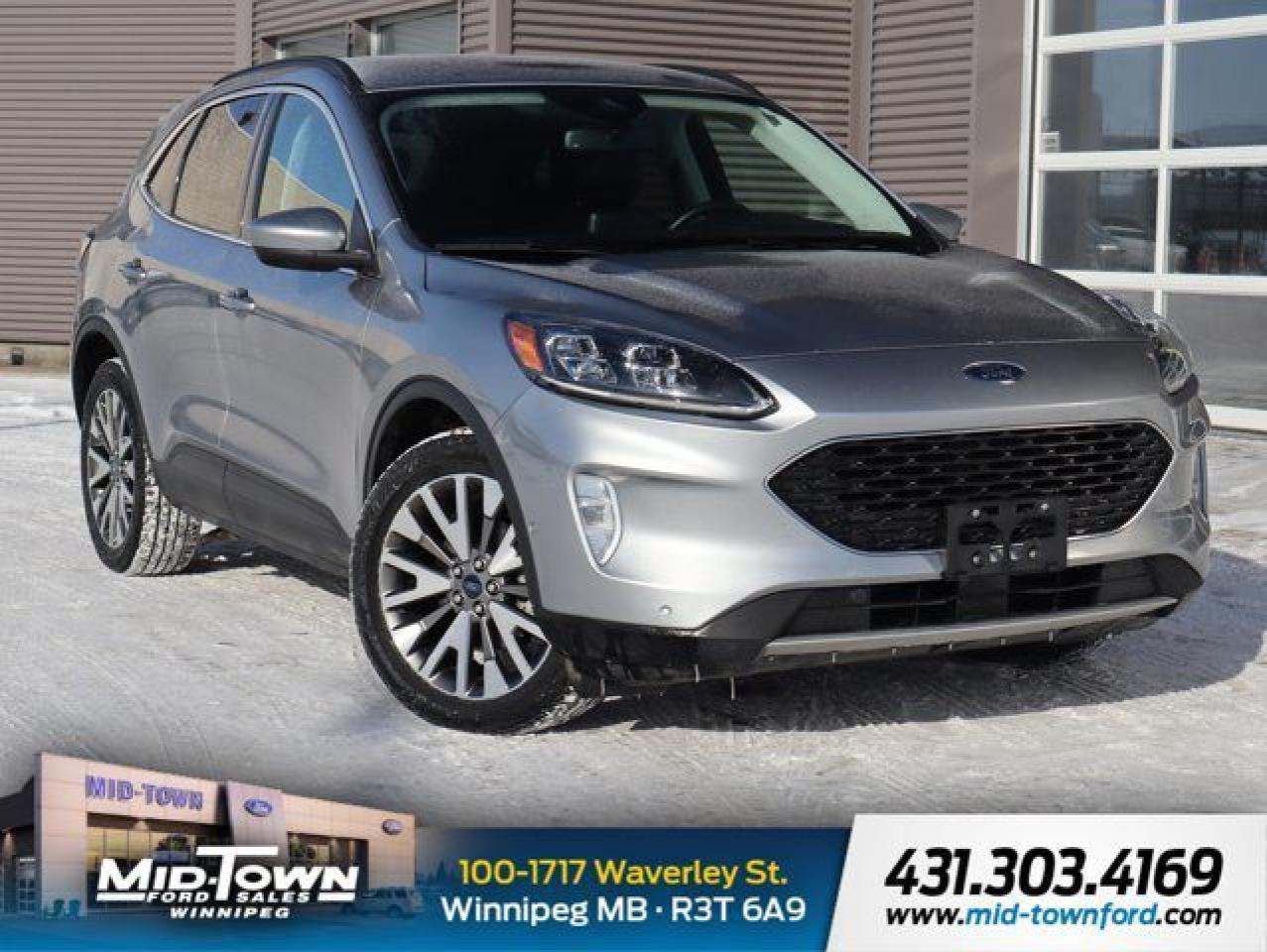 Recent Arrival!<br /><br />| Clean Carfax, | Non Smoker, | Apple Carplay, | Android Auto, 2.5L iVCT, eCVT, AWD, 10 Speakers, 2.91 Axle Ratio, 4-Wheel Disc Brakes, ABS brakes, Air Conditioning, Alloy wheels, AM/FM radio: SiriusXM, Auto High-beam Headlights, Auto-dimming Rear-View mirror, Automatic temperature control, Block heater, Brake assist, Bumpers: body-colour, Compass, Delay-off headlights, Driver door bin, Driver vanity mirror, Dual front impact airbags, Dual front side impact airbags, Electronic Fuel Door Release, Electronic Stability Control, Emergency communication system: SYNC 3 911 Assist, Equipment Group 400A, Four wheel independent suspension, Front anti-roll bar, Front Bucket Seats, Front dual zone A/C, Front fog lights, Front reading lights, Fully automatic headlights, Garage door transmitter, HD Radio, Heated ActiveX Material Sport Contour Bucket Seats, Heated door mirrors, Heated front seats, Heated steering wheel, Illuminated entry, Knee airbag, Lane Departure Warning System, License Plate Bracket, Low tire pressure warning, Memory seat, Navigation System, Neutral Towing Capability, Occupant sensing airbag, Outside temperature display, Overhead airbag, Overhead console, Panic alarm, Passenger door bin, Passenger vanity mirror, Pedestrian Alert Sounder, Power door mirrors, Power driver seat, Power Liftgate, Power passenger seat, Power steering, Power windows, Radio data system, Radio: B&O Sound System by Bang & Olufsen w/SiriusXM, Rain sensing wipers, Rear anti-roll bar, Rear reading lights, Rear window defroster, Rear window wiper, Remote keyless entry, Roof rack: rails only, Security system, Speed control, Speed-sensing steering, Speed-Sensitive Wipers, Split folding rear seat, Spoiler, Steering wheel mounted audio controls, SYNC 3 Communications & Entertainment System, SYNC 3/Apple CarPlay/Android Auto, Telescoping steering wheel, Tilt steering wheel, Traction control, Trip computer, Variably intermittent wipers, Wheels: 19 Machined-Face Aluminum.<br /><br />Odometer is 1633 kilometers below market average! Silver Metallic 2021 Ford Escape Titanium Hybrid AWD 2.5L iVCT eCVT<br /><br /><br />For further information please contact MidTown Ford sales department directly at 204-284-7650. Dealer #9695.