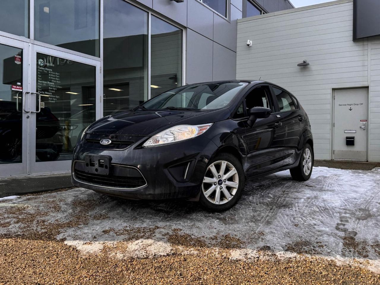Our great looking 2012 Ford Fiesta SE is shown off in Tuxedo Black Metallic! Its powered by a 1.6 Liter 4 Cylinder engine that produces 120 horsepower while paired with a 6-Speed automatic transmission. Its absolutely stunning with halogen headlights and bug deflector. It also comes with a second set of tires and rims.Inside our SE, open the door tofind a world of comfort and convenience! Settle into cloth seating, and grip the steering wheel with mounted audio/cruise controls, and look up to see a power sunroof. Its also equipped with front heated seats, AM/FM/CD radio that has USB/AUX inputs for mobile devices, stay connected with the Bluetooth hands-free phone system and crank those tunes through the impressive 4 speaker sound system.Our Ford will give you peace of mind with its wide variety of safety features that include daytime running lights, dusk sensing headlights, stability/traction control, an immense amount of airbags and more!Print this page and call us Now... We Know You Will Enjoy Your Test Drive Towards Ownership! We look forward to showing you why Go Mazda is the best place for all your automotive needs.Go Mazda is an AMVIC licensed business.Please note: this vehicle was previously used as a Rental.