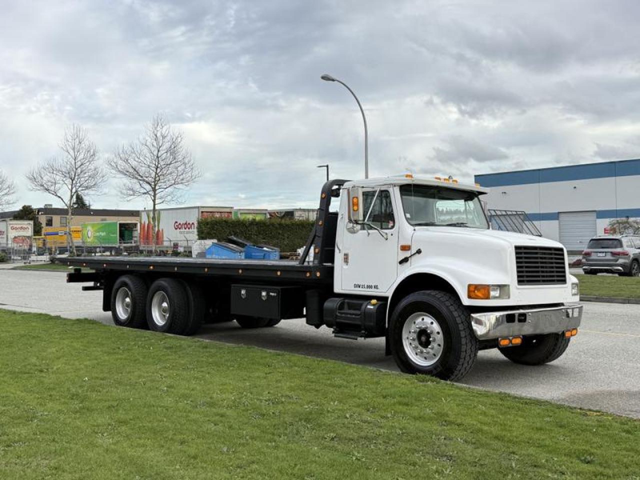 Used 2000 International 4900 25 Foot Roll-Off Flat Deck Tow Truck Manual Diesel Air Brakes for sale in Burnaby, BC