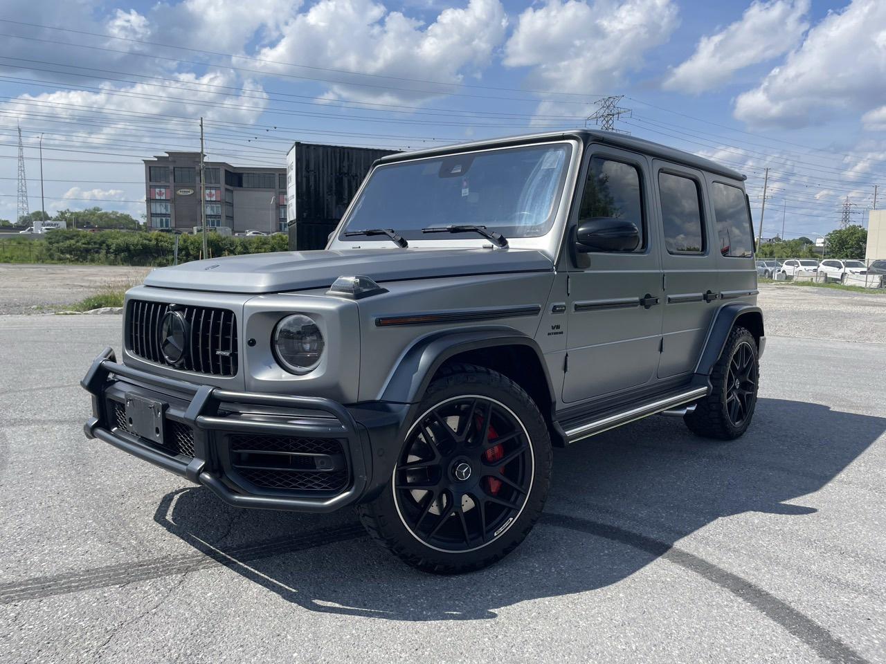 <p>The 2021 Mercedes-Benz AMG G63 is an iconic luxury SUV that blends handcrafted performance with unmistakable design and cutting-edge technology. Powered by a handcrafted 4.0L AMG twin-turbocharged V8 engine paired with an AMG SPEEDSHIFT TCT 9-speed automatic transmission, it delivers an impressive 577 horsepower and 627 lb-ft of torque with the confidence of AMG Performance 4MATIC all-wheel drive. The exterior is defined by its bold and commanding presence, featuring the signature AMG-specific Panamericana grille, flared wheel arches, 20-inch AMG wheels, LED high-performance headlights, and a timeless boxy silhouette with distinctive side-exit exhaust pipes. Inside, the cabin offers an opulent driving experience with Nappa leather upholstery, heated and ventilated front and rear seats, AMG-specific sport steering wheel, dual 12.3-inch digital displays, Burmester surround sound system, ambient lighting, tri-zone automatic climate control, and a power panoramic sunroof. Advanced driver assistance features include adaptive cruise control, blind-spot monitoring, active lane-keeping assist, and a 360-degree camera system for superior confidence on every drive. Combining off-road capability with refined luxury, the 2021 Mercedes-Benz AMG G63 sets the standard for performance SUVs with a commanding presence and world-class craftsmanship.</p>