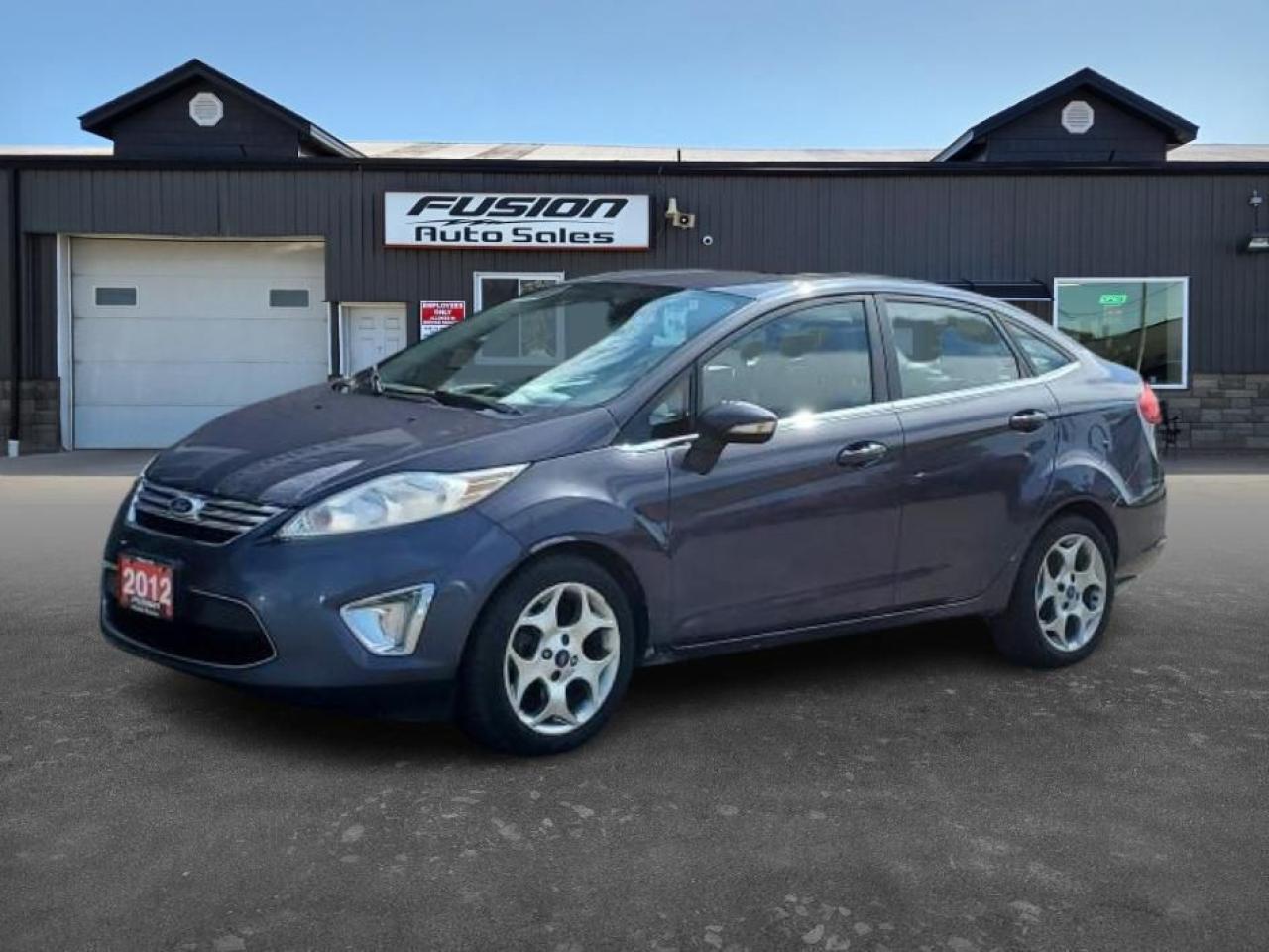 <p>Looking for a stylish and reliable sedan? Check out this 2012 Ford Fiesta SEL, available now at Fusion Auto Sales. This sleek gray Fiesta offers a comfortable ride with its four-door design and a practical front-wheel-drive system, making it perfect for navigating city streets or embarking on weekend getaways. Inside, youll find a sophisticated black leather interior that adds a touch of luxury to your daily commute. This well-maintained vehicle has 323,409 km on the odometer.</p><p>Under the hood, youll find a fuel-efficient V4 engine paired with a smooth automatic transmission, ensuring a pleasant and economical driving experience. The Fiesta SEL is designed to provide a balance of style, comfort, and practicality, making it an excellent choice for individuals and families alike.</p><p>Here are some of the standout features:</p><ul><li><strong>Premium Black Leather Interior:</strong> Experience ultimate comfort and a touch of luxury every time you get behind the wheel.</li><li><strong>Fuel-Efficient V4 Engine:</strong> Save money at the pumps with this economical and reliable engine.</li><li><strong>Automatic Transmission:</strong> Enjoy effortless driving with the smooth-shifting automatic transmission.</li><li><strong>Stylish Gray Exterior:</strong> Turn heads with the Fiestas modern and eye-catching exterior.</li><li><strong>Practical Sedan Design:</strong> Benefit from the convenience of four doors and ample space for passengers and cargo.</li></ul><p><strong><em>Powered by AutoIntelligence™</em></strong> Vehicle information has been generated using artificial intelligence and is provided for informational purposes only. While efforts are made to ensure accuracy, please confirm all details directly with the dealer.</p><p>The Fusion Philosophy<br /><br />At Fusion Auto Sales, we put more effort into buying our vehicles than we do trying to sell them. By constantly monitoring what other car lots are doing, we strive to be the lowest priced dealer in our market. We won’t purchase a vehicle to “fill a hole”. We know that the vehicles on our lot are great value for the money and smart shoppers realize that also. Adhering to this philosophy makes it easy for our customers. If they find a vehicle on our lot that fulfills their needs and wants, they know that they’re getting great value. <br /><br />If we don’t have what you’re looking for, we can find it! Over 150 customers have saved thousands of dollars buy joining our” locate club”. People that know what they want and what they want to pay (within reason of course), get the vehicle of their dreams and enjoy huge savings. Contact us for details.<br /><br /><br /><br />Fusion Auto Sales is in Tilbury, Ont. located between Windsor and London right off the 401. We are among 7 dealerships within a &frac12; kilometer distance which is great for out of town shoppers. We began satisfying customers in 2009 and have been doing so ever since. In 2012 Fusion was recognized as 1 of the 50 fastest growing companies in Canada. And then, in 2018, we were named one of the top 5 independent automobile dealerships in the country. <br /><br />We specialize in late model vehicles at below than average pricing, everything is fully certified and every unit is Car Proof verified and is fully disclosed with every unit. We offer every type of financing from perfect credit at great rates to credit challenges with competitive rates. We also specialize in locating vehicles for customers, we cant have everything on the lot so if you do not see it and are having a hard time finding what you are looking for, let us know and we can find it for you. Fusion Auto Sales spans its customer base from Windsor all the way to Timmins, On and every where in between. Our philosophy is You are going to like the way we deal and everyone does, straight honest answers with no monkey business and no back and forth between sales and managers.</p>