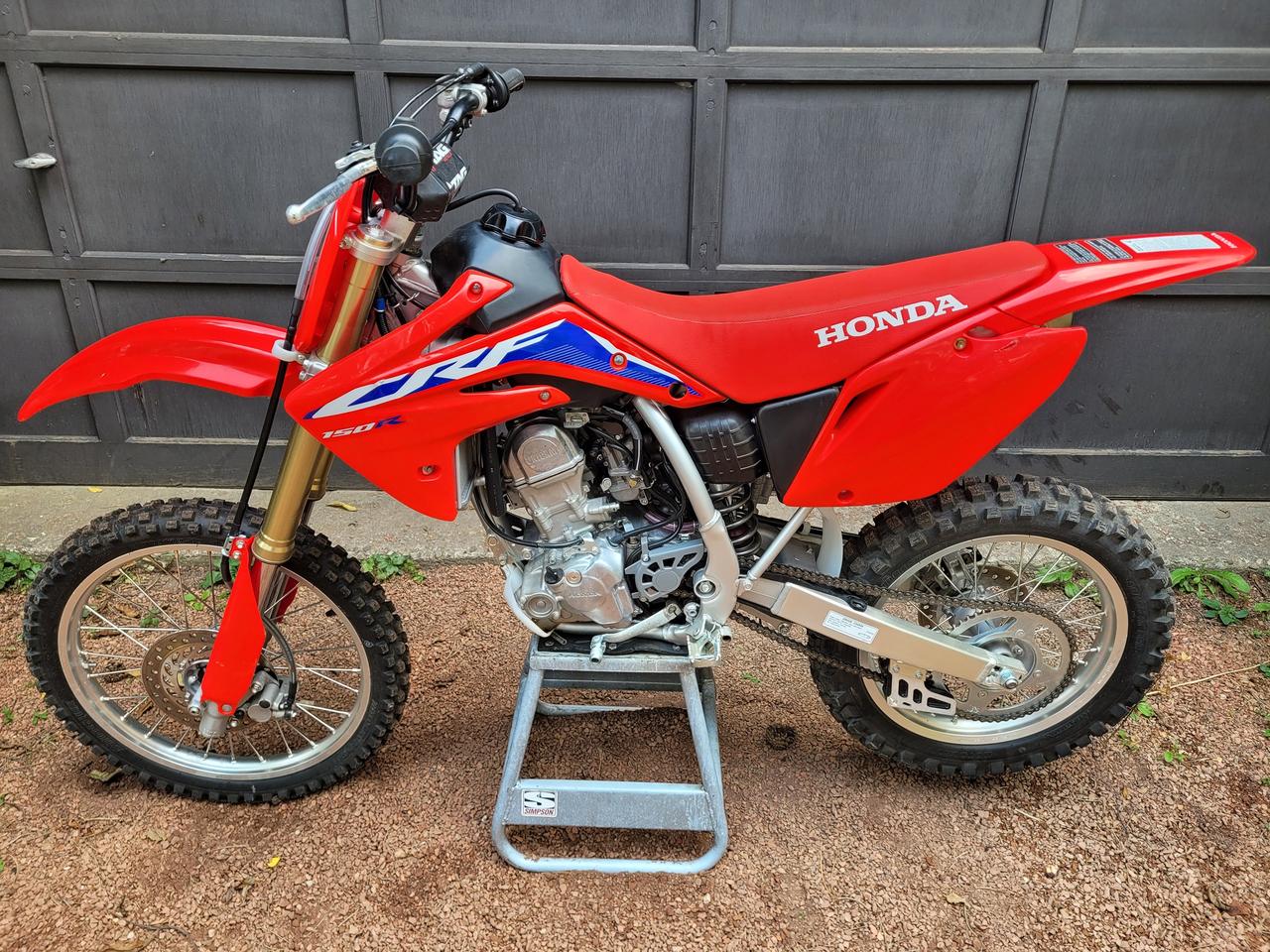 <p>BLACK FRIDAY SPECIAL</p><p>One Owner, Financing Available, Trade-ins Welcome!</p><p>The CRF150R is a competition dirt bike, and the CRF150RB (Expert) model is the larger, big wheel version. The Expert model has a longer wheelbase and slightly stiffer suspension, according to V1 Moto.</p><p>The 2023 Honda CRF150RB is a motocross bike featuring a 149.7cc liquid-cooled single-cylinder four-stroke engine, a Unicam SOHC four-valve cylinder head, and a 32mm Keihin flat-slide carburetor with a Throttle Position Sensor. It also has a close-ratio five-speed transmission, a 37mm leading-axle inverted Showa cartridge fork, and a Pro-Link Showa single shock.</p><p><span style=letter-spacing: 0px; background-color: #ffffff; color: #001d35; font-family: Google Sans, Arial, sans-serif; font-size: 18px;>Engine:</span></p><div class=WaaZC style=color: #001d35; font-family: Google Sans, Arial, sans-serif; font-size: 18px; background-color: #ffffff;><div class=RJPOee EIJn2 style=animation: auto ease 0s 1 normal none running none !important;><ul style=margin: 10px 0px 20px; padding: 0px; font-size: 16px; line-height: 22px; padding-inline-start: 24px; data-hveid=CA8QAQ data-ved=2ahUKEwjNjOTBq9aOAxWWhIkEHYfzHkkQm_YKegQIDxAB><li style=margin: 0px 0px 8px; padding: 0px 0px 0px 4px; list-style: inherit;><span data-huuid=18235111666923489577><strong>Type:</strong>&nbsp;</span><span data-huuid=18235111666923488016>149.7cc liquid-cooled single-cylinder four-stroke</span></li><li style=margin: 0px 0px 8px; padding: 0px 0px 0px 4px; list-style: inherit;><span data-huuid=18235111666923488990><strong>Valve Train:</strong>&nbsp;</span><span data-huuid=18235111666923487429>Unicam SOHC, four valves per cylinder</span></li><li style=margin: 0px 0px 8px; padding: 0px 0px 0px 4px; list-style: inherit;><span data-huuid=18235111666923488403><strong>Bore and Stroke:</strong>&nbsp;</span><span data-huuid=18235111666923490938>66mm x 43.8mm</span></li><li style=margin: 0px 0px 8px; padding: 0px 0px 0px 4px; list-style: inherit;><span data-huuid=18235111666923487816><strong>Compression Ratio:</strong>&nbsp;</span><span data-huuid=18235111666923490351>11.7:1</span></li><li style=margin: 0px; padding: 0px 0px 0px 4px; list-style: inherit;><span data-huuid=18235111666923491325><strong>Induction:</strong>&nbsp;</span><span data-huuid=18235111666923489764><span data-huuid=18235111666923489764>32mm Keihin flat-slide carburetor with Throttle Position Sensor (TPS)<span class=pjBG2e data-cid=51916ef2-197b-4272-89b4-bcd2b5c86afa><span class=UV3uM style=text-wrap-mode: nowrap;>&nbsp;</span></span></span></span><div class=NPrrbc style=margin-inline-end: 6px; display: inline-flex; data-cid=51916ef2-197b-4272-89b4-bcd2b5c86afa data-uuids=18235111666923489577,18235111666923488016,18235111666923488990,18235111666923487429,18235111666923488403,18235111666923490938,18235111666923487816,18235111666923490351,18235111666923491325,18235111666923489764><div class=BMebGe btku5b fCrZyc LwdV0e FR7ZSc qVhvac OJeuxf style=display: inline-block; vertical-align: middle; cursor: pointer; outline: 0px; -webkit-tap-highlight-color: transparent; color: #0b57d0; tabindex=0 role=button aria-label=View related links data-hveid=CBwQAQ data-ved=2ahUKEwjNjOTBq9aOAxWWhIkEHYfzHkkQ3fYKegQIHBAB><div class=niO4u style=display: flex; -webkit-box-pack: center; justify-content: center; position: relative; -webkit-box-align: stretch; align-items: stretch; width: 28px; border-radius: 9999px; background-color: transparent; margin: 0px auto; outline: transparent solid 1px; outline-offset: -1px; height: 20px; min-height: 20px;><div class=kHtcsd style=display: flex; -webkit-box-align: center; align-items: center; -webkit-box-pack: center; justify-content: center; width: 28px; border-radius: 9999px; height: 20px;>&nbsp;</div></div></div></div></li></ul></div></div><div class=WaaZC style=color: #001d35; font-family: Google Sans, Arial, sans-serif; font-size: 18px; background-color: #ffffff;><div class=RJPOee EIJn2 style=animation: auto ease 0s 1 normal none running none !important;><div class=rPeykc pyPiTc style=margin: 20px 0px 10px; letter-spacing: 0px; line-height: 26px; data-hveid=CCMQAQ data-ved=2ahUKEwjNjOTBq9aOAxWWhIkEHYfzHkkQo_EKegQIIxAB><span data-huuid=14990943468675938596>Transmission:</span></div></div></div><div class=WaaZC style=color: #001d35; font-family: Google Sans, Arial, sans-serif; font-size: 18px; background-color: #ffffff;><div class=RJPOee EIJn2 style=animation: auto ease 0s 1 normal none running none !important;><ul style=margin: 10px 0px 20px; padding: 0px; font-size: 16px; line-height: 22px; padding-inline-start: 24px; data-hveid=CCYQAQ data-ved=2ahUKEwjNjOTBq9aOAxWWhIkEHYfzHkkQm_YKegQIJhAB><li style=margin: 0px 0px 8px; padding: 0px 0px 0px 4px; list-style: inherit;><span data-huuid=14990943468675939999><strong>Type:</strong>&nbsp;</span><span data-huuid=14990943468675937736>Close-ratio five-speed</span></li><li style=margin: 0px; padding: 0px 0px 0px 4px; list-style: inherit;><span data-huuid=14990943468675937306><strong>Final Drive:</strong>&nbsp;</span><span data-huuid=14990943468675939139>#420 chain;&nbsp;</span><span data-huuid=14990943468675936876>15T/50T<span class=pjBG2e data-cid=454196fe-8813-4bc2-9aa7-d79d30c6590f><span class=UV3uM style=text-wrap-mode: nowrap;>&nbsp;</span></span></span></li><li style=margin: 0px; padding: 0px 0px 0px 4px; list-style: inherit;><div class=WaaZC style=font-size: 18px; text-wrap-mode: wrap;><div class=RJPOee EIJn2 style=animation: auto ease 0s 1 normal none running none !important;><div class=rPeykc pyPiTc style=margin: 20px 0px 10px; letter-spacing: 0px; line-height: 26px; data-hveid=CC8QAQ data-ved=2ahUKEwjNjOTBq9aOAxWWhIkEHYfzHkkQo_EKegQILxAB><span data-huuid=5267886913820037788>Suspension:</span></div></div></div><div class=WaaZC style=font-size: 18px; text-wrap-mode: wrap;><div class=RJPOee EIJn2 style=animation: auto ease 0s 1 normal none running none !important;><ul style=margin: 10px 0px 20px; padding: 0px; font-size: 16px; line-height: 22px; padding-inline-start: 24px; data-hveid=CDcQAQ data-ved=2ahUKEwjNjOTBq9aOAxWWhIkEHYfzHkkQm_YKegQINxAB><li class=K3KsMc style=margin: 0px 0px 8px; padding: 0px 0px 0px 4px; list-style-position: inherit; list-style-image: inherit; list-style-type: none;><div class=zMgcWd dSKvsb style=padding-bottom: 0px; padding-top: 0px; border-bottom: none; margin-inline-start: -28px; data-il=><div data-crb-p=><div class=xFTqob style=flex: 1 1 0%; min-width: 0px;><div class=Gur8Ad style=line-height: 22px; overflow: hidden; padding-bottom: 4px; transition: transform 200ms cubic-bezier(0.2, 0, 0, 1);><span data-huuid=5267886913820040509><strong>Front:</strong></span></div><div class=vM0jzc style=color: #545d7e; letter-spacing: 0.1px; line-height: 22px;><span data-huuid=5267886913820037320>37mm leading-axle inverted Showa cartridge fork with rebound- and compression-damping adjustability;&nbsp;</span><span data-huuid=5267886913820038227>10.8-inch travel</span></div></div></div></div></li><li class=K3KsMc style=margin: 0px; padding: 0px 0px 0px 4px; list-style-position: inherit; list-style-image: inherit; list-style-type: none;><div class=zMgcWd dSKvsb style=padding-bottom: 0px; padding-top: 8px; border-bottom: none; margin-inline-start: -28px; data-il=><div data-crb-p=><div class=xFTqob style=flex: 1 1 0%; min-width: 0px;><div class=Gur8Ad style=line-height: 22px; overflow: hidden; padding-bottom: 4px; transition: transform 200ms cubic-bezier(0.2, 0, 0, 1);><span data-huuid=5267886913820040041><strong>Rear:</strong></span></div><div class=vM0jzc style=color: #545d7e; letter-spacing: 0.1px; line-height: 22px;><span data-huuid=5267886913820040948>Pro-Link Showa single shock with spring-preload, rebound- and compression-damping adjustability;&nbsp;</span><span data-huuid=5267886913820037759><span data-huuid=5267886913820037759>10.7-inch travel<span class=pjBG2e data-cid=8c62aa95-e82a-44bb-8005-c342b5205c45><span class=UV3uM style=text-wrap-mode: nowrap;>&nbsp;</span></span></span></span><div class=NPrrbc style=margin-inline-end: 6px; display: inline-flex; data-cid=8c62aa95-e82a-44bb-8005-c342b5205c45 data-uuids=5267886913820040509,5267886913820037320,5267886913820038227,5267886913820040041,5267886913820040948,5267886913820037759><div class=BMebGe btku5b fCrZyc LwdV0e FR7ZSc qVhvac OJeuxf style=display: inline-block; vertical-align: middle; cursor: pointer; outline: 0px; -webkit-tap-highlight-color: transparent; color: #0b57d0; tabindex=0 role=button aria-label=View related links data-hveid=CDgQAQ data-ved=2ahUKEwjNjOTBq9aOAxWWhIkEHYfzHkkQ3fYKegQIOBAB><div class=niO4u style=display: flex; -webkit-box-pack: center; justify-content: center; position: relative; -webkit-box-align: stretch; align-items: stretch; width: 28px; border-radius: 9999px; background-color: transparent; margin: 0px auto; outline: transparent solid 1px; outline-offset: -1px; height: 20px; min-height: 20px;><div class=kHtcsd style=display: flex; -webkit-box-align: center; align-items: center; -webkit-box-pack: center; justify-content: center; width: 28px; border-radius: 9999px; height: 20px;>&nbsp;</div></div></div></div></div></div></div></div></li></ul></div></div><div class=WaaZC style=font-size: 18px; text-wrap-mode: wrap;><div class=RJPOee EIJn2 style=animation: auto ease 0s 1 normal none running none !important;><div class=rPeykc pyPiTc style=margin: 20px 0px 10px; letter-spacing: 0px; line-height: 26px; data-hveid=CD4QAQ data-ved=2ahUKEwjNjOTBq9aOAxWWhIkEHYfzHkkQo_EKegQIPhAB><span data-huuid=5267886913820039983>Brakes:</span></div></div></div><div class=WaaZC style=font-size: 18px; text-wrap-mode: wrap;><div class=RJPOee EIJn2 style=animation: auto ease 0s 1 normal none running none !important;><ul style=margin: 10px 0px 20px; padding: 0px; font-size: 16px; line-height: 22px; padding-inline-start: 24px; data-hveid=CEYQAQ data-ved=2ahUKEwjNjOTBq9aOAxWWhIkEHYfzHkkQm_YKegQIRhAB><li style=margin: 0px 0px 8px; padding: 0px 0px 0px 4px; list-style: inherit;><span data-huuid=5267886913820038608><strong>Front:</strong>&nbsp;</span><span data-huuid=5267886913820039515>Single 220mm disc</span></li><li style=margin: 0px; padding: 0px 0px 0px 4px; list-style: inherit;><span data-huuid=5267886913820037233><strong>Rear:</strong>&nbsp;</span><span data-huuid=5267886913820038140><span data-huuid=5267886913820038140>Single 190mm disc<span class=pjBG2e data-cid=d2b153ed-77a9-4b2c-b310-172974b465d7><span class=UV3uM style=text-wrap-mode: nowrap;>&nbsp;</span></span></span></span><div class=NPrrbc style=margin-inline-end: 6px; display: inline-flex; data-cid=d2b153ed-77a9-4b2c-b310-172974b465d7 data-uuids=5267886913820038608,5267886913820039515,5267886913820037233,5267886913820038140><div class=BMebGe btku5b fCrZyc LwdV0e FR7ZSc qVhvac OJeuxf style=display: inline-block; vertical-align: middle; cursor: pointer; outline: 0px; -webkit-tap-highlight-color: transparent; color: #0b57d0; tabindex=0 role=button aria-label=View related links data-hveid=CEQQAQ data-ved=2ahUKEwjNjOTBq9aOAxWWhIkEHYfzHkkQ3fYKegQIRBAB><div class=niO4u style=display: flex; -webkit-box-pack: center; justify-content: center; position: relative; -webkit-box-align: stretch; align-items: stretch; width: 28px; border-radius: 9999px; background-color: transparent; margin: 0px auto; outline: transparent solid 1px; outline-offset: -1px; height: 20px; min-height: 20px;><div class=kHtcsd style=display: flex; -webkit-box-align: center; align-items: center; -webkit-box-pack: center; justify-content: center; width: 28px; border-radius: 9999px; height: 20px;>&nbsp;</div></div></div></div></li></ul></div></div><div class=WaaZC style=font-size: 18px; text-wrap-mode: wrap;><div class=RJPOee EIJn2 style=animation: auto ease 0s 1 normal none running none !important;><div class=rPeykc pyPiTc style=margin: 20px 0px 10px; letter-spacing: 0px; line-height: 26px; data-hveid=CEoQAQ data-ved=2ahUKEwjNjOTBq9aOAxWWhIkEHYfzHkkQo_EKegQIShAB><span data-huuid=10715868409519168202>Wheels and Tires:</span></div></div></div><div class=WaaZC style=font-size: 18px; text-wrap-mode: wrap;><div class=RJPOee EIJn2 style=animation: auto ease 0s 1 normal none running none !important;><ul style=margin: 10px 0px 20px; padding: 0px; font-size: 16px; line-height: 22px; padding-inline-start: 24px; data-hveid=CFQQAQ data-ved=2ahUKEwjNjOTBq9aOAxWWhIkEHYfzHkkQm_YKegQIVBAB><li style=margin: 0px 0px 8px; padding: 0px 0px 0px 4px; list-style: inherit;><span data-huuid=10715868409519167295><strong>Front:</strong>&nbsp;</span><span data-huuid=10715868409519168358>Dunlop MX51;&nbsp;</span><span data-huuid=10715868409519169421>70/100-19</span></li><li style=margin: 0px; padding: 0px 0px 0px 4px; list-style: inherit;><span data-huuid=10715868409519167451><strong>Rear:</strong>&nbsp;</span><span data-huuid=10715868409519168514>Dunlop MX51;&nbsp;</span><span data-huuid=10715868409519165481><span data-huuid=10715868409519165481>90/100-16<span class=pjBG2e data-cid=c1bd7d61-0b52-4109-b09b-2e82b362a695><span class=UV3uM style=text-wrap-mode: nowrap;>&nbsp;</span></span></span></span><div class=NPrrbc style=margin-inline-end: 6px; display: inline-flex; data-cid=c1bd7d61-0b52-4109-b09b-2e82b362a695 data-uuids=10715868409519167295,10715868409519168358,10715868409519169421,10715868409519167451,10715868409519168514,10715868409519165481><div class=BMebGe btku5b fCrZyc LwdV0e FR7ZSc qVhvac OJeuxf style=display: inline-block; vertical-align: middle; cursor: pointer; outline: 0px; -webkit-tap-highlight-color: transparent; color: #0b57d0; tabindex=0 role=button aria-label=View related links data-hveid=CFMQAQ data-ved=2ahUKEwjNjOTBq9aOAxWWhIkEHYfzHkkQ3fYKegQIUxAB><div class=niO4u style=display: flex; -webkit-box-pack: center; justify-content: center; position: relative; -webkit-box-align: stretch; align-items: stretch; width: 28px; border-radius: 9999px; background-color: transparent; margin: 0px auto; outline: transparent solid 1px; outline-offset: -1px; height: 20px; min-height: 20px;><div class=kHtcsd style=display: flex; -webkit-box-align: center; align-items: center; -webkit-box-pack: center; justify-content: center; width: 28px; border-radius: 9999px; height: 20px;>&nbsp;</div></div></div></div></li></ul></div></div><div class=WaaZC style=font-size: 18px; text-wrap-mode: wrap;><div class=RJPOee EIJn2 style=animation: auto ease 0s 1 normal none running none !important;><div class=rPeykc pyPiTc style=margin: 20px 0px 10px; letter-spacing: 0px; line-height: 26px; data-hveid=CF0QAQ data-ved=2ahUKEwjNjOTBq9aOAxWWhIkEHYfzHkkQo_EKegQIXRAB><span data-huuid=3008760023406144765>Dimensions:</span></div></div></div><div class=WaaZC style=font-size: 18px; text-wrap-mode: wrap;><div class=RJPOee EIJn2 style=animation: auto ease 0s 1 normal none running none !important;><ul style=margin: 10px 0px 20px; padding: 0px; font-size: 16px; line-height: 22px; padding-inline-start: 24px; data-hveid=CHQQAQ data-ved=2ahUKEwjNjOTBq9aOAxWWhIkEHYfzHkkQm_YKegQIdBAB><li style=margin: 0px 0px 8px; padding: 0px 0px 0px 4px; list-style: inherit;><span data-huuid=3008760023406143998><strong>Rake:</strong>&nbsp;</span><span data-huuid=3008760023406142377>27.0&deg;</span></li><li style=margin: 0px 0px 8px; padding: 0px 0px 0px 4px; list-style: inherit;><span data-huuid=3008760023406143231><strong>Trail:</strong>&nbsp;</span><span data-huuid=3008760023406141610>3.8 inches</span></li><li style=margin: 0px 0px 8px; padding: 0px 0px 0px 4px; list-style: inherit;><span data-huuid=3008760023406142464><strong>Wheelbase:</strong>&nbsp;</span><span data-huuid=3008760023406144939>50.6 inches</span></li><li style=margin: 0px 0px 8px; padding: 0px 0px 0px 4px; list-style: inherit;><span data-huuid=3008760023406141697><strong>Seat Height:</strong>&nbsp;</span><span data-huuid=3008760023406144172>34.1 inches</span></li><li style=margin: 0px 0px 8px; padding: 0px 0px 0px 4px; list-style: inherit;><span data-huuid=3008760023406145026><strong>Ground Clearance:</strong>&nbsp;</span><span data-huuid=3008760023406143405>13.2 inches</span></li><li style=margin: 0px 0px 8px; padding: 0px 0px 0px 4px; list-style: inherit;><span data-huuid=3008760023406144259><strong>Curb Weight:</strong>&nbsp;</span><span data-huuid=3008760023406142638>187 pounds (includes all standard equipment, required fluids and full tank of fuel)</span></li><li style=margin: 0px; padding: 0px 0px 0px 4px; list-style: inherit;><span data-huuid=3008760023406143492><strong>Fuel Capacity:</strong>&nbsp;</span><span data-huuid=3008760023406141871>1.1 gallons<span class=pjBG2e data-cid=936d2f1b-ab52-430d-9dca-d93e5a5502e1><span class=UV3uM style=text-wrap-mode: nowrap;>&nbsp;</span></span></span></li><li style=margin: 0px; padding: 0px 0px 0px 4px; list-style: inherit;><div class=WaaZC style=font-size: 18px; text-wrap-mode: wrap;><div class=RJPOee EIJn2 style=animation: auto ease 0s 1 normal none running none !important;>&nbsp;</div></div></li></ul></div></div></li></ul></div></div><p>&nbsp;</p>