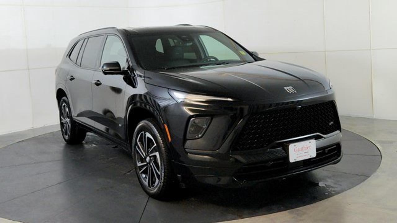 The 2026 Buick Enclave Sport Touring is a refined three-row midsize SUV that blends sporty design with premium comfort. It boasts distinctive Sport Touring touches---including a bold mesh grille, high-gloss black and machined 20-inch wheels, and exclusive ST badging---while integrating the segments largest screen: a sweeping 30-inch ultrawide display featuring Google built-in, wireless Apple CarPlay/Android Auto, and a Bose 12-speaker audio system. Under the hood, it uses a 2.5-liter turbocharged four-cylinder engine with an 8-speed automatic and all-wheel drive, delivering 328 hp and extensive safety tech, including HD Surround Vision, adaptive cruise control and enhanced automatic emergency braking. Added touches on this model include a panoramic sunroof, heads-up display and flat-folding second row seats.