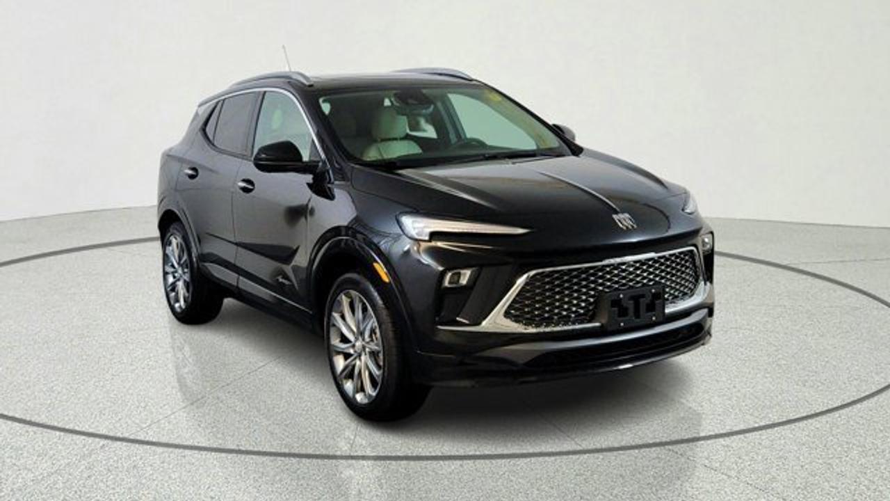 The 2026 Buick Encore GX Avenir elevates Buicks compact SUV to a new level of attainable luxury. Its exterior features distinctive Avenir styling---such as the Black Ice-finish grille, chrome beltline trim, clear-lens LED taillamps, and 19-inch Avenir Pearl Nickel alloy wheels---while the cabin includes perforated leather upholstery, heated power-adjustable front seats with driver memory, a heated steering wheel, a power-folding passenger seatback, auto-dimming rearview mirror, and a 120 V household-style outlet. Technology includes an 11-inch ultrawide touchscreen infotainment system paired with an 8-inch configurable driver display, wireless Apple CarPlay/Android Auto and Wi-Fi hotspot. This model also comes with a power moonroof, Rear Park Assist, HD Surround Vision and wireless charging. Under the hood, it is powered by a turbocharged 1.3 L three-cylinder engine paired with a nine-speed automatic transmission and standard all-wheel drive.