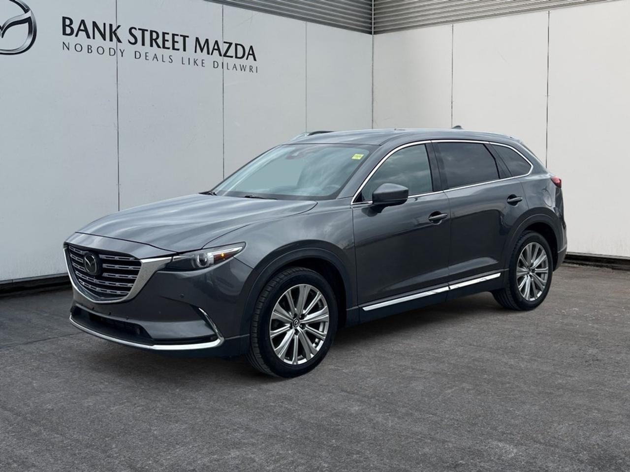 Unleash the road beneath you with the impressive performance of the 2021 Mazda CX-9 Signature in a sophisticated gray finish and all-wheel drive which provides exceptional handling across all terrains. This SUV is an epitome of elegant design, featuring sleek alloy wheels and a panoramic sunroof/moonroof, offering both comfort and style. Step inside to experience luxury at its best with premium leather seating, a leather steering wheel, and a modern leather/metal-look gear shifter. Both front and rear seats are heated for ultimate comfort, with cooled front seats to keep you refreshed. The CX-9 Signature enhances every journey with a head-up display and an advanced navigation system, ensuring you reach your destination with convenience. Stay connected with the smart device integration and enjoy crystal-clear sound through the satellite radio. Safety is paramount with features like lane assist, a backup camera, and parking sensors, facilitating a relaxed driving experience. Adaptive cruise control allows for an effortless drive on long journeys. If you are in search of a family-friendly vehicle that balances luxury and utility, then this SUV is designed for you. Contact us now to take this magnificent vehicle for a test drive and see why the Mazda CX-9 Signature is the ideal choice for discerning drivers. Get in touch with us for more details or to schedule a visit!