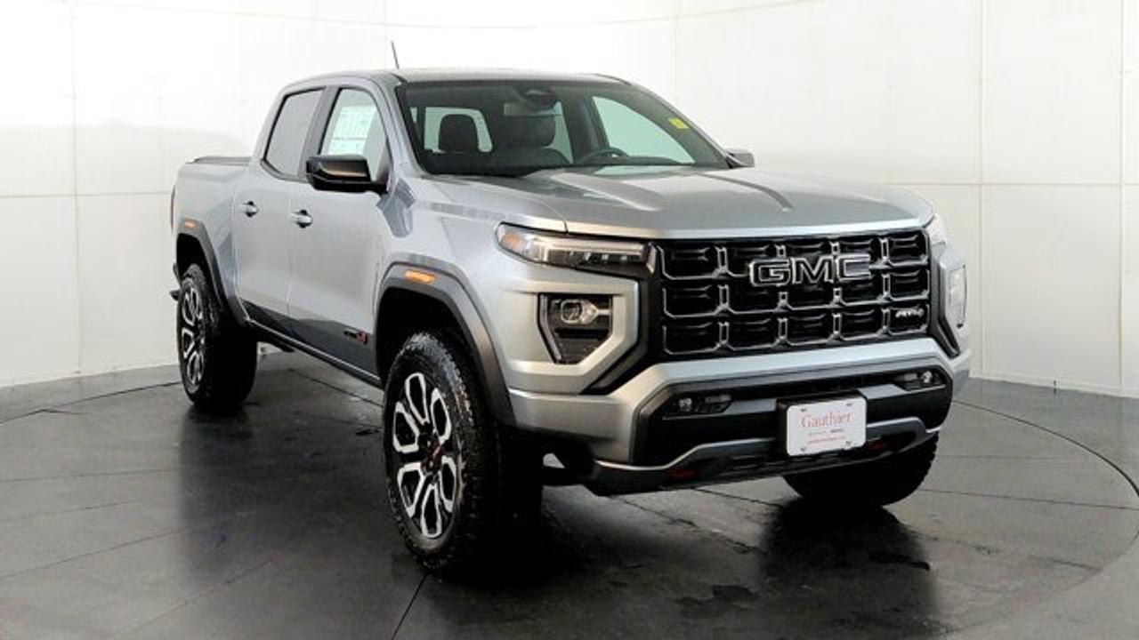 The 2026 GMC Canyon AT4 is an off-road-focused midsize pickup that comes standard with a 2-inch factory lift, an ultra-wide track, and 4WD equipped with a two-speed AutoTrac transfer case, automatic locking rear differential, and advanced Hill Descent Control. Under the hood, its powered by the potent TurboMax 2.7 L turbocharged inline-4 engine delivering 310 hp and 430 lb-ft of torque, with a max towing capacity of up to 7,700 lbs. Inside, the AT4 features a modern 11.3-inch center infotainment touchscreen, an 11-inch digital driver information display, leather heated and ventilated front seats and 20-inch wheels.