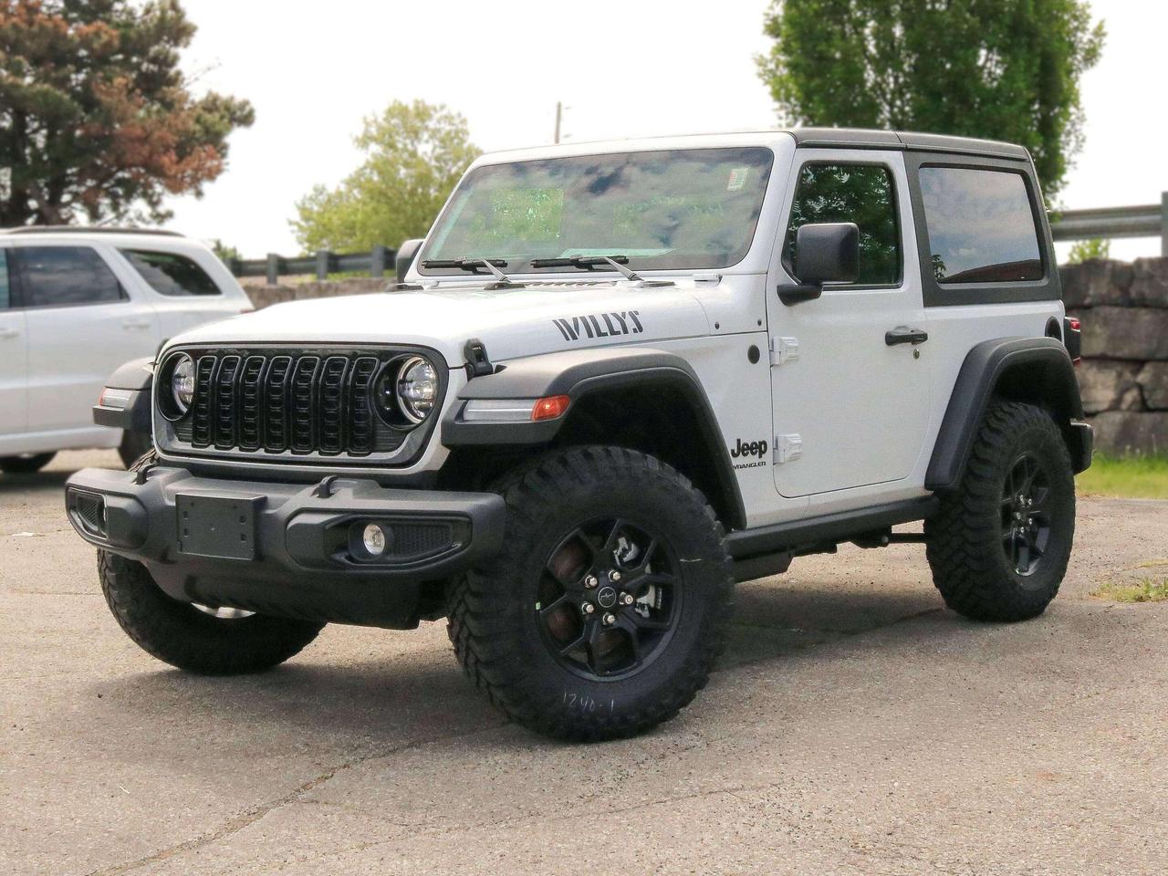 Our New 2026 Jeep Wrangler Willys 2 Door 4X4 with the Convenience Pack in Bright White rides with renowned capability that true adventurers love! Driven by a TurboCharged 2.0 Litre 4 Cylinder supplying 270hp to an 8 Speed Automatic transmission with an Off-Road Plus mode for enhanced trail performance. Dana axles and an electronic locking rear differential help you conquer almost any conditions, and this Four Wheel Drive SUV returns approximately 10.2L/100km on the highway. Eye-catching Willys hood graphics help our Wrangler grab attention with LED lighting, fog lamps, alloy wheels, fender flares, a sport bar, and a fantastic open-air driving experience when you drop the top, fold down the Gorilla Glass windshield, and remove the doors!  Thanks to our Convenience Pack, you can feel good with the top up or down in our Willys cabin. It bundles heated cloth seats, a heated-wrapped steering wheel, automatic climate control, remote start, and a 7-inch driver display for better driving. Uconnect&reg; technology powers your infotainment system to enjoy a 12.3-inch touchscreen, 3.5-inch driver display, Apple CarPlay&reg;, WiFi compatibility, Android Auto&reg;, Bluetooth&reg;, and an eight-speaker audio system.  Stay safe as you dominate your days, knowing Jeep has your back with automatic braking, adaptive cruise control, a rearview camera, forward collision warning, trailer sway damping, hill start assistance, and more. The world awaits, and our Wrangler Willys is ready to go! Save this Page and Call for Availability. We Know You Will Enjoy Your Test Drive Towards Ownership!