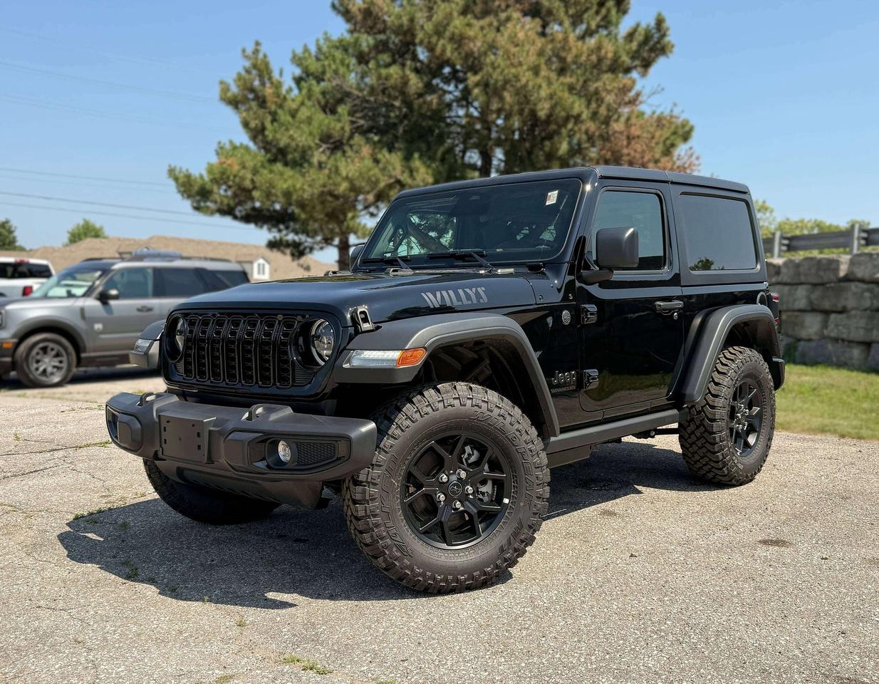 From its bold stance to its go-anywhere capability, our New 2026 Jeep Wrangler Willys 2 Door 4X4 with the Convenience Pack in Black invites you to explore without limits! Driven by a TurboCharged 2.0 Litre 4 Cylinder supplying 270hp to an 8 Speed Automatic transmission with an Off-Road Plus mode for enhanced trail performance. Dana axles and an electronic locking rear differential help you conquer almost any conditions, and this Four Wheel Drive SUV returns approximately 10.2L/100km on the highway. Eye-catching Willys hood graphics help our Wrangler grab attention with LED lighting, fog lamps, alloy wheels, fender flares, a sport bar, and a fantastic open-air driving experience when you drop the top, fold down the Gorilla Glass windshield, and remove the doors!  Thanks to our Convenience Pack, you can feel good with the top up or down in our Willys cabin. It bundles heated cloth seats, a heated-wrapped steering wheel, automatic climate control, remote start, and a 7-inch driver display for better driving. Uconnect&reg; technology powers your infotainment system to enjoy a 12.3-inch touchscreen, 3.5-inch driver display, Apple CarPlay&reg;, WiFi compatibility, Android Auto&reg;, Bluetooth&reg;, and an eight-speaker audio system.  Stay safe as you dominate your days, knowing Jeep has your back with automatic braking, adaptive cruise control, a rearview camera, forward collision warning, trailer sway damping, hill start assistance, and more. The world awaits, and our Wrangler Willys is ready to go! Save this Page and Call for Availability. We Know You Will Enjoy Your Test Drive Towards Ownership!