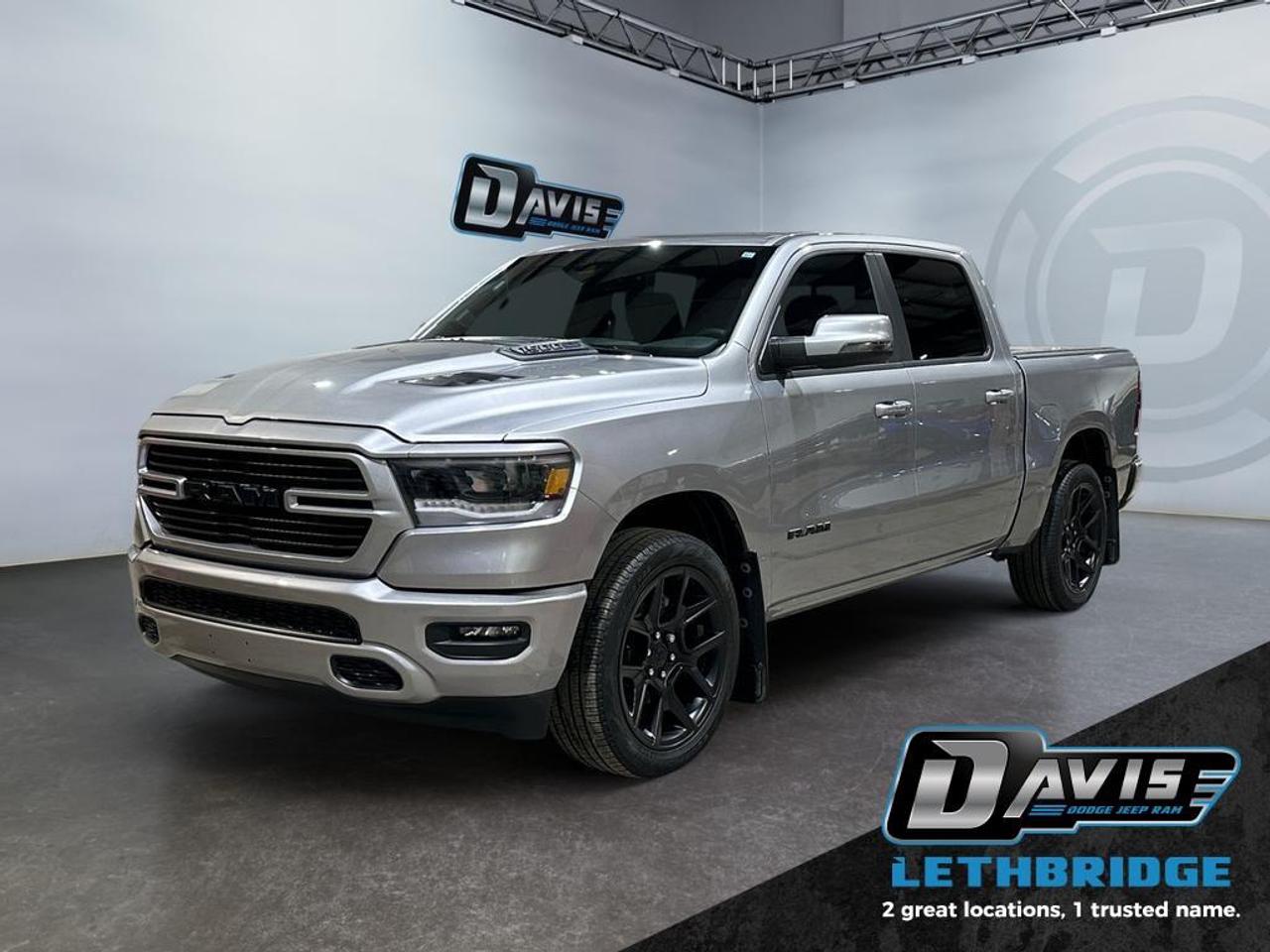 <b>5.7L Hemi - Hard Tonneau Cover - Remote Start - 12" Screen - 3.92 Rear Towing - Sport Hood - 22" Wheels <br /> <br /></b><br /> Whether you need tough and rugged capability, or soft and comfortable luxury, this 2023 Ram delivers every time. This 2023 Ram 1500 is for sale today in Lethbridge. <br /> <br />The Ram 1500's unmatched luxury transcends traditional pickups without compromising its capability. Loaded with best-in-class features, it's easy to see why the Ram 1500 is so popular. With the most towing and hauling capability in a Ram 1500, as well as improved efficiency and exceptional capability, this truck has the grit to take on any task. This low mileage Crew Cab 4X4 pickup has just 22,170 km. Stock number 40882 is Silver in colour. It has an Automatic transmission and is powered by a 395HP 5.7L 8 Cylinder Engine. <br /> <br /> Our 1500's trim level is Sport. This RAM 1500 Sport throws in some great comforts such as power-adjustable heated front seats with lumbar support, dual-zone climate control, power-adjustable pedals, deluxe sound insulation, and a heated leather-wrapped steering wheel. Connectivity is handled by an upgraded 12-inch display powered by Uconnect 5W with inbuilt navigation, mobile internet hotspot access, smart device integration, and a 10-speaker audio setup. Additional features include power folding exterior mirrors, a power rear window with defrosting, a trailer wiring harness, heavy-duty suspension, cargo box lighting, and a locking tailgate. This vehicle has been upgraded with the following features: Navigation, Heated Seats, 4G Wi-Fi, Heated Steering Wheel, Forward Collision Alert, Climate Control, Aluminum Wheels.<br /> <br />To apply right now for financing use this link: <a href=https://www.bridgecitychrysler.com/pre-approval/ target=_blank rel=nofollow noopener noreferrer>https://www.bridgecitychrysler.com/pre-approval/</a><br /><br /> <br /><br />Locally Owned & Trusted for Over 35 Years  Bridge City Chrysler in Lethbridge, AB <br /><br /> At Bridge City Chrysler, weve proudly served the Lethbridge community for more than 35 years, offering an unparalleled car buying experience. Dont just take our word for itour Google reviews speak volumes about our commitment to exceptional service. <br /><br /> Delivery & At-Home Test Drives: Convenient options to suit your lifestyle. <br /><br /> Flexible Financing for Everyone: Get the vehicle you need with financing solutions tailored to your situation. <br /><br /> Full Mechanical Inspections & Professional Cleaning: Every vehicle is thoroughly inspected and cleaned before it hits our lot.<br /><br /> We take all makes and models on trade and offer competitive pricing with inventory that changes daily. Whether you're shopping for a Chrysler, Dodge, Jeep, RAM, or FIAT, our AMVIC Licensed dealership makes it easy to browse, buy, and drive away.<br /><br /> Located in Lethbridge, AB, we proudly serve customers in Fort Macleod, Taber, Claresholm, and Coaldale. Shop online or visit us today to experience the best in sales, service, and selection. Standard bank rates apply; taxes are additional.<br /><br /> Vehicle pricing offer shown expires 2026-01-31. <br /> Come by and check out our fleet of 80+ used cars and trucks and 130+ new cars and trucks for sale in Lethbridge. o~o