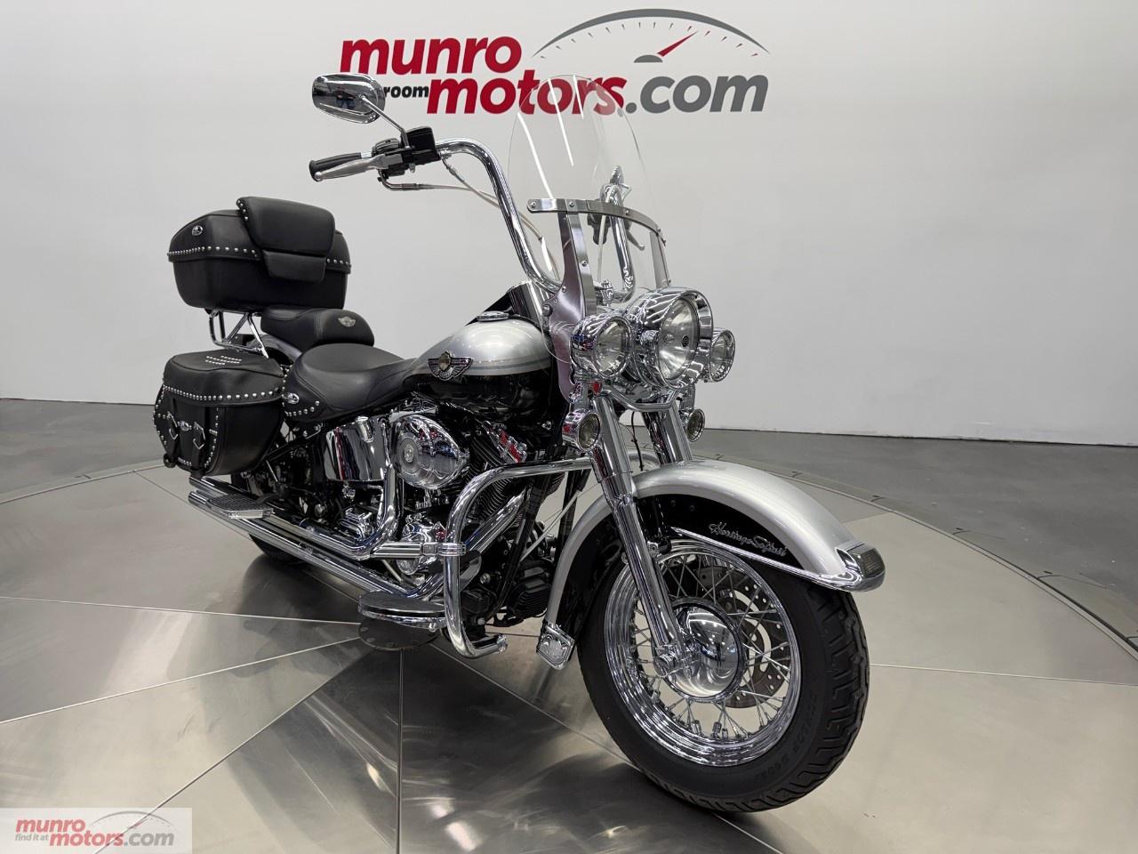 Vehicle Highlights include: 100th Anniversary Edition, Two-Tone Sterling Silver & Vivid Black, Vance & Hines Long Shots, Removeable Windshield, Removeable Passenger Backrest, Removeable Heritage Style Leather Tour Pack, Leather Saddle Bags, Braided Cables, Ape Hanger Bars, Nostalgic Grips, LED Lighting, Chrome Forks, Vintage Style Floor Boards, Hiway Pegs, & many Chrome Extras. <br /><br /> The 2003 Harley-Davidson Heritage Softail 100th Anniversary Edition is more than a motorcycleits a rolling tribute to a century of American craftsmanship, freedom, and tradition. Built to commemorate Harley-Davidsons 100th year, this special-edition Heritage Softail blends classic styling with modern reliability, making it one of the most meaningful and collectible cruisers of its era. <br /><br /> The Heritage Softail is known for its nostalgic design, and the 100th Anniversary Edition elevates it with exclusive details that set it apart. From the chrome-laced wheels and full fender valances to the Blackwell tires and leather saddlebags, every element reflects Harley-Davidsons deep-rooted touring heritage. <br /><br /> The factory Sterling Silver and Vivid Black finish perfectly embodies the significance of Harley-Davidsons centennial year. This iconic two-tone anniversary color scheme is both elegant and authoritative, reflecting the brands legacy of craftsmanship, tradition, and road-ready presence.<br /><br /> Unique 100th Anniversary badging, special tank medallions, and commemorative emblems proudly mark this motorcycle as part of a historic milestone. The Softail frame delivers the classic hardtail look while discreetly hiding modern rear suspension, preserving vintage aesthetics without sacrificing ride comfort. <br /><br /> Power comes from Harley-Davidsons proven Twin Cam 88B V-twin engine, delivering smooth, reliable torque and the unmistakable Harley exhaust note. Balanced for reduced vibration and paired with a five-speed transmission, the Heritage Softail offers relaxed cruising power thats perfectly suited for long highway rides or scenic backroad adventures. <br /><br /> The belt final drive ensures quiet operation and low maintenance, reinforcing the bikes reputation as a dependable touring cruiser. <br /><br /> Designed with comfort in mind, the Heritage Softail features a wide, plush seat, floorboards, and a relaxed riding position that invites hours in the saddle. The detachable windshield provides excellent wind protection for touring and can be easily removed for a cleaner, more traditional cruiser look. <br /><br /> Leather saddlebags offer practical storage while maintaining the bikes classic appearance, making it equally suited for weekend getaways or everyday riding. <br /><br /> The 2003 model year holds special significance as Harley-Davidsons official centennial celebration. The 100th Anniversary Edition Heritage Softail stands as a highly desirable collectors motorcycle, appreciated not only for its beauty and rideability but also for its place in motorcycling history. <br /><br /> The 2003 Harley-Davidson Heritage Softail 100th Anniversary Edition represents the soul of Harley-Davidsontimeless design, unmistakable V-twin character, and a legacy built over 100 years. Whether displayed as a collectors piece or ridden as intended, it remains a powerful symbol of American motorcycling tradition. <br /><br /> A collectable bike with a clean Carfax. Come on down to Munro Motors & see this one for yourself, it is in stock. We will look forward to seeing you real soon!<br /><br /> <p>Carfax: <a target=_blank rel=noopener noreferrer nofollow href=https://vhr.carfax.ca/?id=xGJLmelY2VSDRzXxxpk06V%2FCoORpwmZk>https://vhr.carfax.ca/?id=xGJLmelY2VSDRzXxxpk06V%2FCoORpwmZk</a></p><p></p><p>Check us out on youtube: click here</p><p>Like us on Facebook: <a target=_blank rel=noopener noreferrer nofollow href=https://www.facebook.com/munromotors/>https://www.facebook.com/munromotors/</a></p><p>We are located in Brantford, Ontario; Telephone City and the hometown of hockey legend Wayne Gretzky. Formerly located in St. George, Ontario for ten years, we are still east of London, south of Cambridge, and west of Hamilton. In order to get our customers to come here, we have to have great prices and then when you get here, we have to have a great car in order to earn your business.</p><p>Our business hours are Monday to Friday 10am to 5pm. We are closed on Saturdays and Sundays.</p><p>At Munro Motors, we find unique vehicles and post our entire stock online in order to ensure that our vehicles find their happy home.</p><p>To ensure our customers can get what they've always wanted, we offer financing services through TD Auto Finance, Desjardins, CIBC Auto Finance and Independent Leasing Companies on vehicles that are less than ten model years old and boats that are less than twenty-five model years old.</p><p>We also offer warranty products through Lubrico and GVC warranties to ensure that your mechanical baby stays in tip-top condition.</p><p>All of our vehicles are hand-picked by the very knowledgeable owner, Andy Munro, who has been connecting people to their dreams for many years.</p><p><a target=_blank rel=noopener noreferrer nofollow href=http://Munromotors.com>Munromotors.com</a></p><p>Email: <a target=_blank rel=noopener noreferrer nofollow><u>sales@munromotors.com</u></a></p><p>Most of our vehicles are already reconditioned, saftied, etested and ready to drive home with you.</p><p>Delivery is available. Ask for details</p><p>All prices are subject to HST and licensing, no hidden fees.</p>