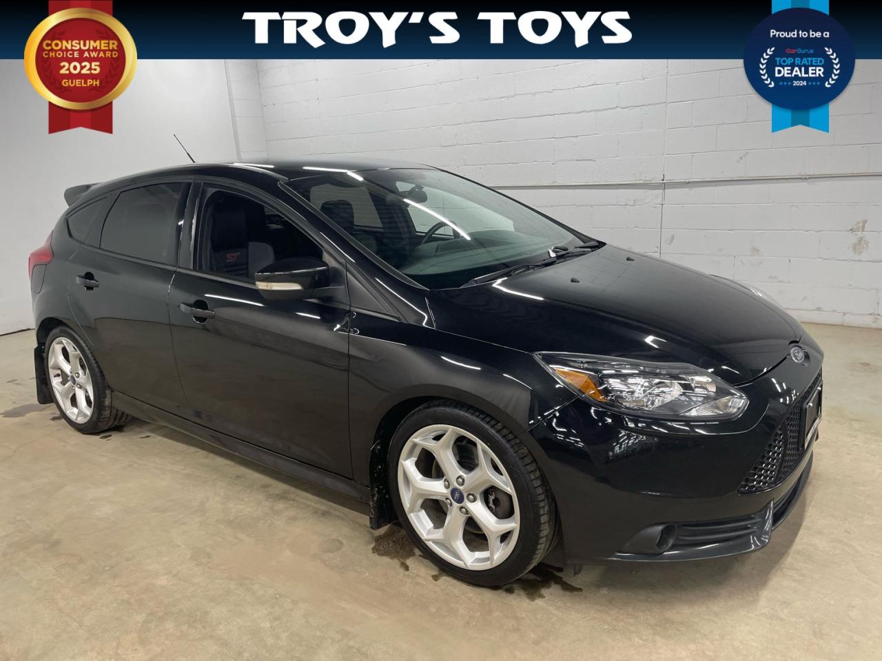 <p>Looking for a sporty ride thats also practical? Feast your eyes on this sleek 2013 Ford Focus ST, now available at Troys Toys! This black beauty is ready to turn heads with its aggressive styling and exhilarating performance. The ST trim offers a driving experience that’s a cut above the rest, perfect for navigating city streets or carving up winding roads. With its striking black exterior and sporty interior, youll be driving in style and comfort.</p><p>Under the hood, youll find a potent 2L I4 Turbo engine thats paired with a manual transmission, giving you complete control and a truly engaging drive. This Focus ST is a front-wheel-drive machine, ready to deliver thrills with every shift. This one has just 126,000 km on the odometer, meaning its got plenty of life left to give. Don’t miss your chance to experience the fun and functionality this Focus ST has to offer. Visit Troy’s Toys today and take it for a spin!</p><p>Here are five features that make this 2013 Ford Focus ST a standout:</p><ul><li><strong>Turbocharged Power:</strong> Experience the rush of a responsive turbo engine that delivers thrilling acceleration and a sporty driving experience.</li><li><strong>Manual Transmission:</strong> Take control with the precision and engagement of a manual transmission, enhancing the connection between you and the road.</li><li><strong>Sport-Tuned Suspension:</strong> Enjoy superior handling and a more dynamic ride with the STs performance-oriented suspension.</li><li><strong>Sporty Styling:</strong> Turn heads with the aggressive and distinctive ST body kit, designed to make a statement on every street.</li><li><strong>Front Wheel Drive:</strong> Get a good grip of the road.</li></ul><p><strong><em>Powered by AutoIntelligence™</em></strong> Vehicle information has been generated using artificial intelligence and is provided for informational purposes only. While efforts are made to ensure accuracy, please confirm all details directly with the dealer.</p>
