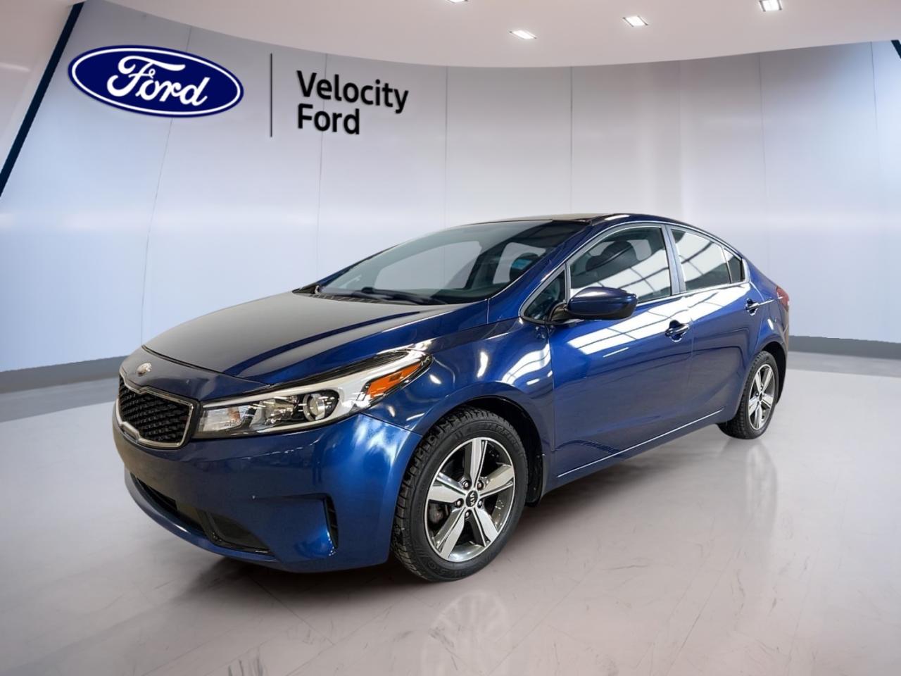 Experience the perfect blend of practicality and modern features with the 2018 Kia Forte LX+ Auto, now available at Velocity Ford in Moose Jaw. Dressed in a vibrant blue exterior and equipped with a fuel-efficient 2.0-litre gas engine, this sedan is ready for your daily commute or weekend adventures. With only 81,011 km on the odometer, it offers reliable performance and comfort for Canadian drivers.

FEATURES OF THE Forte LX+ Auto  
»» Heated front seats for added comfort  
»» Backup camera for stress-free parking  
»» Bluetooth integration for hands-free calls  
»» Automatic headlights for improved visibility  

ADVANCED SAFETY FEATURES  
»» Anti-Lock Braking System (ABS) for secure stops  
»» Stability control to enhance driving confidence  
»» Side impact and head side airbags for protection  
»» Child safety locks for peace of mind  

PERFORMANCE AND EFFICIENCY  
»» 2.0-litre engine delivers balanced power  
»» 6-speed automatic transmission for smooth shifts  
»» Front-wheel drive (FWD) for responsive handling  
»» Performance tires for better road grip  

COMFORT AND CONVENIENCE  
»» Cruise control for relaxed highway driving  
»» Power steering for effortless manoeuvring  
»» Heated mirrors for clear winter visibility  
»» Adjustable steering wheel for personalized comfort  

TECHNOLOGY AND CONNECTIVITY  
»» Steering wheel audio controls for easy access  
»» Satellite radio for diverse entertainment options  
»» Bluetooth connectivity for seamless device pairing  
»» Illuminated vanity mirrors for added convenience  

CARGO SPACE  
»» Remote trunk release for easy access  
»» Rear trunk access for versatile storage  
»» Spacious trunk for groceries or luggage  
»» Rear window defroster for all-season usability  

WHAT OTHER OWNERS LIKE  
»» Heated front seats for Canadian winters  
»» User-friendly infotainment and Bluetooth features  
»» Comfortable ride quality for city and highway  
»» Reliable fuel efficiency and low running costs  

This 2018 Kia Forte LX+ Autos VIN is: 3KPFL4A7XJE276943.