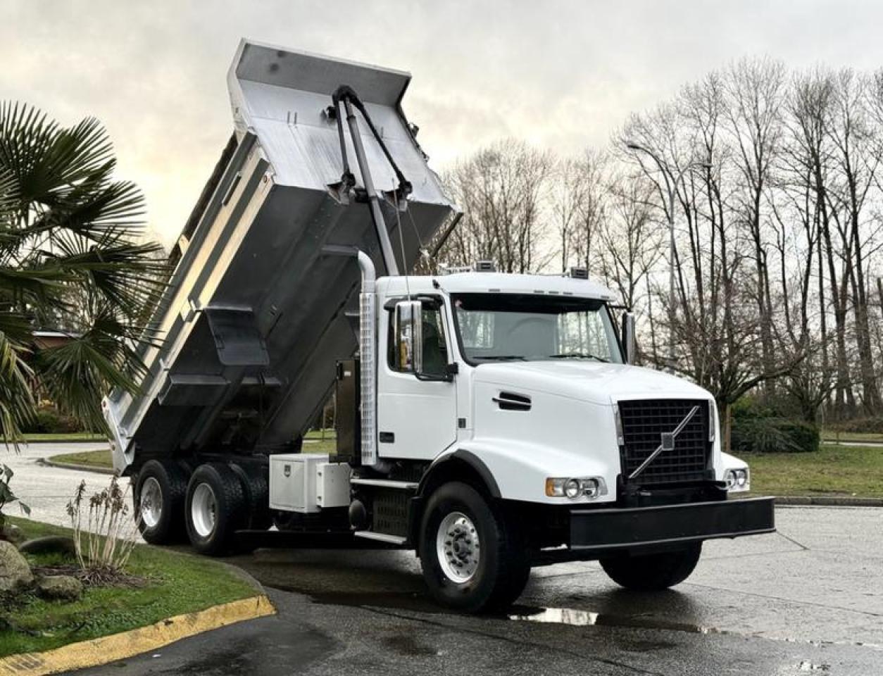 This 2009 Volvo VHD tandem dump truck is powered by a Volvo D13 12.8L 6-cylinder diesel engine paired with an 18-speed manual transmission and a 6x4 drivetrain, built for heavy-duty hauling and construction work. It features air brakes, engine brake, rear and center differential locks, and plow lights, making it well suited for demanding on-road and jobsite conditions. The truck is equipped with a 16-foot dump box measuring approximately 7 ft 4 in wide, along with a side ladder and storage compartment for added jobsite practicality. Interior and cab equipment includes air conditioning and heat, AM/FM radio, power windows, power door locks, power mirrors, and heated mirrors, finished in a white exterior with grey cloth interior. With a GVWR of approximately 29,937 kg (66,000 lb), this Volvo VHD represents a heavy-duty tandem dump truck configuration commonly used in construction, aggregate hauling, and municipal applications. This item is currently OFFSITE. You must register an appointment with our office to schedule an offsite viewing. Appointments must be made a minimum of one business day in advance (and as defined by the days that Repo.com is open for business) before your appointment can be scheduled and confirmed. We may, at our own discretion, instead opt to transport smaller items to Repo.coms main yard for viewing purposes.  $79,880.00 plus $375 processing fee, $80,255.00 total payment obligation before taxes.  Listing report, warranty, contract commitment cancellation fee, financing available on approved credit (some limitations and exceptions may apply). All above specifications and information is considered to be accurate but is not guaranteed and no opinion or advice is given as to whether this item should be purchased. We do not allow test drives due to theft, fraud, acts of vandalism and undetectable impaired driving. Instead we provide the following benefits: Complimentary Warranty (with options to extend), Limited Money Back Satisfaction Guarantee on Fully Completed Contracts, Contract Commitment Cancellation, and an Open-Ended Sell-Back Option. Ask seller for details or call 604-522-REPO(7376) to confirm listing availability.