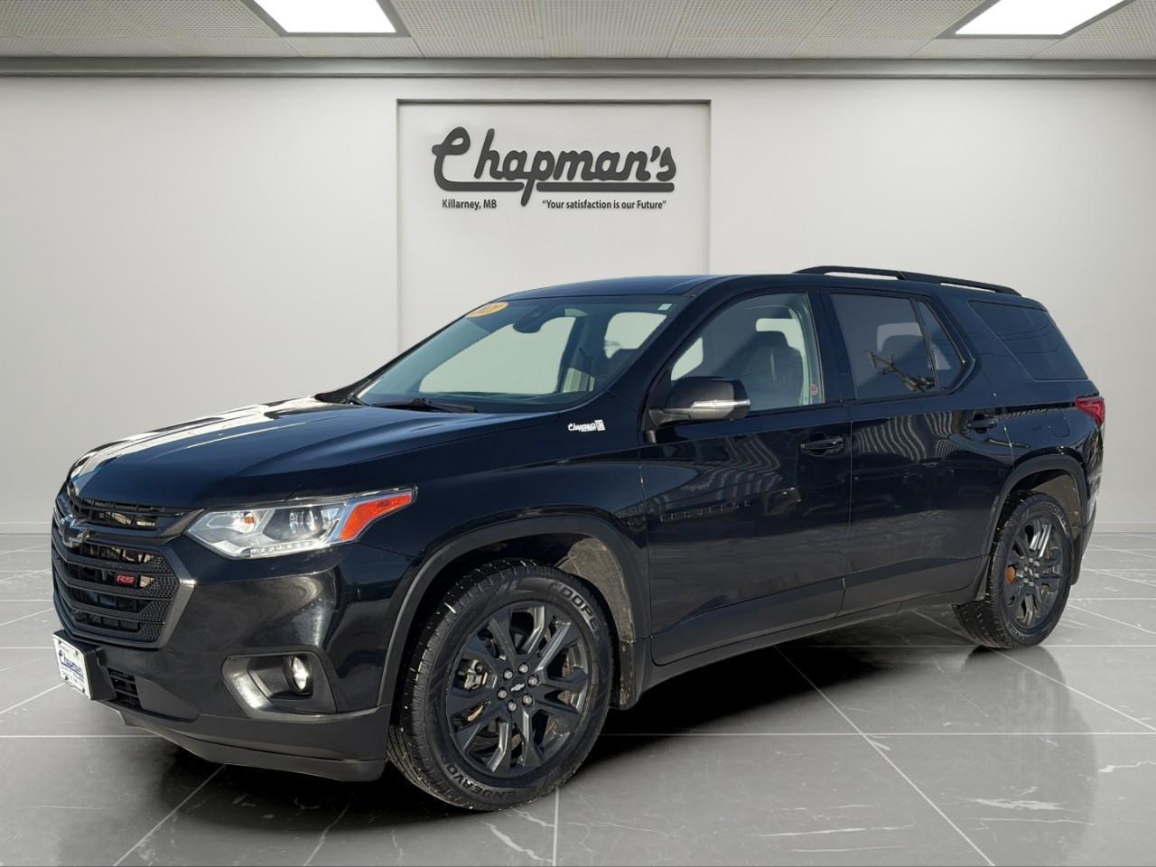 <p>The <strong>2021 Chevrolet Traverse RS AWD</strong> blends bold sport-inspired styling with spacious comfort and confident all-wheel-drive capability. Finished in sleek <strong>Mosaic Black Metallic</strong> with a refined <strong>Jet Black leather interior</strong>, this RS trim delivers an aggressive look while remaining perfectly suited for family life and road trips.</p><p>Power comes from a strong and reliable <strong>3.6L DOHC V6 engine</strong> paired with a smooth <strong>9-speed automatic transmission</strong>, providing confident acceleration and towing capability. With its <strong>AWD system</strong> and <strong>trailering package</strong>, the Traverse is ready for Canadian winters, weekend getaways, and everything in between.</p><h3><strong>Performance & Capability</strong></h3><ul><li><p><strong>3.6L DOHC V6 Engine with VVT</strong></p></li><li><p><strong>9-Speed Automatic Transmission</strong></p></li><li><p><strong>All-Wheel Drive (AWD)</strong></p></li><li><p><strong>Trailering Package with Hitch View & Hitch Guidance</strong></p></li><li><p><strong>Engine Start/Stop Technology</strong></p></li><li><p><strong>Traction Mode Select</strong></p></li><li><p><strong>4-Wheel Anti-Lock Disc Brakes</strong></p></li></ul><h3><strong>RS Interior Comfort</strong></h3><p>Designed to keep the whole family comfortable:</p><ul><li><p><strong>Leather-Appointed Seating</strong></p></li><li><p><strong>Heated Front Seats</strong></p></li><li><p><strong>Heated Leather-Wrapped Steering Wheel</strong></p></li><li><p><strong>8-Way Power Driver Seat with Power Lumbar</strong></p></li><li><p><strong>6-Way Power Front Passenger Seat with Power Lumbar</strong></p></li><li><p><strong>Tri-Zone Automatic Climate Control</strong></p></li><li><p><strong>7-Passenger Seating</strong></p></li><li><p><strong>Power Liftgate</strong></p></li><li><p><strong>120V AC Power Outlet</strong></p></li></ul><h3><strong>Technology & Connectivity</strong></h3><p>Modern tech for entertainment and convenience:</p><ul><li><p><strong>Chevrolet Infotainment System with 8" Colour Touchscreen</strong></p></li><li><p><strong>Built-In Navigation</strong></p></li><li><p><strong>Apple CarPlay & Android Auto</strong></p></li><li><p><strong>Bose Premium Audio System</strong></p></li><li><p><strong>SiriusXM Radio (3-Month Trial)</strong></p></li><li><p><strong>OnStar & 4G LTE Wi-Fi Hotspot Capability</strong></p></li><li><p><strong>Remote Vehicle Start</strong></p></li><li><p><strong>Universal Home Remote</strong></p></li></ul><h3><strong>Safety & Driver Assistance</strong></h3><p>Packed with advanced safety features for peace of mind:</p><ul><li><p><strong>HD Surround Vision</strong></p></li><li><p><strong>Automatic Emergency Braking</strong></p></li><li><p><strong>Forward Collision Alert</strong></p></li><li><p><strong>Lane Keep Assist with Lane Departure Warning</strong></p></li><li><p><strong>Lane Change Alert with Side Blind Zone Alert</strong></p></li><li><p><strong>Rear Cross Traffic Alert</strong></p></li><li><p><strong>Rear Park Assist</strong></p></li><li><p><strong>Front Pedestrian Braking</strong></p></li><li><p><strong>Following Distance Indicator</strong></p></li><li><p><strong>IntelliBeam Automatic High Beams</strong></p></li><li><p><strong>Teen Driver Technology</strong></p></li></ul><h3><strong>Exterior Highlights</strong></h3><ul><li><p><strong>20" Dark Android Painted Aluminum Wheels</strong></p></li><li><p><strong>RS Sport Styling</strong></p></li><li><p><strong>HID Headlamps with LED Daytime Running Lights</strong></p></li><li><p><strong>Front Fog Lamps</strong></p></li><li><p><strong>Black Roof Rails</strong></p></li><li><p><strong>Deep-Tinted Rear Glass</strong></p></li></ul><h3><strong>Why Choose This Traverse RS</strong></h3><p>With its <strong>sporty RS appearance</strong>, <strong>V6 performance</strong>, <strong>AWD confidence</strong>, <strong>Bose audio</strong>, and <strong>advanced safety technology</strong>, the <strong>2021 Chevrolet Traverse RS AWD</strong> is an excellent choice for families who want space, style, and capability in one bold SUV.</p><p>Price Includes Dealer Fee.</p><p>Price Excludes PST & GST.</p><p>Financing Options Available, Call For More Details.</p> <p><strong>*While every reasonable effort is made to ensure the accuracy of this information, we are not responsible for any error or omissions contained on these pages. Please verify any information in question with Chapman Motors Ltd.</strong></p>