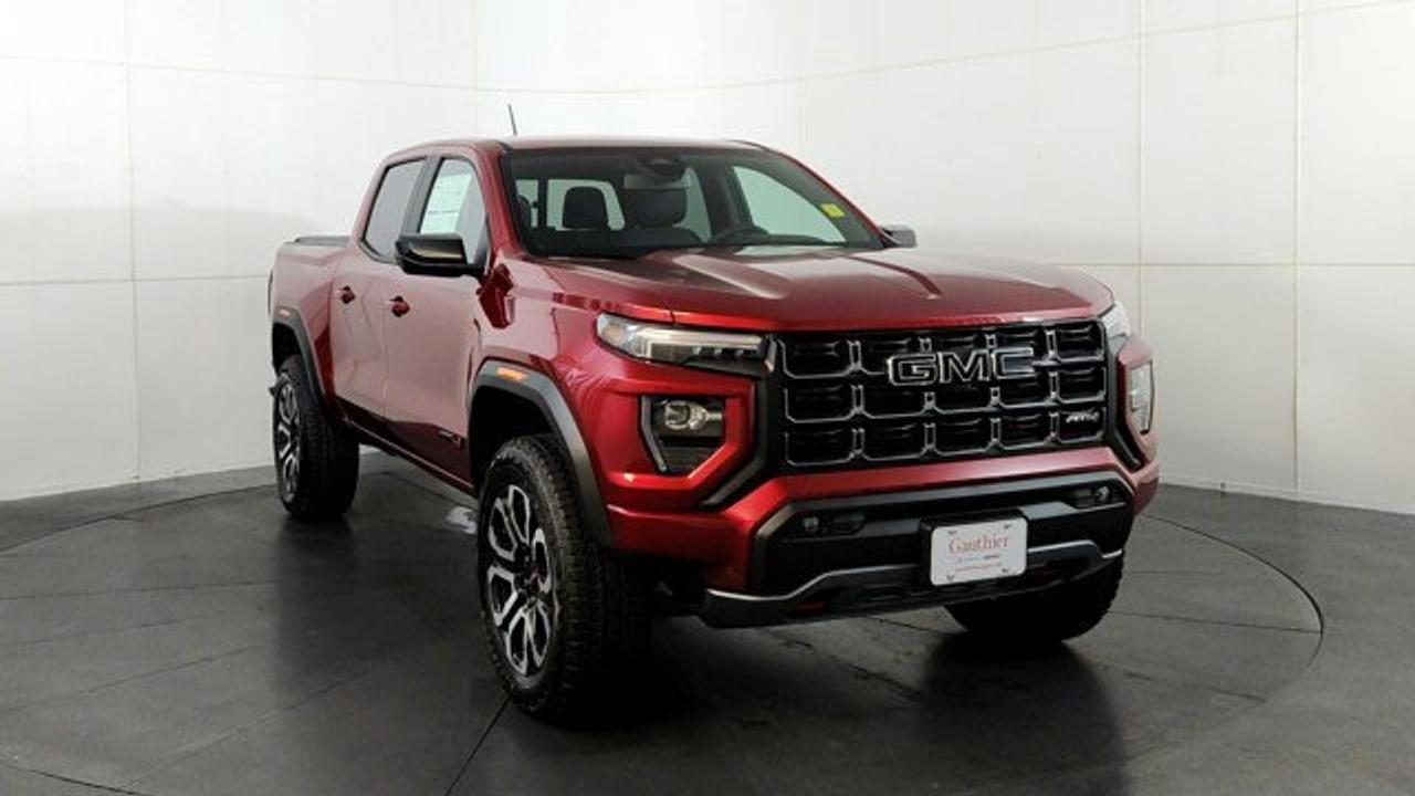 The 2026 GMC Canyon AT4 is an off-road--focused midsize pickup that comes standard with a 2-inch factory lift, an ultra-wide track, and 4WD equipped with a two-speed AutoTrac transfer case, automatic locking rear differential, and advanced Hill Descent Control. Under the hood, its powered by the potent TurboMax 2.7 L turbocharged inline-4 engine delivering 310 hp and 430 lb-ft of torque, with a max towing capacity of up to 7,700 lbs. Inside, the AT4 features a modern 11.3-inch center infotainment touchscreen, an 11-inch digital driver information display, leather heated and ventilated front seats, wireless charging, a sunroof and adaptive cruise control.