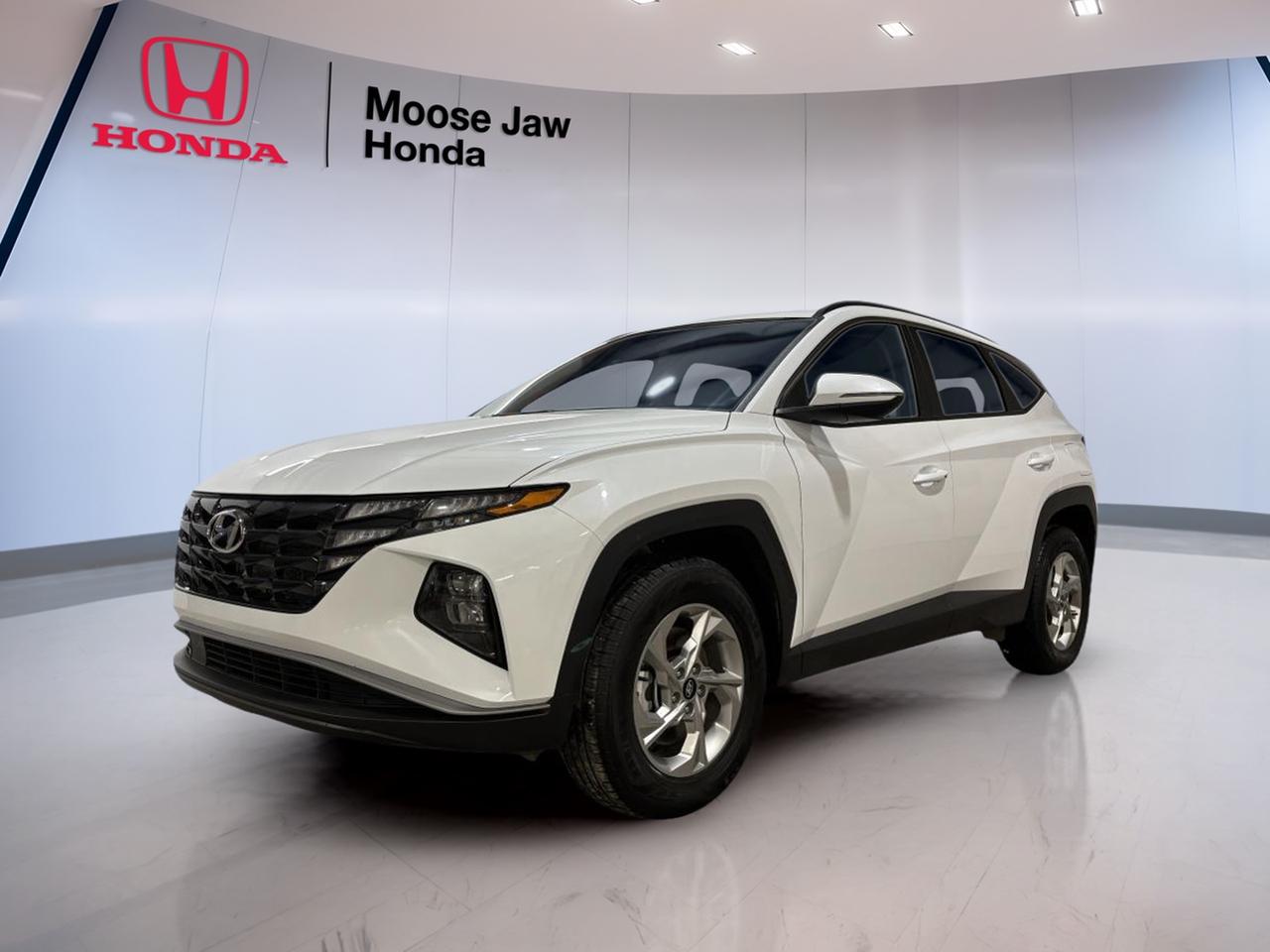 Meet the SUV that fits Moose Jaw life in every season: this used 2024 Hyundai Tucson Preferred from Moose Jaw Honda. Finished in clean White with a Black interior, it brings a modern look and a practical layout that works for commuting, errands, and weekend trips. With 63,587 km, it has already proven it can handle real Canadian driving while still offering the comfort and confidence drivers want in a compact SUV.

This 2024 Hyundai Tucson Preferred is powered by a 2.5 L GDI MPI DOHC I4 CVVT engine with engine idle stop, paired with an 8-speed automatic transmission with SHIFTRONIC. The result is smooth, easy acceleration and calm shifting in traffic. Add all-wheel drive and you get extra grip when roads turn slick, whether it is fresh snow, slush, or spring rain. It is a smart match for Saskatchewan highways and city streets alike.

FEATURES OF THE Tucson Preferred  
»» 2.5 L four-cylinder gasoline engine  
»» All-wheel drive for four-season confidence  
»» 8-speed automatic with SHIFTRONIC control  
»» Engine idle stop for reduced fuel use  

ADVANCED SAFETY FEATURES  
»» All-wheel drive helps maintain traction  
»» Stable handling for confident daily driving  
»» Predictable braking feel in varied conditions  
»» Clear outward visibility from SUV seating  

PERFORMANCE AND EFFICIENCY  
»» 2.5 L GDI MPI four-cylinder power  
»» 8-speed automatic supports smooth acceleration  
»» SHIFTRONIC manual mode when you want  
»» Engine idle stop reduces idle fuel  

COMFORT AND CONVENIENCE  
»» Compact SUV size, easy to park  
»» Practical cabin layout for daily use  
»» Supportive seating for longer highway drives  
»» Simple controls that are easy to learn  

TECHNONOLGY AND CONNECTIVITY  
»» SHIFTRONIC provides driver-selected gear control  
»» Clear instrument display for key information  
»» Modern automatic transmission logic for smoothness  
»» Easy-to-read controls while on the move  

CARGO SPACE  
»» SUV cargo area for everyday flexibility  
»» Room for groceries, bags, and gear  
»» Practical shape for loading larger items  
»» Flexible space for weekend errands  

WHAT OTHER OWNERS LIKE  
»» Confident feel from all-wheel drive  
»» Smooth shifting from the 8-speed  
»» Practical size for city and highway  
»» Useful power from the 2.5 L  

If you are shopping for a capable, no-fuss SUV with all-wheel drive and a proven powertrain, this 2024 Hyundai Tucson Preferred at Moose Jaw Honda deserves a closer look. It is ready for the daily drive across Moose Jaw and beyond, with the right mix of comfort, traction, and straightforward performance.