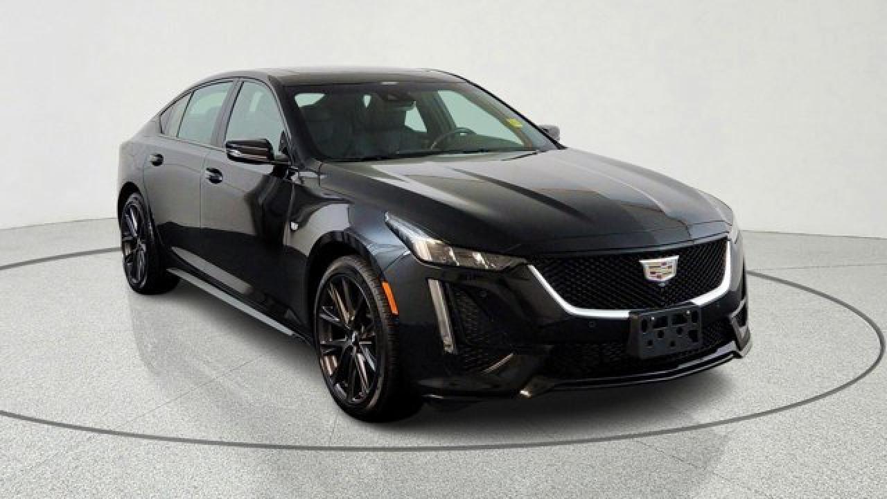 The 2022 Cadillac CT5 Sport is a sport-oriented midsize luxury sedan that builds on the Premium Luxury trim with distinctive touches like 19-inch alloy wheels, a rear spoiler, black exterior accents and a sport steering wheel with magnesium paddle shifters. Inside, it offers comfortable 18-way power-adjustable front seats with bolstering, simulated leather upholstery, modern connectivity like wireless Apple CarPlay/Android Auto and wireless phone charging, and a host of standard safety systems including blind-spot monitoring and automatic emergency braking. The Sport trim strikes a balance between upscale comfort and a sportier look and feel, making it a compelling choice for those seeking performance-inspired styling.