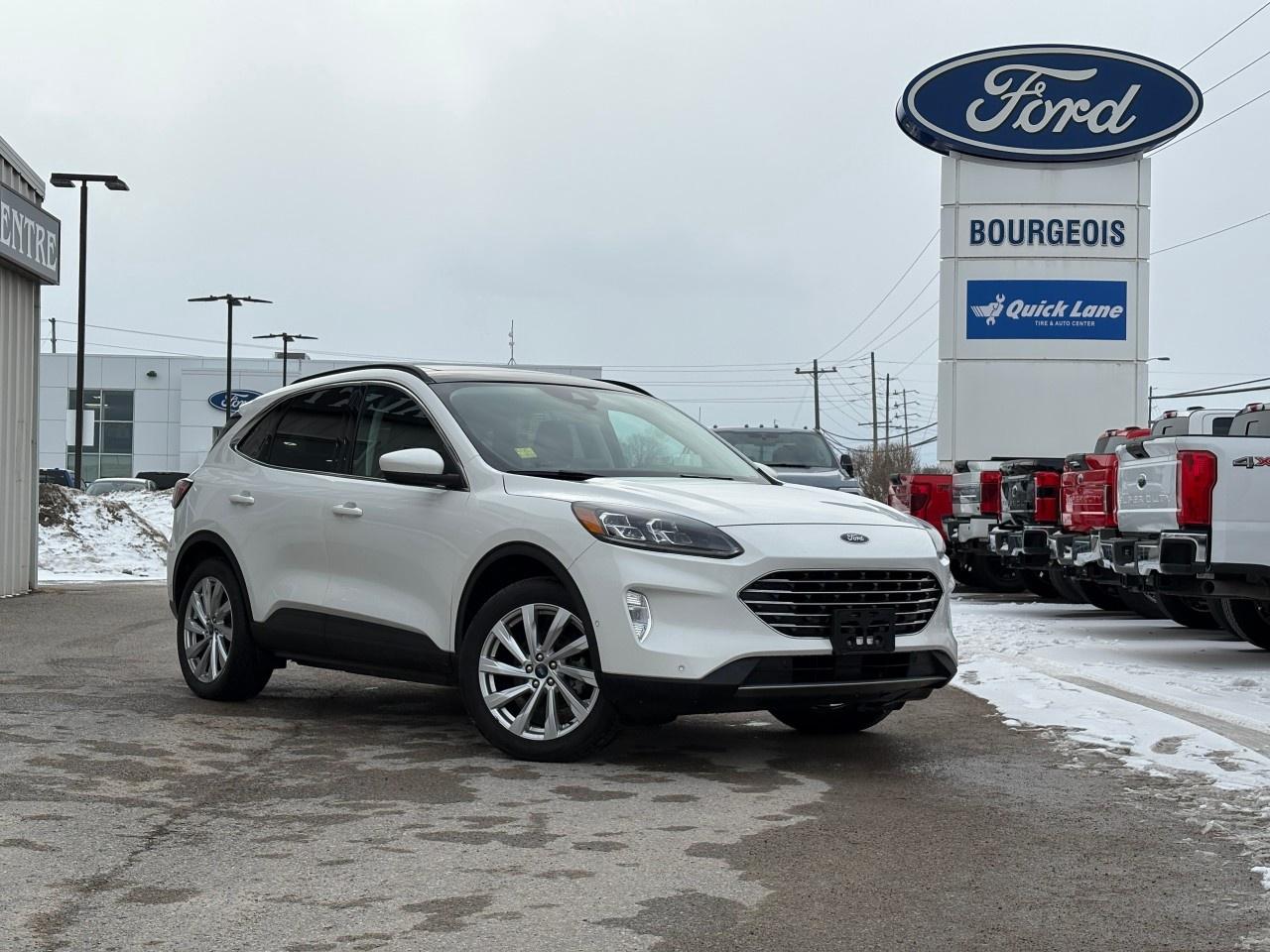 <p>The 2022 Ford Escape Titanium Hybrid AWD in a stylish White finish delivers a perfect blend of efficiency and capability with its automatic transmission and all-wheel drive system. This SUV offers confident handling on all terrains, making it an ideal choice for Canada's diverse weather conditions.</p><p>The exterior boasts a clean, modern design that stands out with alloy wheels, complemented by a spacious Black interior that is not only comfortable but equipped with a host of luxurious features like heated seats, a heated steering wheel, and a power moonroof. Whether it's a daily commute or a long road trip, the generously appointed cabin ensures a pleasant journey.</p><p>Equipped with the latest technology, this Escape includes a navigation system, a backup camera, and smart device integration. Stay connected with Bluetooth and a Wi-Fi hotspot, while the adaptive cruise control and lane assist provide added safety and convenience. The inclusion of a remote start and parking sensors makes it highly practical for everyday use.</p><p>This Ford Escape is perfect for those seeking a reliable and feature-rich SUV that excels in both form and function. Whether you're a busy professional or an adventurous family, this vehicle caters to all. Contact us today to learn more and schedule your test drive!</p>