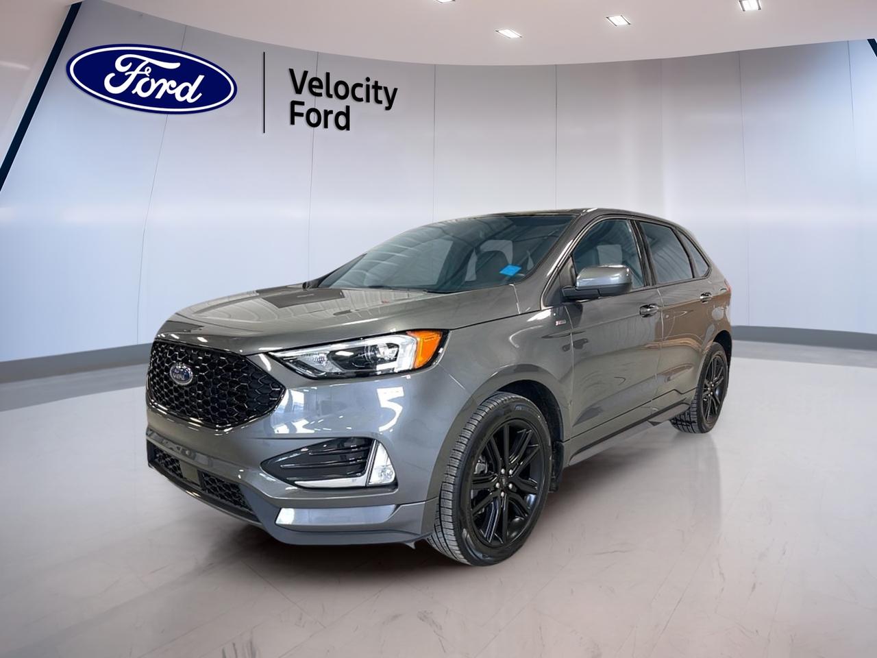 The used 2022 Ford Edge ST Line AWD at Velocity Ford in Moose Jaw brings sporty style, smart utility, and everyday confidence in one well-rounded SUV. With its Grey exterior, Black interior, four-door layout, and 51,030 km, this Ford Edge ST Line AWD is ready for commuting, family travel, and prairie road trips.

Powered by a 2.0-litre unleaded engine and paired with an 8-speed automatic transmission, this 2022 Ford Edge ST Line AWD delivers smooth response and confident all-weather traction. It also adds a strong list of comfort, safety, and connectivity features that make each drive easier, more relaxing, and more enjoyable.

FEATURES OF THE Edge ST Line AWD
»» Sport-inspired exterior with rear spoiler
»» All-wheel drive for year-round traction
»» Heated front seats for cold mornings
»» Power liftgate adds daily convenience

ADVANCED SAFETY FEATURES
»» Backup camera helps with reversing visibility
»» Blind spot monitor adds lane awareness
»» Lane departure warning supports safer travel
»» Side and head airbags enhance protection

PERFORMANCE AND EFFICIENCY
»» 2.0-litre unleaded engine balances power efficiently
»» 8-speed automatic supports smooth acceleration
»» All-wheel drive improves grip in weather
»» Limited slip differential aids traction control

COMFORT AND CONVENIENCE
»» Dual-zone climate control keeps comfort balanced
»» Remote starter warms cabin before entry
»» Power liftgate simplifies cargo area access
»» Driver lumbar support helps reduce fatigue

TECHNONOLGY AND CONNECTIVITY
»» Bluetooth integration supports hands-free phone calls
»» WiFi hotspot keeps passengers better connected
»» Satellite radio expands in-cabin entertainment choices
»» Steering wheel audio controls aid focus

CARGO SPACE
»» Rear trunk access makes loading easier
»» Power liftgate helps with busy days
»» Four-door design supports family practicality
»» Spare tire adds travel peace

AWARDS & RECOGNITIONS
»» Top Safety Pick, Insurance Institute for Highway Safety, 2022

WHAT OTHER OWNERS LIKE
»» Comfortable ride quality for daily driving
»» Easy-to-use infotainment and cabin controls
»» Confident winter traction from all-wheel drive
»» Useful cargo room for active lifestyles

This used 2022 Ford Edge ST Line AWD offers the features drivers want most for life in Saskatchewan. Cruise control, power steering, anti-lock braking system, stability control, child safety locks, automatic headlights, fog lights, LED headlamps, heated mirrors, power windows, push button start, tinted windows, and an auto-dimming rearview mirror all add everyday value.

Inside, this 2022 Ford Edge ST Line AWD is designed for comfort and convenience. Heated front seats, automatic climate control, front air conditioning, illuminated vanity mirrors, a leather steering wheel, power driver seat, power passenger seat, and rear window defroster help create a cabin that feels ready for every season.

For drivers who want sporty appearance, practical space, and trusted Ford capability, this SUV delivers a smart balance. The 2022 Ford Edge ST Line AWD is a confident choice for errands, highway travel, and changing road conditions around Moose Jaw and beyond.

This 2022 Ford Edge ST Line AWDs VIN is: 2FMPK4J93NBA89397.