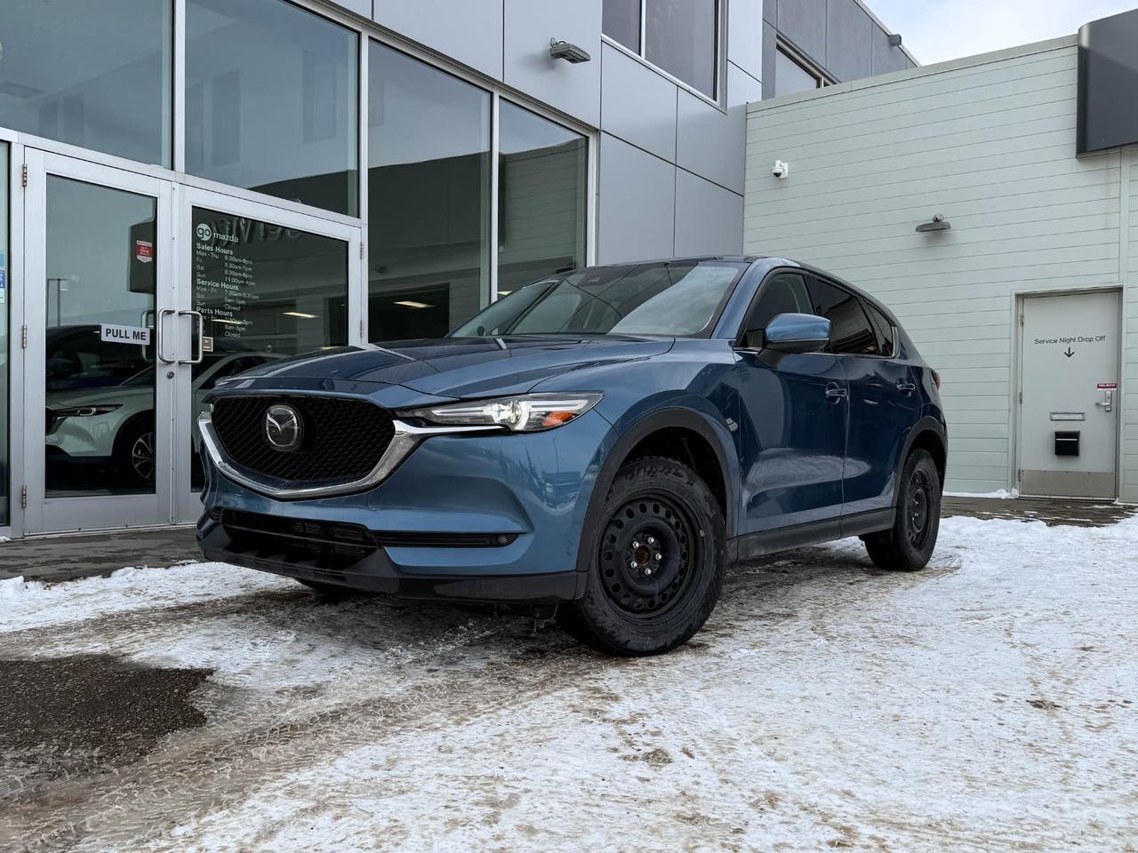 Discover the perfect blend of style, performance, and luxury with this pre-owned 2021 Mazda CX-5 GT AWD in stunning Blue. Powered by a responsive 2.5L SKYACTIV-G engine and paired with a smooth 6-speed automatic transmission, this SUV delivers an engaging and efficient drive every time.Step inside to experience premium leather upholstery, heated and ventilated front seats, and a dual-zone climate control system designed for your comfort. The advanced Bose premium sound system and integrated navigation provide entertainment and seamless connectivity on every journey.Safety is paramount with Mazdas full suite of driver-assist features including blind-spot monitoring, lane departure prevention, and forward collision mitigation. The all-wheel-drive system ensures confidence and control in all conditions.Ride in style and confidence with 19 alloy wheels, LED adaptive headlights, and a power liftgate for convenience. This CX-5 GT combines Mazdas signature craftsmanship with cutting-edge technology  making it the smart choice for your next SUV.Schedule your test drive today and experience the exceptional quality of the 2021 Mazda CX-5 GT AWD!Go Mazda is an AMVIC licensed business