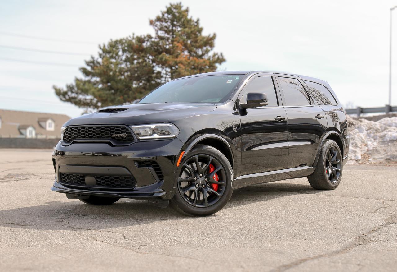 NAVIGATION, SUNROOF, BACKUP CAMERA, BLUETOOTH, HEATED SEATS, REMOTE START, PREMIUM AUDIO AND MORE !!!

Our thrilling One Owner 2023 Dodge Durango SRT Hellcat Premium AWD is the pinnacle of power and prestige in Diamond Black! Motivated by a SuperCharged 6.2 Litre HEMI V8 supplying 710hp to a paddle-shifted 8 Speed Automatic transmission for 60mph sprints in only 3.5 seconds. A track-tuned athlete, this All Wheel Drive SUV also rides with an adaptive-damping competition suspension and Brembo brakes, and it returns approximately 13.8L/100km on the highway. Our Durango draws attention with LED lighting, a power sunroof, a performance hood, an aggressive front splitter, dual-exhaust outlets, a power liftgate, and 20-inch wheels.

Crafted for enthusiasts, our impressive SRT Hellcat Premium cabin has heated/ventilated leather power front seats, heated second-row captains chairs, a flexible third row, a heated leather power steering wheel, tri-zone automatic climate control, carbon-fiber trim, and a hand-wrapped instrument panel. Harman Kardon audio, a 10.1-inch touchscreen, voice command, wireless charging, full-color navigation, WiFi compatibility, Android Auto&reg;/Apple CarPlay&reg;, Bluetooth&reg;, and SRT Performance Pages add compelling digital benefits.

Dodges intelligent safety measures include automatic braking, adaptive cruise control, lane-keeping assistance, a rearview camera, blind-spot monitoring, and more. Our Durango SRT Hellcat Premium is terrific at towing, too! Save this Page and Call for Availability. We Know You Will Enjoy Your Test Drive Towards Ownership! Bustard Chrysler prides ourselves on our expansive used car inventory. We have over 100 pre-owned units in stock of all makes and models, with the largest selection of pre-owned Chrysler, Dodge, Jeep, and RAM products in the tri-cities. Our used inventory is hand-selected and we only sell the best vehicles, for a fair price. We use a market-based pricing system so that you can be confident youre getting the best deal. With over 25 years of financing experience, our team is committed to getting you approved - whether you have good credit, bad credit, or no credit! We strive to be 100% transparent, and we stand behind the products we sell. For your peace of mind, we offer a 3 day/250 km exchange as well as a 30-day limited warranty on all certified used vehicles.