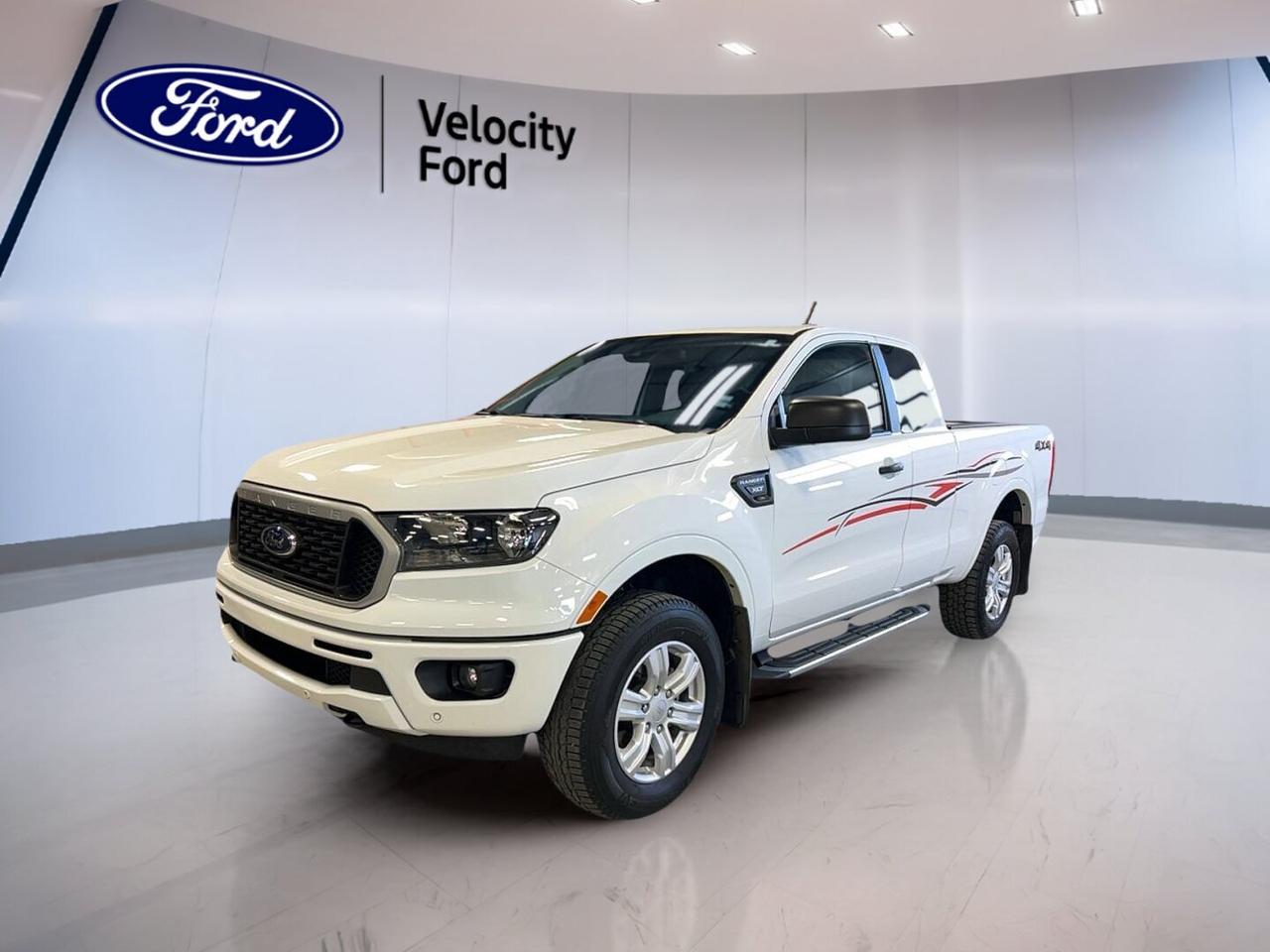 Built for work, play, and Canadian weather, this used 2019 Ford Ranger XLT 4WD SuperCab 6 Box delivers solid capability in a smart, practical package. Finished in White with a Black interior, it combines a proven 2.3-litre unleaded engine, automatic transmission, and four-wheel drive for confident driving around Moose Jaw and beyond.

With 64,113 km on the odometer, this 2019 Ford Ranger XLT 4WD SuperCab 6 Box offers the right mix of durability and comfort for daily use. Its four-door SuperCab layout adds flexibility for passengers and gear, while the 6-foot box and 1,587 kg towing capacity help make every job, weekend trip, or seasonal task easier.

FEATURES OF THE Ranger XLT 4WD SuperCab 6 Box
»» Four-wheel drive for added traction
»» SuperCab design adds useful rear space
»» Six-foot box supports cargo flexibility
»» Automatic transmission for easy driving

TRUCK FEATURES
»» Towing capacity rated at 1,587 kg
»» Rear tow hook adds utility
»» Off-road tires support rougher terrain
»» Spare tire included for extra confidence

ADVANCED SAFETY FEATURES
»» Backup camera helps with reversing
»» Blind spot monitor boosts awareness
»» Lane departure warning adds support
»» Side and head airbags included

PERFORMANCE AND EFFICIENCY
»» 2.3-litre unleaded engine balances power
»» Automatic transmission shifts with ease
»» Dual shift mode adds control
»» Four-wheel drive improves road grip

COMFORT AND CONVENIENCE
»» Front air conditioning keeps cabin comfortable
»» Cruise control supports relaxed highway travel
»» Power windows add everyday convenience
»» Driver and passenger lumbar support

TECHNONOLGY AND CONNECTIVITY
»» Bluetooth integration supports hands-free calling
»» WiFi hotspot keeps devices connected
»» Steering wheel audio controls simplify use
»» Automatic door locks add convenience

CARGO SPACE
»» Six-foot box handles larger loads
»» SuperCab offers added interior storage
»» Four-door access helps loading gear
»» Tinted windows help protect cabin items

AWARDS & RECOGNITIONS
»» 2019 North American Truck finalist, North American Car Awards

WHAT OTHER OWNERS LIKE
»» Strong turbo power for daily driving
»» Easy-to-use controls and cabin layout
»» Useful towing and cargo capability
»» Confident four-wheel drive traction

This used 2019 Ford Ranger XLT 4WD SuperCab 6 Box at Velocity Ford is a practical midsize truck with the features drivers want most. From power steering and ABS to fog lights, automatic headlights, electric mirrors, and tire pressure monitoring, it delivers honest capability and everyday value in one dependable Ford package.

This 2019 Ford Ranger XLT 4WD SuperCab 6 Boxs VIN is: 1FTER1FHXKLA57399.