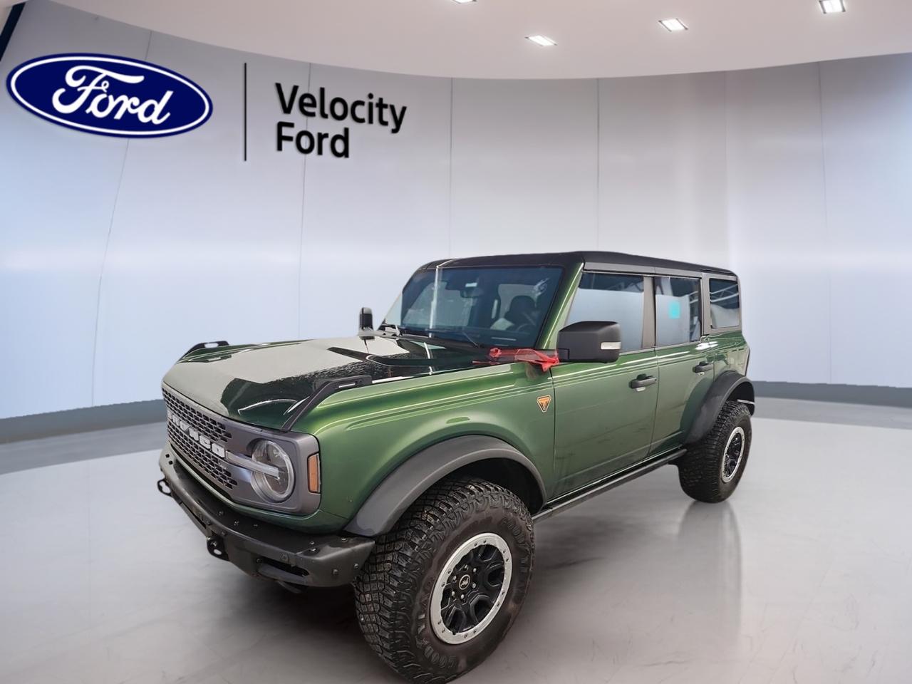 Built for real adventure, this used 2023 Ford Bronco Badlands 4 Door Advanced 4x4 brings rugged capability and open-air freedom to Moose Jaw. Finished in Green with a Black interior, it pairs bold style with proven off-road hardware. With 61,351 km, a 2.7-litre unleaded engine, and a 7-speed manual transmission, this Bronco Badlands 4 Door Advanced 4x4 delivers a hands-on driving experience that stands out on the road and on the trail.

At Velocity Ford, this Bronco Badlands 4 Door Advanced 4x4 offers the features drivers want most: four-wheel drive, off-road tires, a limited slip differential, and a convertible design for fresh-air fun. It also adds everyday ease with cruise control, power windows, heated mirrors, Bluetooth integration, Wi-Fi hotspot capability, and a backup camera. This SUV is ready for workdays, weekends, and every road in between.

FEATURES OF THE Bronco Badlands 4 Door Advanced 4x4
»» Four-wheel drive for confident off-road traction
»» Seven-speed manual gearbox adds driver control
»» Convertible design for open-air driving fun
»» Off-road tires support rugged terrain travel

ADVANCED SAFETY FEATURES
»» Backup camera helps with safer reversing
»» Stability control supports secure road handling
»» Anti-lock brakes help maintain steering control
»» Side and head airbags add protection

PERFORMANCE AND EFFICIENCY
»» 2.7-litre unleaded engine delivers strong power
»» Manual transmission gives direct driver engagement
»» Limited slip differential boosts trail traction
»» Four-wheel drive handles rough surfaces well

COMFORT AND CONVENIENCE
»» Front air conditioning keeps cabin comfortable
»» Cruise control supports relaxed highway driving
»» Power windows add daily driving ease
»» Adjustable steering wheel improves driving position

TECHNONOLGY AND CONNECTIVITY
»» Bluetooth integration supports hands-free phone connection
»» Wi-Fi hotspot helps keep devices connected
»» Steering wheel audio controls simplify use
»» Satellite radio expands entertainment choices

CARGO SPACE
»» Rear trunk access makes loading easier
»» Four-door layout improves passenger entry convenience
»» Spare tire adds extra trip confidence
»» Flexible SUV space suits daily gear

WHAT OTHER OWNERS LIKE
»» Strong off-road ability in varied conditions
»» Open-air convertible design feels fun
»» Manual transmission adds classic Bronco character
»» Useful technology features for daily driving

This 2023 Ford Bronco Badlands 4 Door Advanced 4x4s VIN is: 1FMEE5DP6PLB07375.