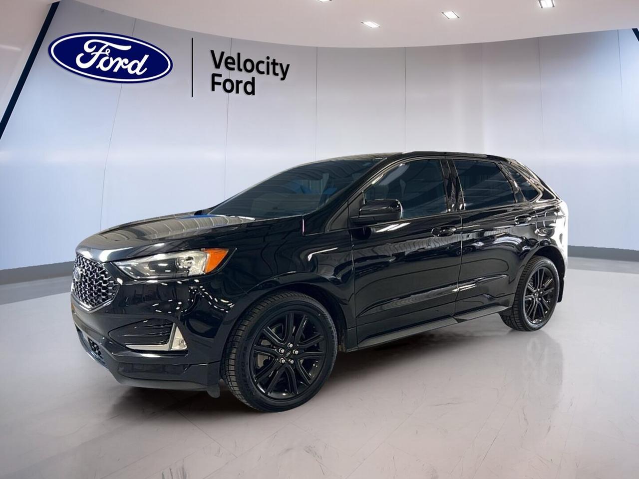 This used 2022 Ford Edge ST Line AWD at Velocity Ford in Moose Jaw delivers sporty style, smart utility, and everyday confidence. Its black exterior and black interior give it a clean, modern look. With 111,633 km, a 2.0-litre unleaded engine, four doors, and an 8-speed automatic transmission, this SUV is ready for commuting, highway travel, and family duty.

The 2022 Ford Edge ST Line AWD blends athletic design with practical comfort. The rear spoiler, fog lights, LED headlamps, tinted windows, and performance tires help give this SUV a bold road presence. All-wheel drive adds extra confidence in changing Prairie weather, while the power liftgate and remote starter make daily use easier.

FEATURES OF THE Edge ST Line AWD

»» ST Line styling adds sporty appearance
»» All-wheel drive boosts year-round confidence
»» LED headlamps improve nighttime visibility
»» Rear spoiler adds athletic exterior detail

ADVANCED SAFETY FEATURES

»» Backup camera helps with reversing confidence
»» Blind spot monitor supports safer lane changes
»» Lane departure warning adds extra awareness
»» Side and head airbags enhance protection

PERFORMANCE AND EFFICIENCY

»» 2.0-litre engine balances power and efficiency
»» 8-speed automatic supports smooth acceleration
»» All-wheel drive improves traction in weather
»» Limited slip differential aids road grip

COMFORT AND CONVENIENCE

»» Heated front seats add cold-weather comfort
»» Dual-zone climate control helps cabin comfort
»» Remote starter adds everyday convenience
»» Power liftgate simplifies cargo area access

TECHNONOLGY AND CONNECTIVITY

»» Bluetooth integration supports hands-free phone use
»» WiFi hotspot keeps passengers better connected
»» Satellite radio expands in-car entertainment choices
»» Steering wheel audio controls ease use

CARGO SPACE

»» Rear trunk access makes loading simple
»» Power liftgate helps with busy days
»» Four doors support family-friendly practicality
»» Spacious layout suits errands and travel

AWARDS & RECOGNITIONS

»» Top Safety Pick, Insurance Institute for Highway Safety, 2022

WHAT OTHER OWNERS LIKE

»» Confident all-wheel drive in changing weather
»» Comfortable ride for daily driving duties
»» Useful cargo space for active lifestyles
»» Easy-to-use technology and cabin controls

This 2022 Ford Edge ST Line AWD stands out with a smart mix of sporty design and real-world versatility. Features like heated mirrors, power windows, power steering, heated front seats, push-button start, automatic headlights, automatic climate control, and an auto-dimming rearview mirror help make every trip more enjoyable.

This SUV also includes useful details that drivers appreciate every day, such as electric mirrors, rear window defroster, child safety locks, tire pressure monitoring, cruise control, drivers seat lumbar support, drivers side power seat, electric passenger seat, and illuminated vanity mirrors. The leather steering wheel adds a refined touch, while the backup camera and blind spot monitor support added confidence behind the wheel.

For drivers in Moose Jaw looking for a well-equipped used SUV with style, comfort, and strong everyday usability, this 2022 Ford Edge ST Line AWD is an excellent fit. It offers the right blend of convenience, safety, and performance for Canadian driving conditions.

This 2022 Ford Edge ST Line AWDs VIN is: 2FMPK4J94NBA02137.