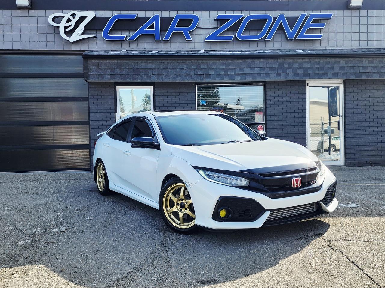 <p>Looking for a sporty and reliable ride? Then feast your eyes on this sleek and heavily modified 2019 Honda Civic Si, now available at Car Zone! This pristine white sedan with a red stitched black interior sitting on Gold Konig Wheels is ready to turn heads while delivering a&nbsp; super fun and exhilarating driving experience. Super responsive 6 speed manual transmission, youll feel completely connected to the road, whether youre navigating city streets or cruising on the highway. This Civic boasts a powerful 1.5L I4 Turbo Engine, Competition Stage 2 Clutch with Light Weight Flywheel, Obey Alcantara Shift Boot, PLM V2 Intercooler, AEM Drop In Filter, Rockford Fosgate Tweeters, Muffler Delete, Carbon Fiber Type R OEM Interior Trim, Yellow LeD Fog Lights, Clear Side Markers, Megan Racing EZ Street II Coil Overs, Konig Backbone 17x7.5 on Winter Tires offering a perfect blend of performance and fuel efficiency year round fun!&nbsp;</p><p>This Civic has been well-maintained and holds onto that Honda reliability making it a fantastic option for anyone seeking a dependable vehicle. The four-door sedan body style provides ample space for passengers and cargo, making it a practical choice for daily commutes and weekend adventures. The front-wheel drive ensures confident handling in various driving conditions. The vehicle also has a lengthy maintenance history, including most recent All Fluids at 121km.</p><p>Here are five reasons why youll love this Civic:</p><ul><li><strong>Turbocharged Thrills:</strong> Experience exhilarating performance with the punchy 1.5L Turbo engine.</li><li><strong>Manual Mastery:</strong> Enjoy the pure driving pleasure and control of a manual transmission.</li><li><strong>Sleek Style:</strong> Turn heads with its timeless white exterior and sporty sedan design.</li><li><strong>Fuel-Efficient Fun:</strong> Get the best of both worlds with a peppy engine that doesnt break the bank at the pump.</li><li><strong>Honda Reliability:</strong> Drive with confidence knowing youre behind the wheel of a car known for its dependability and longevity.</li></ul><p>Looking for Your Dream Car? Call or Come on Down to Car Zone Today!</p><p>Thanks for viewing our Car Zone inventory. All of our vehicles come fully detailed with a Carfax and a mechanical fitness assessment. Drive this home today! Easy financing options. All credit welcome.<a href=http://www.carzonecalgary.com/financing/>&nbsp;</a><strong><a href=http://www.carzonecalgary.com/financing/>APPLY NOW</a>&nbsp;</strong>We even take trades. Same day approvals at&nbsp;<a href=http://www.carzonecalgary.com/><strong>CARZONECALGARY</strong></a> or visit us in person at 2036 36 Street SE Calgary for a hassle free test drive. Let our friendly team of experts book an appointment with you and show you the Car Zone difference! AMVIC licensed dealer.&nbsp;</p>