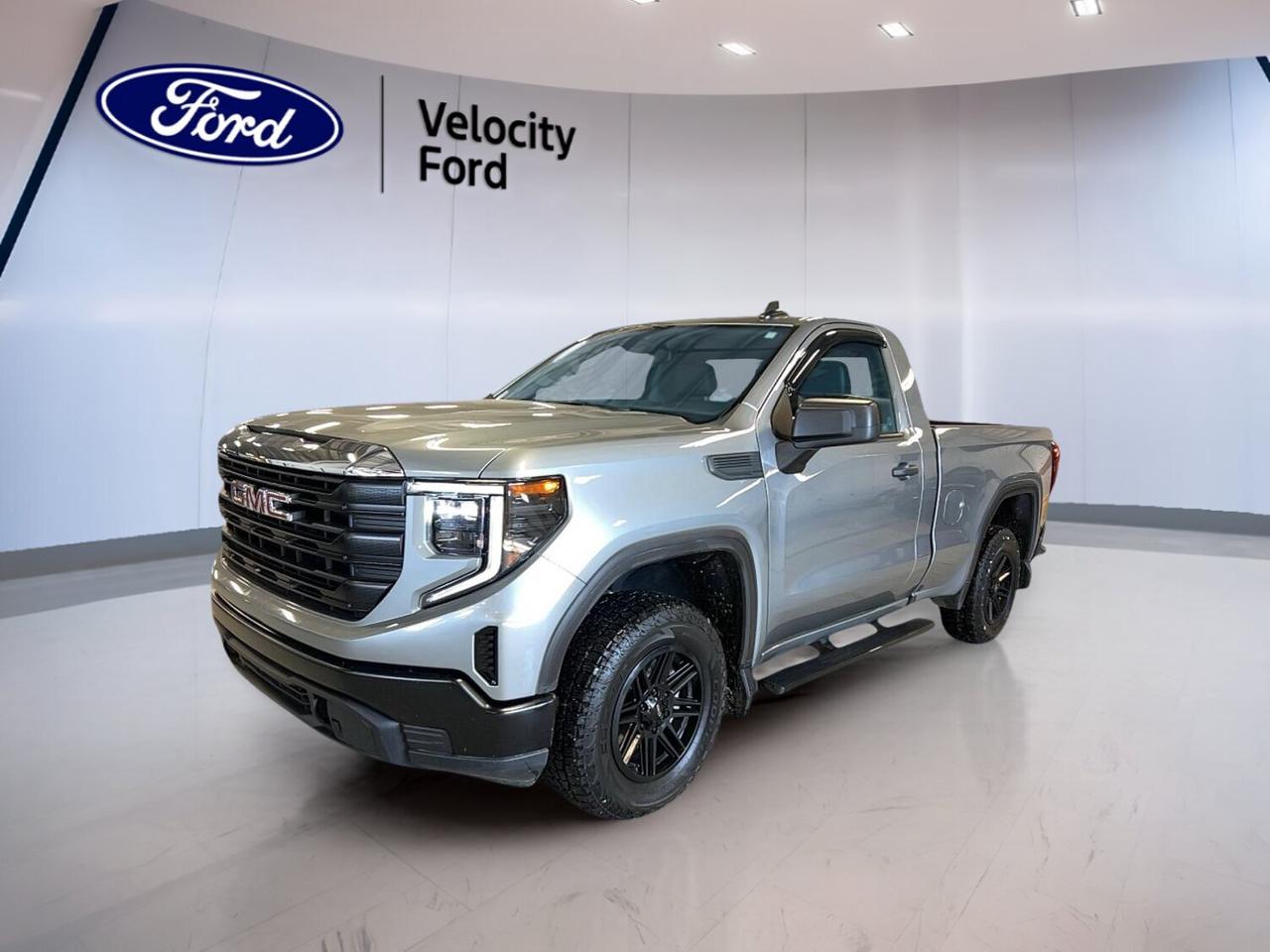 Built to work hard and ready for daily duty, this used 2024 GMC Sierra 1500 Regular Cab Standard Box Pro delivers solid capability in a clean, professional package. Finished in Silver with a Black interior, this two-door pickup combines a 2.7-litre unleaded engine, 8-speed automatic transmission, and four-wheel drive for confident performance in Moose Jaw and beyond.

With 35,793 km on the odometer, this 2024 GMC Sierra 1500 Regular Cab Standard Box Pro offers the strength many truck buyers want without extra complexity. Its practical cabin, durable setup, and useful safety features make it a smart fit for job sites, fleet use, and everyday hauling. The standard box adds welcome bed utility, while the 3,991-kg towing capacity supports serious work.

FEATURES OF THE Sierra 1500 Regular Cab Standard Box Pro

»» Regular cab with practical two-door layout
»» Standard box supports daily cargo needs
»» 2.7-litre gas engine balances usable power
»» Four-wheel drive adds year-round traction

TRUCK FEATURES

»» Tows up to 3,991 kg confidently
»» Rear tow hook aids recovery tasks
»» Standard box handles tools and supplies
»» Four-wheel drive supports rough conditions

ADVANCED SAFETY FEATURES

»» Backup camera helps with reversing views
»» Lane departure warning adds driving support
»» Stability control helps maintain vehicle balance
»» Multiple airbags support occupant protection

PERFORMANCE AND EFFICIENCY

»» 2.7-litre unleaded engine delivers strong response
»» Eight-speed automatic supports smooth shifting
»» Power steering helps easy daily control
»» Four-wheel drive improves traction on surfaces

COMFORT AND CONVENIENCE

»» Front air conditioning keeps cabin comfortable
»» Push button start adds everyday ease
»» Power windows offer simple operation
»» Adjustable steering wheel improves driving position

TECHNONOLGY AND CONNECTIVITY

»» Bluetooth integration supports hands-free communication
»» WiFi hotspot keeps devices connected
»» Power outlet helps charge small devices
»» Automatic door locks add daily convenience

CARGO SPACE

»» Standard box suits gear and equipment
»» Useful bed space for work materials
»» Regular cab focuses on cargo practicality
»» Pickup design supports active job demands

AWARDS & RECOGNITIONS

»» 2024 Best Buy Award, The Car Guide

WHAT OTHER OWNERS LIKE

»» Strong towing for work and trailers
»» Easy-to-use cabin controls and layout
»» Confident four-wheel drive capability year-round
»» Useful bed space for everyday tasks

This 2024 GMC Sierra 1500 Regular Cab Standard Box Pro is a straightforward truck designed for people who need real function. The silver exterior presents a clean look, while heated power mirrors, LED headlamps, steel wheels, and a durable interior setup help support dependable day-to-day use. Safety essentials such as Anti-Lock Braking System, tire pressure monitoring, head side airbags, side impact airbags, and passenger airbag sensor add peace of mind.

At Velocity Ford in Moose Jaw, this GMC pickup stands out as a capable used truck with the right mix of toughness, modern convenience, and proven utility. If you need a no-nonsense full-size pickup with automatic transmission, four-wheel drive, and solid towing ability, this Sierra 1500 is ready to get to work.

This 2024 GMC Sierra 1500 Regular Cab Standard Box Pros VIN is: 3GTNUAEK9RG361830.