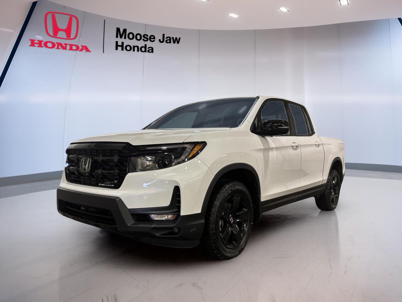 Brand new and ready for Saskatchewan roads, the 2026 Honda Ridgeline Black Edition brings smart truck utility, smooth V6 power, and everyday comfort to Moose Jaw Honda. Finished in White, this all-wheel-drive pickup pairs confident capability with a refined drive, making it a strong fit for work, family, and weekend travel.

Built with Honda engineering and practical design, the 2026 Honda Ridgeline Black Edition stands out for drivers who want truck strength without giving up comfort. Its 3.5-litre 24-valve SOHC i-VTEC V6 engine works with a 9-speed automatic transmission for responsive performance, steady highway cruising, and composed driving in changing conditions.

FEATURES OF THE Ridgeline Black Edition

»» White exterior with bold premium presence
»» 3.5-litre i-VTEC V6 engine power
»» 9-speed automatic with smooth shifting
»» All-wheel drive for year-round traction

TRUCK FEATURES

»» Strong towing capability for daily hauling
»» Pickup bed adds useful cargo flexibility
»» All-wheel drive supports rougher road confidence
»» Built for work and weekend duty

ADVANCED SAFETY FEATURES

»» Traction control supports slippery road stability
»» All-wheel drive boosts year-round confidence
»» Strong body structure helps protect occupants
»» Honda engineering supports secure road manners

PERFORMANCE AND EFFICIENCY

»» 3.5-litre V6 delivers smooth strong power
»» 9-speed automatic supports refined acceleration
»» All-wheel drive improves traction on roads
»» Balanced ride suits city and highway

COMFORT AND CONVENIENCE

»» Spacious cabin supports daily driving comfort
»» Four-door truck layout eases passenger access
»» Smooth transmission enhances long-drive comfort
»» Practical design suits work and family

TECHNONOLGY AND CONNECTIVITY

»» Clear driver controls support easy operation
»» Modern powertrain management improves responsiveness
»» Automatic transmission offers simple daily driving
»» Smart Honda engineering enhances usability

CARGO SPACE

»» Pickup bed handles gear and supplies
»» Flexible hauling space for daily tasks
»» Cabin offers room for passengers comfortably
»» Truck design supports active lifestyles

WHAT OTHER OWNERS LIKE

»» Smooth ride for a midsize truck
»» V6 power feels strong and refined
»» Useful bed for work and gear
»» Confident all-wheel drive in winter

This 2026 Honda Ridgeline Black Edition gives you the versatility of a truck with the comfort of a well-tuned daily driver. It is a smart choice for drivers in Moose Jaw who need practical hauling ability, dependable all-weather traction, and proven Honda durability in one well-rounded package.

This 2026 Honda Ridgeline Black Editions VIN is: 5FPYK3F82TB500900.<p> the 2026 Honda Ridgeline Black Edition stands out for drivers who want truck strength without giving up comfort. Its 3.5-litre 24-valve SOHC i-VTEC V6 engine works with a 9-speed automatic transmission for responsive performance</p>
<p> and composed driving in changing conditions.

FEATURES OF THE Ridgeline Black Edition

»» White exterior with bold premium presence
»» 3.5-litre i-VTEC V6 engine power
»» 9-speed automatic with smooth shifting
»» All-wheel drive for year-round traction

TRUCK FEATURES

»» Strong towing capability for daily hauling
»» Pickup bed adds useful cargo flexibility
»» All-wheel drive supports rougher road confidence
»» Built for work and weekend duty

ADVANCED SAFETY FEATURES

»» Traction control supports slippery road stability
»» All-wheel drive boosts year-round confidence
»» Strong body structure helps protect occupants
»» Honda engineering supports secure road manners

PERFORMANCE AND EFFICIENCY

»» 3.5-litre V6 delivers smooth strong power
»» 9-speed automatic supports refined acceleration
»» All-wheel drive improves traction on roads
»» Balanced ride suits city and highway

COMFORT AND CONVENIENCE

»» Spacious cabin supports daily driving comfort
»» Four-door truck layout eases passenger access
»» Smooth transmission enhances long-drive comfort
»» Practical design suits work and family

TECHNONOLGY AND CONNECTIVITY

»» Clear driver controls support easy operation
»» Modern powertrain management improves responsiveness
»» Automatic transmission offers simple daily driving
»» Smart Honda engineering enhances usability

CARGO SPACE

»» Pickup bed handles gear and supplies
»» Flexible hauling space for daily tasks
»» Cabin offers room for passengers comfortably
»» Truck design supports active lifestyles

WHAT OTHER OWNERS LIKE

»» Smooth ride for a midsize truck
»» V6 power feels strong and refined
»» Useful bed for work and gear
»» Confident all-wheel drive in winter

This 2026 Honda Ridgeline Black Edition gives you the versatility of a truck with the comfort of a well-tuned daily driver. It is a smart choice for drivers in Moose Jaw who need practical hauling ability</p>
<p> and proven Honda durability in one well-rounded package.

This 2026 Honda Ridgeline Black Editions VIN is: 5FPYK3F82TB500900.</p>