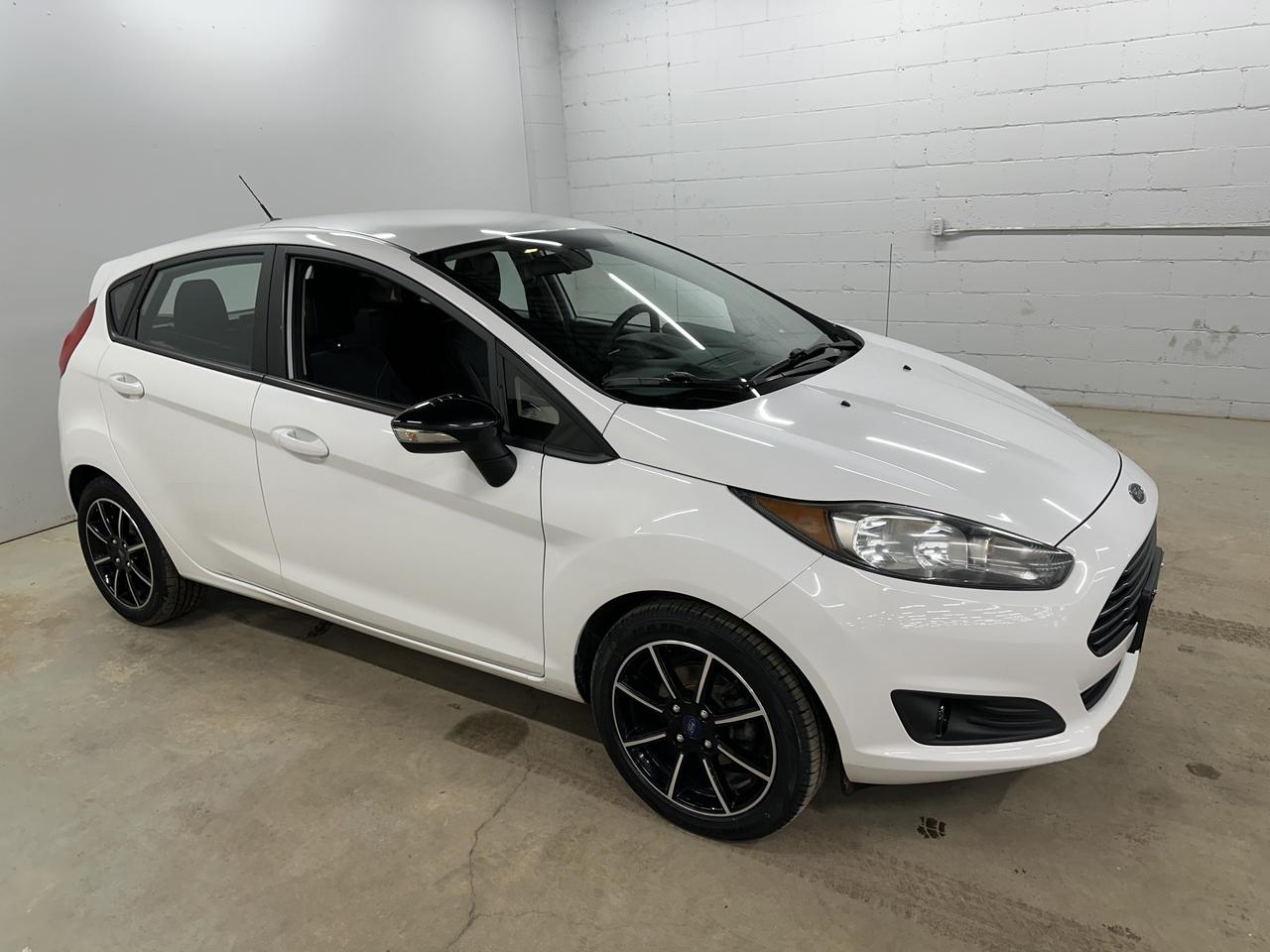 <p>Looking for a zippy and reliable ride thats perfect for navigating city streets? This 2017 Ford Fiesta SE, available now at Troys Toys, could be the perfect fit. This sleek white hatchback offers a fuel-efficient 1.6L I4 engine, paired with a smooth-shifting automatic transmission, making your daily commute a breeze. With its compact size and front-wheel drive, maneuvering through traffic and parking in tight spots is effortless. Plus, this Fiesta SE has a comfortable black interior, ready for your next adventure. With only 72,200 km on the odometer, this Fiesta is ready for many more years of driving fun!</p><p>This Fiesta SE is packed with features designed to enhance your driving experience. Step inside and youll find a car thats easy to live with. Ready to hit the road in style and comfort? Visit Troys Toys and take this fantastic Fiesta SE for a test drive!</p><p>Here are some of the features youll love:</p><ul><li><strong>Fuel-Efficient Engine:</strong> Save money at the pump with this economical engine.</li><li><strong>Hatchback Design:</strong> Enjoy the versatility of a hatchback, offering ample cargo space for your gear.</li><li><strong>Automatic Transmission:</strong> Experience smooth and effortless gear changes.</li><li><strong>Compact Size:</strong> Navigate city streets with ease, thanks to its nimble handling.</li><li><strong>Comfortable Interior:</strong> The black interior offers a stylish and inviting space.</li></ul><p><strong><em>Powered by AutoIntelligence&trade;</em></strong> Vehicle information has been generated using artificial intelligence and is provided for informational purposes only. While efforts are made to ensure accuracy, please confirm all details directly with the dealer.</p>