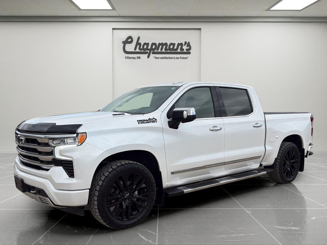 <p>Finished in Iridescent Pearl Tricoat with a Jet Black and Umber interior, this 2023 Chevrolet Silverado High Country 4WD is a premium full-size truck built for drivers who want top-level comfort and capability. With its Crew Cab layout and upscale High Country trim, it delivers a refined driving experience without sacrificing work-ready toughness.</p><p>Powered by a Duramax 3.0L Turbo-Diesel engine paired with a 10-speed automatic transmission, this Silverado offers excellent torque, efficiency, and towing performance. Equipped with 4WD and a full trailering setup, its ready for hauling, highway driving, and year-round conditions.</p><h3>Performance & Capability</h3><ul><li><p>Duramax 3.0L Turbo-Diesel engine</p></li><li><p>10-speed automatic transmission</p></li><li><p>4WD with 2-speed Autotrac transfer case</p></li><li><p>Auto-locking rear differential</p></li><li><p>Adaptive ride control</p></li><li><p>Trailering package with hitch guidance</p></li><li><p>Trailer brake controller</p></li><li><p>Stabilitrak with trailer sway control</p></li></ul><h3>Interior Comfort & Convenience</h3><ul><li><p>Heated and ventilated leather front bucket seats</p></li><li><p>Heated front seats and steering wheel</p></li><li><p>Dual-zone automatic climate control</p></li><li><p>Driver seat and mirror memory</p></li><li><p>Power rear sliding window</p></li><li><p>Remote vehicle start</p></li><li><p>Keyless open, lock, and start</p></li><li><p>Rear 60/40 folding bench seat with storage</p></li></ul><h3>Technology & Connectivity</h3><ul><li><p>13.4" touchscreen infotainment system with Google built-in</p></li><li><p>Wireless Apple CarPlay & Android Auto</p></li><li><p>12.3" digital driver information centre</p></li><li><p>Bose premium sound system</p></li><li><p>Head-up display</p></li><li><p>Rear camera mirror</p></li><li><p>SiriusXM satellite radio</p></li><li><p>OnStar with Wi-Fi hotspot capability</p></li><li><p>120V power outlets</p></li></ul><h3>Safety & Driver Assistance</h3><ul><li><p>Chevy Safety Assist suite</p></li><li><p>Automatic emergency braking</p></li><li><p>Forward collision alert</p></li><li><p>Lane keep assist with departure warning</p></li><li><p>Front pedestrian braking</p></li><li><p>HD surround vision</p></li><li><p>Trailer side blind zone alert</p></li><li><p>Front and rear park assist</p></li><li><p>Following distance indicator</p></li></ul><h3>Exterior Highlights</h3><ul><li><p>Iridescent Pearl Tricoat exterior</p></li><li><p>22" high gloss black aluminum wheels</p></li><li><p>Power up/down tailgate</p></li><li><p>ChevyTec spray-on bedliner</p></li><li><p>Chrome assist steps</p></li><li><p>LED headlamps, taillamps, and fog lamps</p></li><li><p>LED cargo bed lighting</p></li><li><p>Power folding, heated mirrors</p></li><li><p>Dual exhaust</p></li><li><p>Tri-fold hard tonneau cover</p></li></ul><p>A fully loaded diesel-powered truck that combines premium comfort, advanced technology, and serious towing capability for both work and everyday driving.</p><p>5 Year/100,000 kilometer* Powertrain Component Warranty Coverage</p><p>5 Year/100,000 kilometer* Courtesy Transportation and 24/7 Roadside Assistance</p><p>6 Year/160,000 kilometer* Sheet Metal (Rust Through) Perforation Warranty Coverage</p><p>*Whichever Comes First.</p><p>Price Includes Dealer Fee.</p><p>Price Excludes PST & GST.</p><p>Financing Options Available, Call For More Details.</p> <p><strong>*While every reasonable effort is made to ensure the accuracy of this information, we are not responsible for any error or omissions contained on these pages. Please verify any information in question with Chapman Motors Ltd.</strong></p>