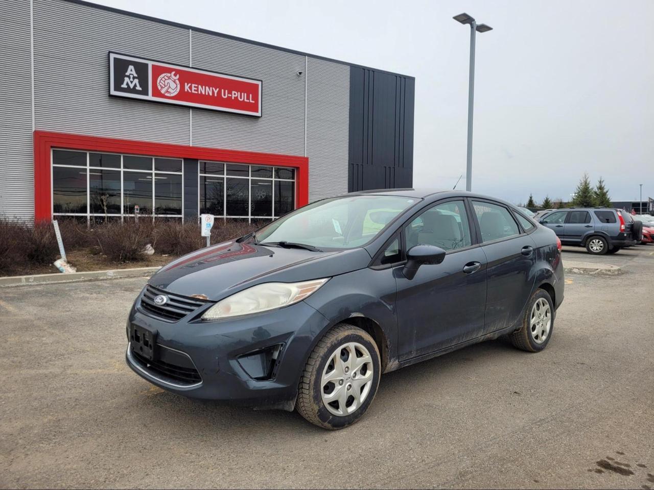 2011 Ford Fiesta in Mineral Grey metallic (Manual). The vehicle has 152,987km. The vehicle runs and drives ok. Maintenance light is on. Multiple rust spots found around the vehicle mainly on the rockers. Dent on the trunk. Parts missing on the front bumper. We dont perform any mechanical/safety inspections. The vehicle is sold as is and might need some work.