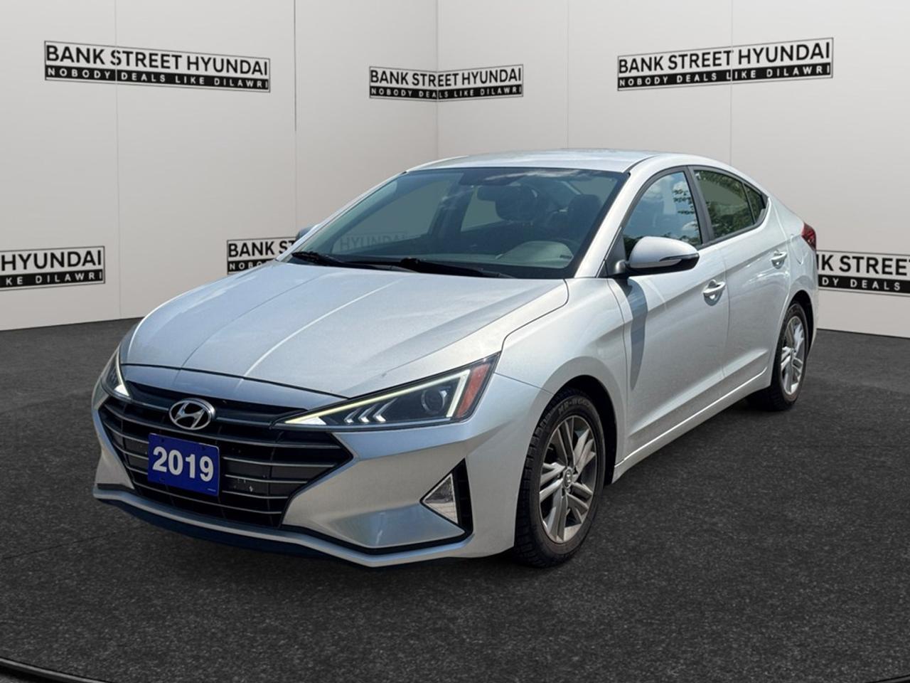 The 2019 Hyundai Elantra Preferred in shimmering Silver and with a reliable FWD drivetrain offers an exceptionally smooth ride and impressive handling for all your urban adventures. Its sleek sedan body type is thoughtfully designed to blend sophistication with modern practicality, making it a head-turner on city streets. Step inside to experience the beautifully appointed interior featuring heated front seats and a leather-wrapped steering wheel, enhanced by the elegance of piano black gear shifter material. The spacious cabin ensures that every drive is a comfortable one, whether youre commuting to work or embarking on a road trip. Stay connected and secure with advanced technology features such as a Bluetooth connection, smart device integration, and a crystal-clear backup camera. Safety is paramount in the 2019 Elantra, highlighted by features like brake assist and lane assist, providing you peace of mind on every journey. This car is perfect for individuals or families seeking a stylish, tech-equipped vehicle with top-notch safety features. Dont miss out on this opportunitycontact our dealership today for more information and let the Hyundai Elantra transform your driving experience.