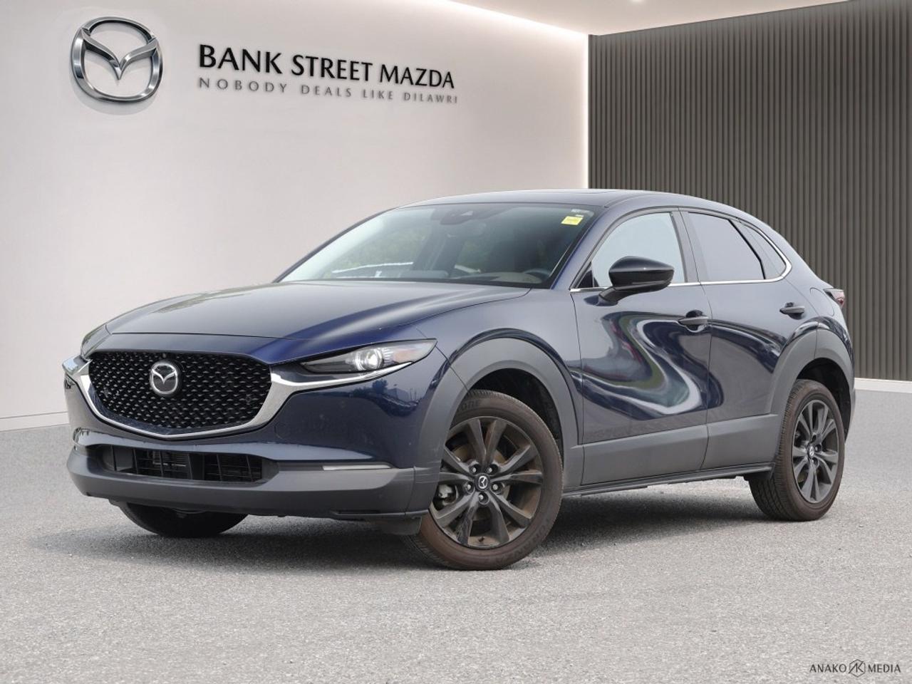 The 2022 Mazda CX-30 GT w/Turbo AWD in a striking color combines the performance of an AWD drivetrain with refined handling, ensuring youll tackle any road with confidence and style. This SUV is the perfect blend of versatility and sophistication for todays discerning driver. The exterior of the CX-30 exudes modernity with its alloy wheels and sleek lines, whilst the luxury of a sunroof/moonroof lets natural light flood into its elegantly appointed cabin. Step inside to experience genuine comfort, wrapped in sumptuous leather seats that are both heated for those chilly Canadian winters and ventilated for added comfort. The leather steering wheel and meticulously crafted leatherette door trim insert complement the interiors metal-look accents to create a harmonious environment. Immerse yourself in state-of-the-art technology with a premium navigation system displayed on a crisp screen, complete with smart device integration to keep you connected. Enjoy peace of mind with advanced safety features such as lane assist, a backup camera, and parking sensors. Embrace convenience with keyless entry, adaptive cruise control, and a heads-up display that ensures essential information is always in your line of sight. The 2022 Mazda CX-30 GT w/Turbo AWD is an ideal choice for tech-savvy individuals and families seeking a reliable yet luxurious vehicle with an edge. Contact us today to schedule a test drive and see firsthand why this dynamic SUV should be your next vehicle.