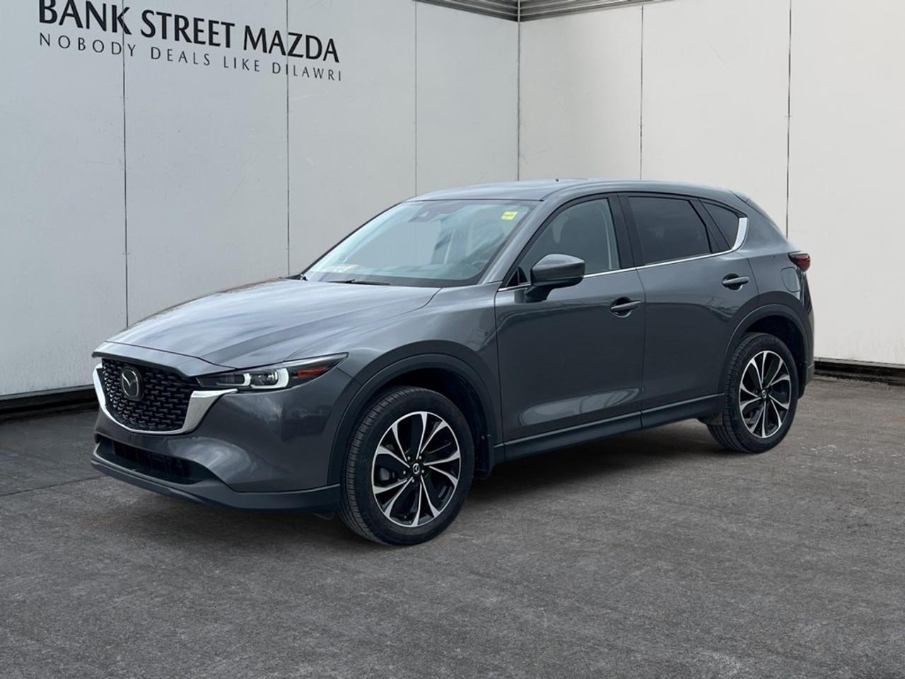 The 2023 Mazda CX-5 GT AWD arrives with a stunning exterior design and advanced all-wheel-drive handling, making it perfect for any driving condition. Its polished alloy wheels and sleek profile highlight the dynamic contours of this SUV, asserting a bold presence on the road. The inviting interior offers leather seats, a perfect blend of comfort and elegance, complemented by a sunroof that captures the sky above. This model is equipped with cutting-edge technology and safety features that enhance every journey. The intuitive heads-up display keeps critical information within sight, while the advanced navigation system ensures you always find the best route. Safety is paramount with features like lane assist and a backup camera, providing confidence and security wherever you drive. Whether youre seeking sophistication or practicality, the Mazda CX-5 GT AWD meets all demands. Ideal for families, adventurers, or anyone looking for a versatile and stylish vehicle, this SUV is ready to meet your needs. Contact us today at the dealership for more information and to experience the exceptional Mazda CX-5 GT AWD firsthand.