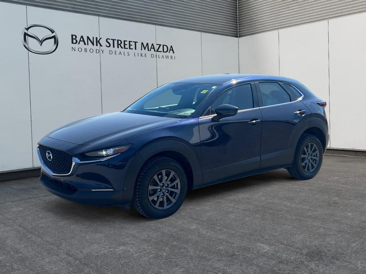 The 2021 Mazda CX-30 GX AWD, dressed in a striking Black finish, offers a confident and composed drive with its all-wheel drive system. Ideal for navigating both urban environments and rugged landscapes, this SUV combines versatility with style. The exterior showcases a modern design with sleek alloy wheels that complement its dynamic silhouette. Inside, the cabin pampers you with an interior trimmed with metal-look instrument panels and leatherette door trims, creating a sophisticated atmosphere. The heated front seats ensure comfort during those chilly Canadian winters. Tech-savvy features abound, making every journey smooth and connected. Stay in touch with smart device integration and enjoy your favorite music via the Bluetooth connection. Safety is paramount with the inclusion of a backup camera and lane assist, providing peace of mind for drivers and passengers alike. Perfectly suited for individuals or small families who value safety, comfort, and style, the Mazda CX-30 GX AWD invites you to elevate your driving experience. Contact our dealership today for more information and to schedule a test drive.