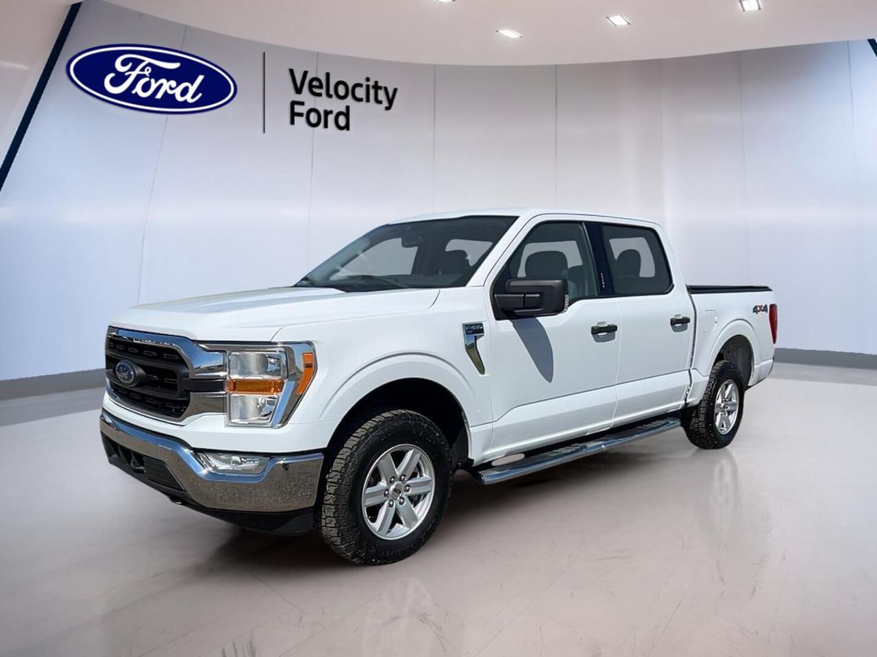 Built to handle work, weather, and daily driving with ease, this used 2021 Ford F-150 XLT 4WD SuperCrew 5.5 Box is a smart full-size truck for life in Saskatchewan. Offered by Velocity Ford in Moose Jaw, it pairs proven V8 power with four full doors, a practical 5.5-foot box, and strong towing ability.

Finished in White with a Black interior, this 2021 Ford F-150 XLT 4WD SuperCrew 5.5 Box has a clean, confident look and a functional cabin layout. With 119,164 km, automatic transmission, and a 5.0-litre unleaded engine, it is ready for the jobsite, the highway, and weekends at the lake.

FEATURES OF THE F-150 XLT 4WD SuperCrew 5.5 Box COMING SOON
»» 5.0-litre V8 with automatic transmission
»» Four full doors for easy access
»» 4WD capability for year-round traction
»» 5.5-foot box for versatile utility

TRUCK FEATURES
»» Tows up to 4,580 kg confidently
»» Rear tow hook adds useful function
»» Off-road tires support rougher terrain
»» SuperCrew cab boosts passenger practicality

ADVANCED SAFETY FEATURES
»» Backup camera helps with reversing
»» Lane departure warning adds awareness
»» Blind spot monitor improves lane checks
»» Side and head airbags enhance protection

PERFORMANCE AND EFFICIENCY
»» 5.0-litre unleaded V8 delivers solid power
»» Automatic transmission supports smooth shifting
»» Dual shift mode adds control
»» Four-wheel drive improves traction year-round

COMFORT AND CONVENIENCE
»» Cruise control supports relaxed highway travel
»» Front air conditioning keeps cabin comfortable
»» Power windows add everyday convenience
»» Driver and passenger lumbar support

TECHNONOLGY AND CONNECTIVITY
»» Bluetooth integration supports hands-free calling
»» WiFi hotspot keeps devices connected
»» Steering wheel audio controls add ease
»» Automatic headlights respond to changing light

CARGO SPACE
»» 5.5-foot box suits daily hauling
»» Rear trunk access aids loading ease
»» Spacious cabin handles crew and gear
»» Spare tire adds roadside confidence

AWARDS & RECOGNITIONS
»» North American Truck of the Year, North American Car, Utility and Truck of the Year, 2021
»» Best Buy Award, The Car Guide, 2021

WHAT OTHER OWNERS LIKE
»» Strong V8 performance feels confident
»» Comfortable ride for a full-size truck
»» Useful crew cab interior space
»» Solid towing and everyday versatility

This 2021 Ford F-150 XLT 4WD SuperCrew 5.5 Box delivers the capability many truck buyers want without overcomplicating the experience. Power steering, anti-lock braking system, stability control, heated mirrors, electric mirrors, fog lights, tinted windows, rear window defroster, child safety locks, and automatic door locks all add to its everyday value.

This Ford is also equipped with practical details that matter on busy days, including tire pressure monitoring, passenger airbag sensor, illuminated driver and passenger vanity mirrors, and adjustable steering wheel controls. The result is a truck that feels ready for commuting, hauling, towing, and handling changing road conditions with confidence.

For drivers who want V8 strength, a roomy SuperCrew cabin, and dependable 4WD capability, this F-150 stands out as a hardworking choice. It offers the right mix of comfort, utility, and proven truck performance for Moose Jaw roads and beyond.

This 2021 Ford F-150 XLT 4WD SuperCrew 5.5 Box COMING SOONs VIN is: 1FTFW1E54MKE60081.