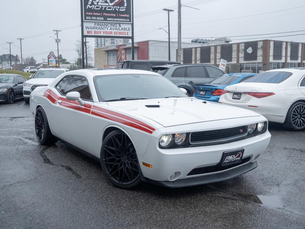 2012 Dodge Challenger Coupe | 5.7L HEMI V8 | 372 HP | Automatic | Classic American Muscle<br/> <br/> White Exterior | Black Leather Interior | 5.7L Naturally Aspirated HEMI V8 Engine | 372 Horsepower / 401 lb‑ft of Torque | 5‑Speed Automatic Transmission with Autostick | Rear‑Wheel Drive | Sport‑Tuned Suspension | Dual Exhaust System | 20‑Inch Alloy Wheels | HID Headlamps | Heated Front Seats | Power Driver Seat | Dual‑Zone Automatic Climate Control | Touchscreen Infotainment System | Bluetooth Connectivity | Premium Audio System | Push‑Button Start | Keyless Entry | Stability Control | Traction Control | Performance Brakes | and much much more <br/> <br/> <br/> Features Include: <br/> 5.7L HEMI V8 | Automatic Transmission with Paddle‑Shift Functionality | Dual Exhaust | Sport Suspension | 20‑Inch Performance Wheels | Heated Front Seats | Leather‑Wrapped Steering Wheel | Bluetooth Hands‑Free | Touchscreen Display | Power Adjustable Driver Seat | Cruise Control | Performance Instrumentation | Iconic Wide‑Body Muscle Car Stance <br/> <br/> <br/> The 2012 Dodge Challenger HEMI delivers iconic V8 performance, bold muscle‑car styling, and the convenience of an automatic transmission—making it both thrilling and easy to drive. <br/> <br/> <br/> Key Features <br/> <br/> <br/> Timeless Muscle Car Design <br/> Finished in classic white, the Challenger’s long hood, wide shoulders, and aggressive stance pay homage to Dodge’s legendary muscle‑car heritage. Retro‑inspired design cues combined with modern details give this coupe undeniable road presence. <br/> <br/> <br/> Comfortable, Driver‑Focused Interior <br/> The black leather interior offers a blend of classic muscle attitude and everyday comfort. Heated front seats, a thick leather‑wrapped steering wheel, and intuitive controls create a cockpit designed for spirited driving and relaxed cruising alike. <br/> <br/> <br/> Straightforward Technology <br/> Equipped with a touchscreen infotainment system, Bluetooth connectivity, steering‑wheel controls, and dual‑zone climate control, the Challenger delivers essential modern convenience while keeping the focus on driving. <br/> <br/> <br/> Legendary HEMI V8 Performance <br/> Under the hood, the 5.7L HEMI V8 produces 372 horsepower and 401 lb‑ft of torque, offering strong acceleration, a deep exhaust note, and unmistakable muscle‑car character. The 5‑speed automatic transmission provides smooth shifts with the option of manual control via Autostick for added driver engagement. <br/> <br/> <br/> Power You Can Control <br/> Rear‑wheel drive, a sport‑tuned suspension, and stability control systems help channel the HEMI’s power confidently—whether launching from a stop or cruising effortlessly on the highway. <br/> <br/> <br/> Pure American Muscle <br/> With its naturally aspirated V8, bold styling, and comfortable automatic setup, this Challenger stands as one of the last true American muscle coupes—built for drivers who appreciate sound, presence, and performance. <br/> <br/> <br/> The 2012 Dodge Challenger 5.7L HEMI Automatic isn’t just a car—it’s a bold statement of American horsepower and timeless muscle‑car pride. <br/> <br/> <br/> This vehicle has travelled 118,519 Kms. <br/> <br/> <br/> *** NO additional fees except for taxes and licensing! *** <br/> <br/> <br/> *** 100-point inspection on all our vehicles & always detailed inside and out *** <br/> <br/> <br/> RevMotors is at your service to ensure you find the right car for YOU. Even if we do not have it in our inventory, we are more than happy to find you the vehicle that you are looking for. Give us a call at 613-791-3000 or visit us online at www.revmotors.ca <br/> <br/> <br/> Ça nous donnera du plaisir de vous servir en Français aussi! <br/> <br/> <br/> CERTIFICATION * This vehicle is sold Certified for the province of Ontario (Quebec Safety Available, additional charges may apply) <br/> FINANCING AVAILABLE * RevMotors offers competitive finance rates through many of the major banks. Should you feel like youve had credit issues in the past, we have various financing solutions to get you on the road. We accept No Credit - New Credit - Bad Credit - Bankruptcy - Students and more!! Please keep in mind the default loan structure found on the vehicle page is a template. The exact rate and terms that a vehicle qualifies for may differ. All quotes are subject to lender approval. <br/> EXTENDED WARRANTY * For your peace of mind, if one of our used vehicles is no longer covered under the manufacturer’s warranty, RevMotors will provide you with a 6 month / 6000KMS Limited Powertrain Warranty. You always have the options to upgrade to more comprehensive coverage as well. Well be more than happy to review the options and chose the coverage thats right for you! <br/> TRADES * Do you have a Trade-in? We offer competitive trade in offers for your current vehicle! <br/> SHIPPING * We can ship anywhere across Canada. Give us a call for a quote and we will be happy to help! <br/> <br/> <br/> Buy with confidence knowing that we always have your best interests in mind! <br/>