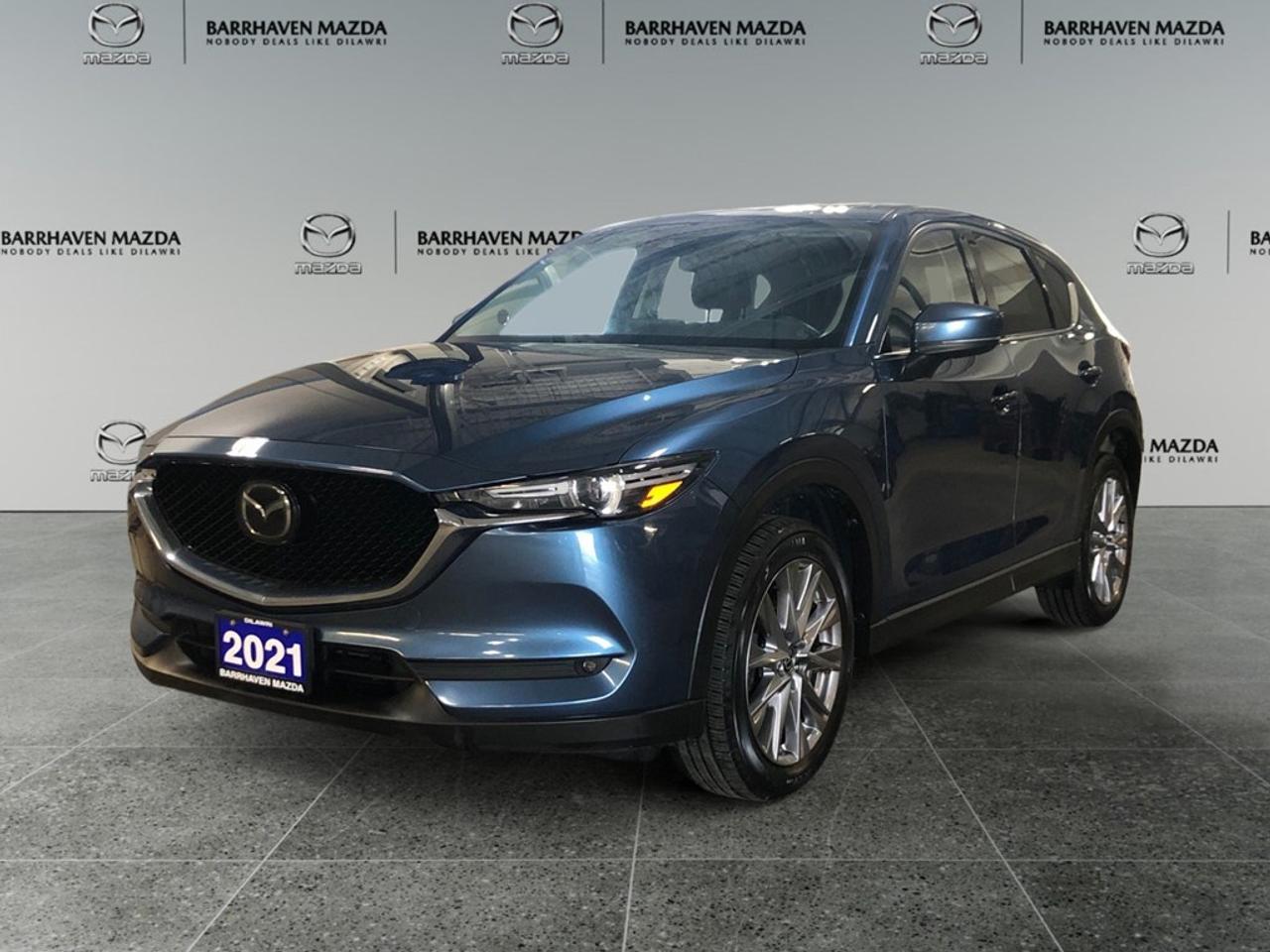 The 2021 Mazda CX-5 GT, dressed in a stunning blue, offers a refined all-wheel-drive experience that boasts excellent handling for any road condition. This SUV stands out with its well-crafted exterior, featuring alloy wheels and a sophisticated silhouette. Inside, the CX-5 GT greets you with plush leather seats and leatherette door trims for an elevated driving experience. Front and rear passengers can enjoy heated seats, complemented by a heated steering wheel for those colder Canadian mornings. The cooled front seats provide extra comfort in warmer weather, and the power sunroof allows you to take in the scenic views in style. Equipped with advanced technology, the CX-5 GT offers a comprehensive navigation system, a heads-up display, and smart device integration to keep you connected on the go. Safety is paramount, with features like lane assist, adaptive cruise control, and a backup camera providing enhanced peace of mind while on the road. This all-around SUV is perfect for those seeking a balance of luxury and performance, making it an ideal choice for families and adventure-seekers alike. To learn more about the 2021 Mazda CX-5 GT and experience its exceptional features firsthand, contact our dealership today.