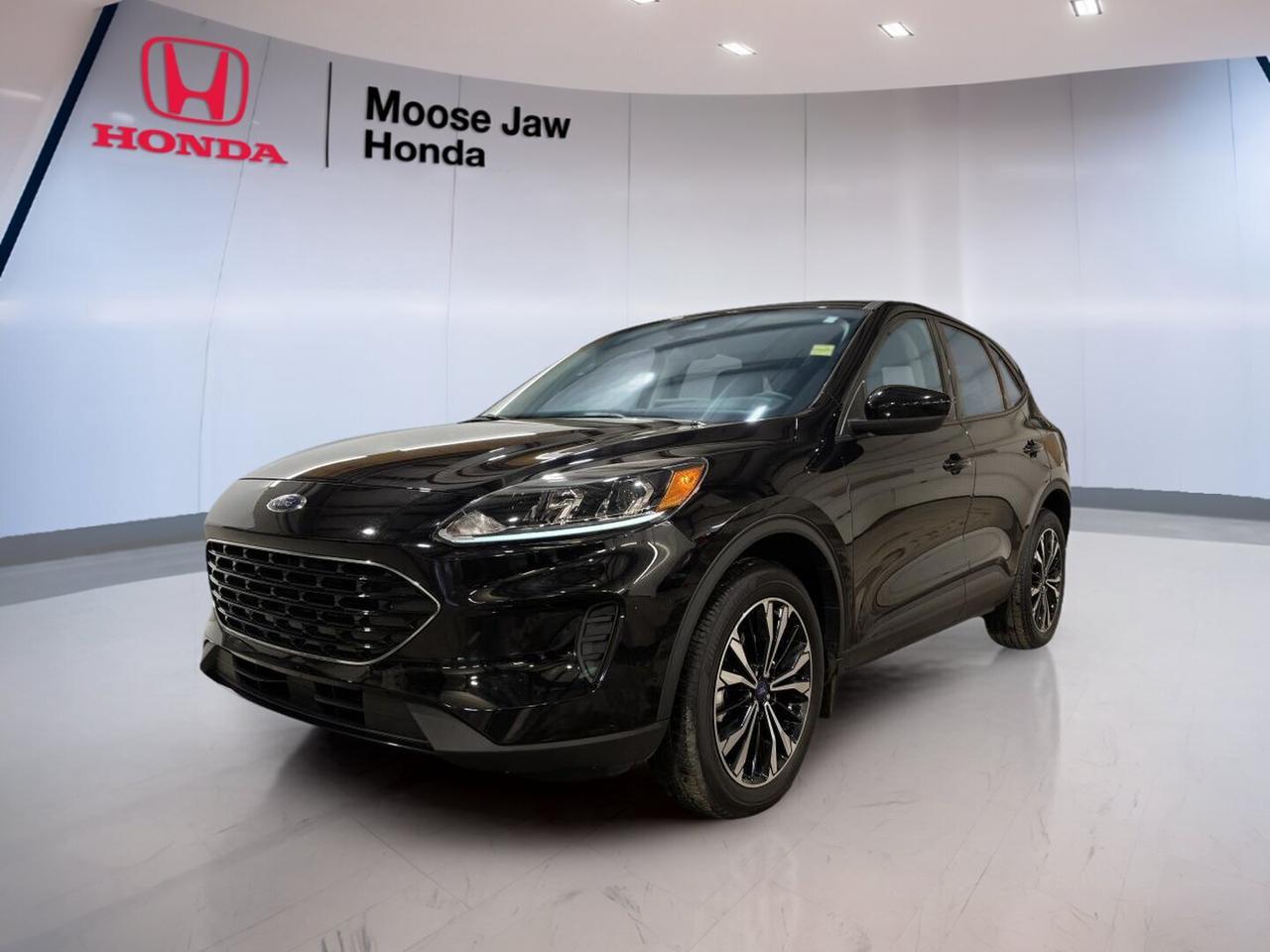 Meet the 2022 Ford Escape SE, a smart used SUV at Moose Jaw Honda in Moose Jaw. This all-wheel-drive model pairs a 1.5L EcoBoost engine with an 8-speed automatic transmission for easy daily driving. It is practical, efficient, and well suited to Saskatchewan roads in every season.

The 2022 Ford Escape SE brings a modern design, a roomy cabin, and confident road manners. Its compact size makes city parking simple, while its SUV shape gives you flexible cargo space and a comfortable ride. This Escape SE is built for commuting, errands, and weekend travel alike.

FEATURES OF THE Escape SE

»» 1.5L EcoBoost turbocharged four-cylinder engine
»» 8-speed automatic transmission included
»» All-wheel drive for added traction
»» Two-row SUV with flexible interior

ADVANCED SAFETY FEATURES

»» AdvanceTrac helps improve road holding
»» Multiple airbags support occupant protection
»» Tire pressure monitoring adds awareness
»» Rear child safety door locks

PERFORMANCE AND EFFICIENCY

»» 1.5L EcoBoost balances power and economy
»» 8-speed automatic shifts smoothly daily
»» All-wheel drive supports year-round confidence
»» Compact SUV size aids manoeuvrability

COMFORT AND CONVENIENCE

»» Spacious cabin for daily family use
»» Four-door access makes entry easier
»» Flexible rear seating supports versatility
»» Elevated ride height improves visibility

TECHNONOLGY AND CONNECTIVITY

»» Driver information display keeps data visible
»» Easy controls support daily operation
»» Modern cabin layout feels user-friendly
»» Smart design keeps essentials close

CARGO SPACE

»» Rear cargo area fits daily gear
»» Split-folding rear seat adds flexibility
»» Wide opening helps loading items
»» SUV layout supports active lifestyles

AWARDS & RECOGNITIONS

»» Top Safety Pick, Insurance Institute for Highway Safety, 2022

WHAT OTHER OWNERS LIKE

»» Good fuel economy for SUV duty
»» Comfortable ride in daily traffic
»» Useful cargo space for families
»» Confident all-wheel drive in winter

The 2022 Ford Escape SE is a great fit for drivers who want efficiency, utility, and everyday confidence. Its turbocharged engine delivers responsive performance, while the 8-speed automatic helps keep the drive smooth and refined. All-wheel drive adds extra peace of mind when weather and road conditions change.

Inside, the 2022 Ford Escape SE offers the kind of versatility many drivers want from a compact SUV. It has a practical layout, easy access for passengers, and cargo flexibility that helps with shopping trips, sports gear, or luggage. The cabin is designed to make everyday use simple and comfortable.

For drivers in Moose Jaw looking for a used SUV with proven value, the 2022 Ford Escape SE stands out with balanced performance and smart practicality. It is easy to live with, easy to drive, and ready for workdays or weekends. This vehicle delivers the core features that matter most.

This 2022 Ford Escape SEs VIN is: 1FMCU9G64NUB18130.<p> a smart used SUV at Moose Jaw Honda in Moose Jaw. This all-wheel-drive model pairs a 1.5L EcoBoost engine with an 8-speed automatic transmission for easy daily driving. It is practical</p>
<p> and well suited to Saskatchewan roads in every season.

The 2022 Ford Escape SE brings a modern design</p>
<p> while its SUV shape gives you flexible cargo space and a comfortable ride. This Escape SE is built for commuting</p>
<p> and weekend travel alike.

FEATURES OF THE Escape SE

»» 1.5L EcoBoost turbocharged four-cylinder engine
»» 8-speed automatic transmission included
»» All-wheel drive for added traction
»» Two-row SUV with flexible interior

ADVANCED SAFETY FEATURES

»» AdvanceTrac helps improve road holding
»» Multiple airbags support occupant protection
»» Tire pressure monitoring adds awareness
»» Rear child safety door locks

PERFORMANCE AND EFFICIENCY

»» 1.5L EcoBoost balances power and economy
»» 8-speed automatic shifts smoothly daily
»» All-wheel drive supports year-round confidence
»» Compact SUV size aids manoeuvrability

COMFORT AND CONVENIENCE

»» Spacious cabin for daily family use
»» Four-door access makes entry easier
»» Flexible rear seating supports versatility
»» Elevated ride height improves visibility

TECHNONOLGY AND CONNECTIVITY

»» Driver information display keeps data visible
»» Easy controls support daily operation
»» Modern cabin layout feels user-friendly
»» Smart design keeps essentials close

CARGO SPACE

»» Rear cargo area fits daily gear
»» Split-folding rear seat adds flexibility
»» Wide opening helps loading items
»» SUV layout supports active lifestyles

AWARDS & RECOGNITIONS

»» Top Safety Pick</p>
<p> 2022

WHAT OTHER OWNERS LIKE

»» Good fuel economy for SUV duty
»» Comfortable ride in daily traffic
»» Useful cargo space for families
»» Confident all-wheel drive in winter

The 2022 Ford Escape SE is a great fit for drivers who want efficiency</p>
<p> while the 8-speed automatic helps keep the drive smooth and refined. All-wheel drive adds extra peace of mind when weather and road conditions change.

Inside</p>
<p> the 2022 Ford Escape SE offers the kind of versatility many drivers want from a compact SUV. It has a practical layout</p>
<p> or luggage. The cabin is designed to make everyday use simple and comfortable.

For drivers in Moose Jaw looking for a used SUV with proven value</p>
<p> the 2022 Ford Escape SE stands out with balanced performance and smart practicality. It is easy to live with</p>
<p> and ready for workdays or weekends. This vehicle delivers the core features that matter most.

This 2022 Ford Escape SEs VIN is: 1FMCU9G64NUB18130.</p>